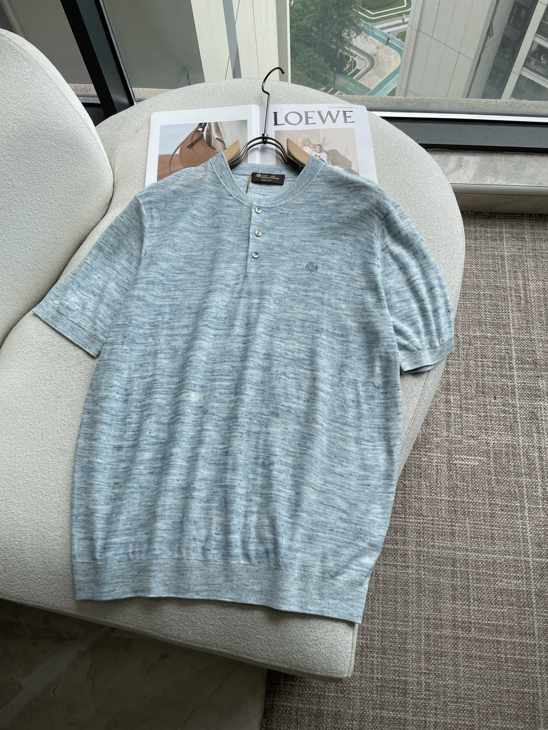 NO:946845,LSS new spring and summer henley collar linen blended knitted short-sleeved T-shirt!  The relaxed Italian gentleman integrates the brand's iconic comfortable aesthetics into casual items and uses the natural texture of linen blend to create a relaxed gentleman style in spring and summer.  The fabric is made of linen + acrylic blended knitting. The floral yarn texture has a distressed texture. The breathability and dryness of linen are perfectly combined with the drape and wrinkle resistance of acrylic. The upper body is light and not sweaty, while taking into account the practicality of not being easily deformed. The classic Henry collar design, with three dark shell buttons on the placket, is low-key and detailed; the same color embroidered brand badge on the left chest is the finishing touch of brand recognition.  The style is restrained and high-end. The neat ribbed cuffs and hem give the silhouette just the right amount of looseness, and the body-friendly tailoring is suitable for most scenes. The floral gauze options in light blue, camel, and dark gray come with built-in retro filters. Paired with casual linen shorts, it is a relaxed look for weekend outings. Paired with casual trousers, it can also be used in light business occasions, making it easy to wear one outfit for multiple wears.  From the texture of the fabric, the neatness of the wiring, to the brand logo in the details, this T-shirt integrates Loro Piana's Italian elegance genes into daily life. In an unobtrusive way, it can easily create a style model that coexists with a sense of luxury and relaxation. Color blue, khaki, black Size 48-56 Size reference 48 size: shoulder width 44 chest size 98 length 67 Size 50: shoulder width 45 chest size 102 length 68  Code 52: shoulder width 46, bust 106, length 69 Code 54: shoulder width 47, bust 110, length 70 Code 56: shoulder width 48, bust 114, length 71, loro piana, shorts, T-shirt, tees, t-shirt,19860909LSS春夏新款亨利领亚麻混纺针织短袖T恤！ 松弛感意式绅士,将品牌标志性的舒适美学融入休闲单品,用亚麻混纺的天然质感,打造春夏的松弛绅士格调. 面料采用亚麻+腈纶混纺针织打造,花纱肌理自带做旧质感,亚麻的透气干爽与腈纶的垂坠抗皱完美结合,上身轻盈不闷汗,同时兼顾了不易变形的实用性.经典的亨利领设计,搭配三颗深色贝壳扣门襟,低调中带着细节质感；左胸的同色系刺绣品牌徽章,是品牌辨识度的点睛之笔,克制而高级.利落的罗纹收边袖口与下摆,让版型呈现恰到好处的微宽松效果,不挑身形的剪裁适配绝大多数场景.浅蓝、驼色、深灰三色的花纱选择,自带复古滤镜,搭配休闲亚麻短裤是周末出游的松弛感造型,搭配休闲西裤也能胜任轻商务场合,轻松实现一衣多穿. 从面料的肌理、走线的工整,到细节处的品牌标识,这件T恤将Loro Piana的意式优雅基因融入日常,用不张扬的方式,轻松打造出高级感与松弛感并存的穿搭范本. 颜色蓝色、卡其色、黑色 尺码48-56 尺寸参考 48码:肩宽44胸围98衣长67 50码:肩宽45胸围102衣长68 52码:肩宽46胸围106衣长69 54码:肩宽47胸围110衣长70 56码:肩宽48胸围114衣长71,,loro piana,shorts,T-shirt,tees，t-shirt,,Men's clothing