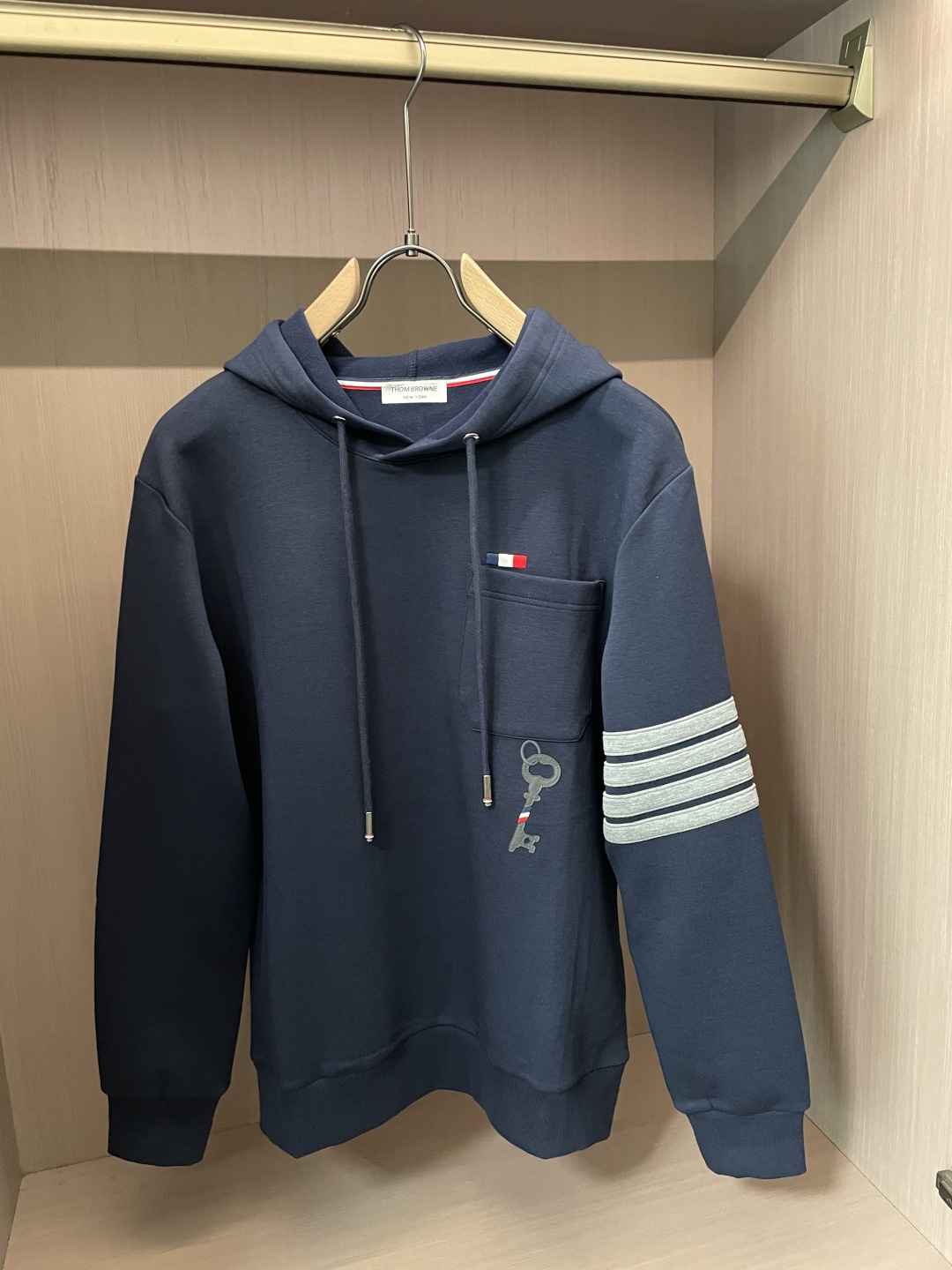 型号L901QD#，TB家 2026秋冬最新钥匙绣标男士连帽运动衫，传统套头带帽卫衣款型，胸前雅致口袋设计，搭配经典红白