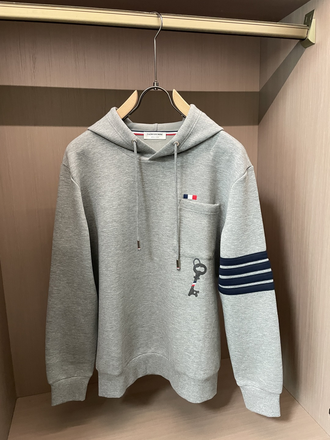型号L901QD#，TB家 2026秋冬最新钥匙绣标男士连帽运动衫，传统套头带帽卫衣款型，胸前雅致口袋设计，搭配经典红白