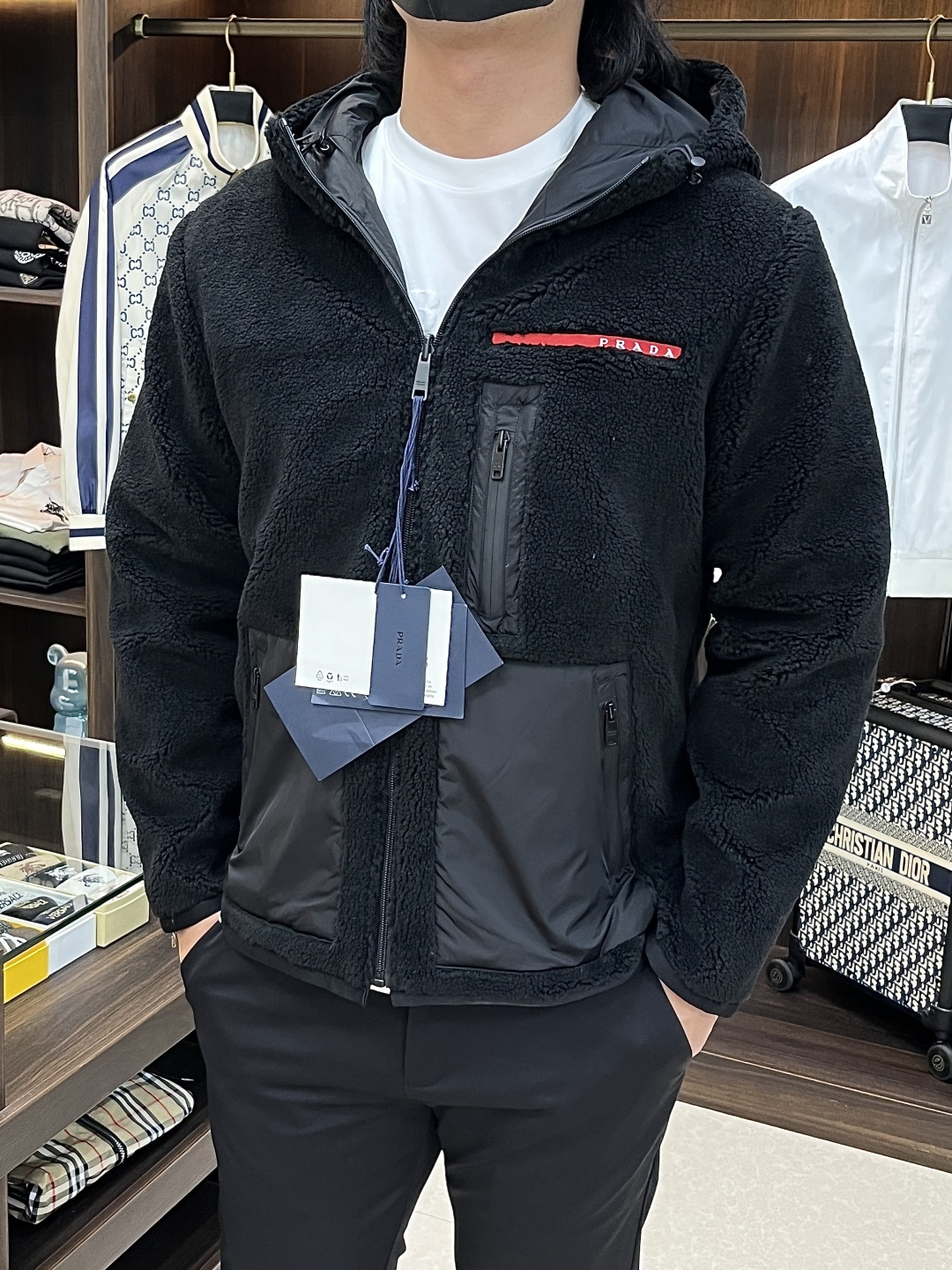 NO:746672,The main recommendation is Prada's new reversible hooded jacket. This jacket is designed with polar fleece and windproof fabrics, which is both warm and functional. The red brand logo on the chest and the three-dimensional pocket design are its iconic details. The overall style is tough yet urban and casual, suitable for various scenes in autumn and winter. The style is novel and unique, highly recommended!  Color Black Size S M L XL H2026,,prada,jackets & coats,hats,19860909主推 Prada 家新款双面穿连帽夹克,这款夹克采用摇粒绒与防风面料拼接设计,兼具保暖性与机能感.胸前红色品牌标识和立体口袋设计是其标志性细节,整体风格硬朗又不失都市休闲感,适合秋冬季节的多场景穿搭.款式新颖别致,强烈推荐！ 颜色黑色 码数S M L XL H2026,,prada,jackets & coats,hats,,Men's clothing