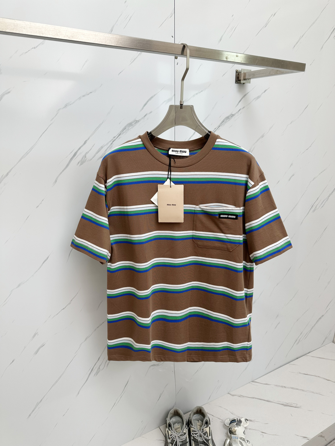 NO:141912,Miu Miu 2025 new striped round neck short-sleeved T-shirt top for men and women. This striped short-sleeved T-shirt, combining brown and blue green and white stripes, is simple and elegant. The chest pocket and brand label add details, the fabric is comfortable, suitable for daily wear, and shows a fashionable and casual style. Color brown Size S-XXL,,miumiu,T-shirt,tees,t-shirt,alexander wang19860909Miu Miu 缪缪2025新款条纹圆领短袖T恤上衣男女同款 这款条纹短袖T恤,棕色与蓝绿白条纹相结合,简洁大方.胸前口袋和品牌标签增添细节,面料舒适,适合日常穿搭,展现时尚休闲风. 颜色咖色 尺码S-XXL,,miumiu,T-shirt,tees，t-shirt,alexander wang,Men's clothing