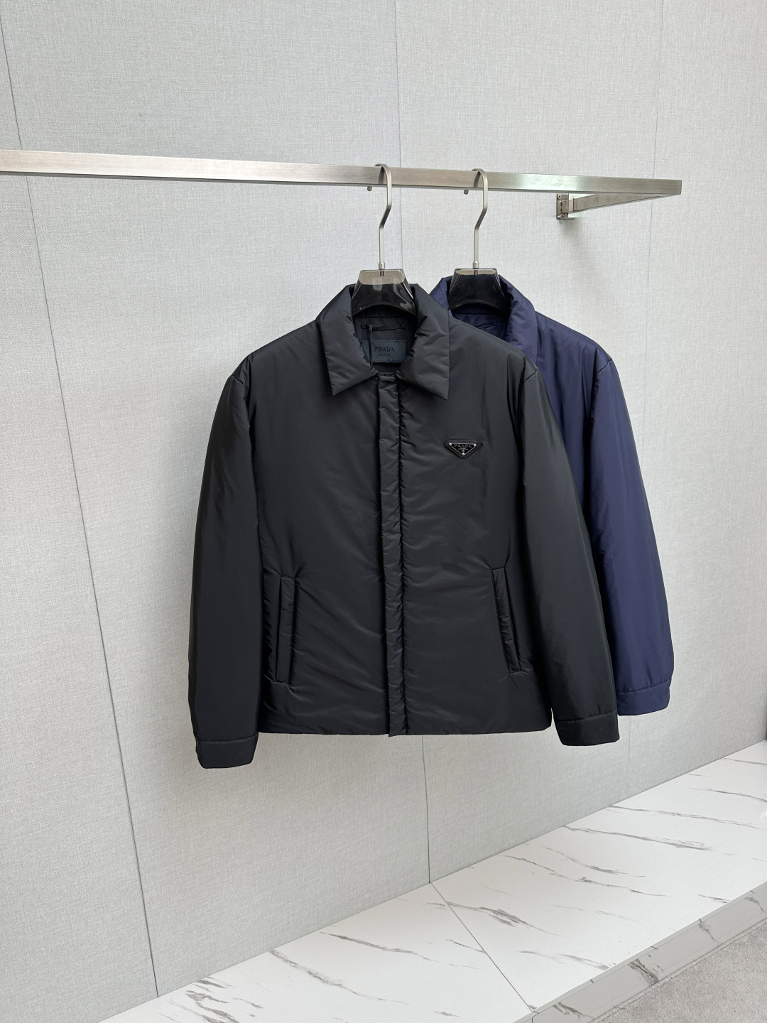 NO:510198,Prada 25 autumn and winter lapel jacket Prada's lapel jacket adopts high-quality cotton filling process, processed through multiple processes, and has high-quality filling materials. It has good warmth and can store a lot of air to achieve good warmth and maintain excellent warmth performance in humid environments. The lapel design is neat and elegant, showing the calmness and confidence of a gentleman. The chest is embellished with brand logo to enhance recognition and exquisiteness, simple without losing the design, highlighting the brand style, making the overall shape more highlighted. Classic style, straight-tube tailoring is not restricted, the layout is neat, suitable for a variety of occasions, and can show capable temperament. The lapel style is simple and elegant, modifying the neckline, and easily cope with different outfit needs. Number of 48 50 52 54 56 Color black blue,,prada,jackets & coats,alexander  wang19860909Prada 25秋冬款翻领外套 Prada这款翻领外套采用了高品质棉花填充工艺,经多道工序处理,优质填充材料.保暖性好,能储存大量空气来达到良好的保暖效果,在潮湿环境下仍能保持优异的保暖性能. 翻领设计,利落且优雅,彰显绅士的从容与自信.胸前有品牌标识点缀,提升辨识度与精致感,简约而不失设计感,彰显品牌格调,让整体造型更具亮点. 经典版型,直筒剪裁不束缚,版型设计利落,适配多种场合,能展现干练气质.翻领款式简约大方,修饰颈部线条,轻松应对不同穿搭需求.  码数48 50 52 54 56  颜色黑色 蓝色,,prada,jackets & coats,alexander wang,Men's clothing