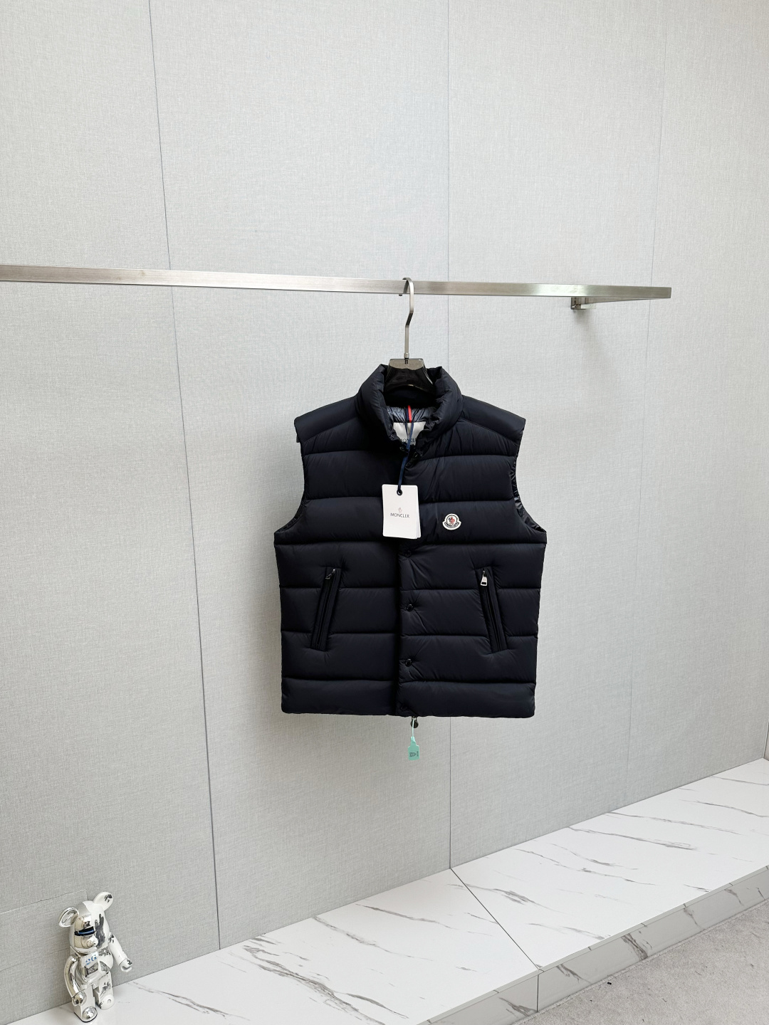 NO:571950,MOC25RFW new autumn and winter black matte nylon stand collar down vest, the same classic felt badge fashion warm down vest jacket for men and women!  The trading company channel is rarely available, and it is available for sale on the official website at the same time for 10620RMB!  Fameng's new down vest uses high-end materials, exquisite craftsmanship and thoughtful design to bring you a dual experience of warmth and fashion!  In this cold season, wear it to make yourself the most dazzling presence on the street!   This vest is made of imported black matte nylon material. Compared with ordinary nylon fabrics, it is a little less ostentatious and shiny, but has a little more low-key and luxurious charm!  The contrasting paint nylon lining is ingeniously designed and has good breathability. Even in cold winters, the heat and moisture generated by the body can be quickly discharged, keeping the body dry and comfortable!  At the same time, it can also effectively prevent down from drilling out, avoiding the embarrassing situation that traditional down jackets tend to have, greatly improving the comfort of wearing it!  The interior is filled with high-quality 90% white duck down, and every feather is light and fluffy, as if it contains endless warm energy!  The designer cleverly used horizontal quilting technology to evenly fill the inside of the vest with white duck down. This grid filling method not only makes the vest look fuller and more stylish, but also effectively fixes the down to prevent it from accumulating or shifting during wearing!  The classic felt badge on the chest is beautifully designed and crafted with exquisite craftsmanship, and every detail is handled just right!  It not only adds a unique personality and sense of fashion to the vest, but also acts as a status symbol, highlighting the wearer's pursuit of quality and taste!  The placket adopts a four-button zipper double opening and closing method. This design not only ensures the firmness and sealing of the placket, but also makes it easier for the wearer to put on and take off!  When you zip up the zipper and fasten the snap button, the entire fly is like a solid line of defense, keeping the cold out!  All accessories are engraved with the brand logo, which not only reflects the brand's strict control of quality, but also highlights the brand's unique charm and cultural connotation!  The small stand-up collar design is simple yet elegant. It can not only protect the neck from the cold wind, but also show a capable and neat temperament!  The fitted version follows the curves of the body and is neither too loose and bulky nor too tight to restrict movement!  Sizes 1-5 Size 1 has a shoulder width of 44cm - bust 114cm - dress length 68cm Size 2 has a shoulder width of 45cm - bust 118cm - dress length 69cm Size 3 has a shoulder width of 46cm - bust 122cm - dress length 70cm Size 4 has a shoulder width of 47cm - bust 126cm - dress length 72cm Size 5 has a shoulder width of 48cm - bust cm - dress length 74cm Size recommendations (standard version)  Height 174-jin, tried on size 2 and it fits!  For boys, choose size 1 if you weigh less than 143 pounds, choose size 2 if you weigh -143 pounds, choose size 3 if you weigh 143-156 pounds, choose size 4 if you weigh 156-172 pounds, and choose size 5 if you weigh 172-188 pounds!  All girls can choose size 1!  ,,jackets & coats,down jacket,alexander wang19860909MOC25RFW秋冬新款黑色哑光尼龙立领羽绒马甲,男女同款经典毛毡徽章时尚保暖羽绒马甲外套！贸易公司渠道稀出,同步官网发售10620RMB！法蒙家新款羽绒马甲奉献,采用高级的材质、精湛的工艺和贴心的设计,为你带来温暖与时尚的双重体验！在这个寒冷的季节里,穿上它让自己成为街头最耀眼的存在！  该马甲采用客供进口黑色哑光尼龙材质,与普通的尼龙面料相比,它少了几分张扬的光泽,却多了几分低调而奢华的韵味！撞色漆面尼龙内衬,设计堪称巧妙,具有良好的透气性,即使在寒冷的冬日里,身体产生的热气和湿气也能迅速排出,保持身体的干爽舒适！同时它还能有效防止羽绒钻出,避免了传统羽绒服容易出现钻绒的尴尬情况,大大提升了穿着的舒适性！内里选用了优质的90白鸭绒作为填充物,每一根羽毛都轻盈蓬松,仿佛蕴含着无尽的温暖能量！设计师巧妙地采用了横向绗缝技术,将白鸭绒均匀地分格填充在马甲内部,这种分格填充的方式不仅让马甲看起来更加饱满有型,还能有效地固定羽绒,防止其在穿着过程中出现堆积或移位的情况！ 胸前经典毛毡徽章,设计精美工艺精湛,每一个细节都处理得恰到好处！它不仅为马甲增添了一份独特的个性和时尚感,更像是一种身份的象征,彰显着穿着者对品质和品味的追求！门襟采用了四合扣拉链双重开合的方式,这种设计既保证了门襟的牢固性和密封性,又方便了穿着者的穿脱！当你拉上拉链,再扣上四合扣,整个门襟就像一道坚固的防线,将寒冷隔绝在外！所有的辅料均刻有品牌 Logo,这不仅体现了品牌对品质的严格把控,更彰显了品牌的独特魅力和文化内涵！小立领设计简约而不失优雅,既能很好地保护颈部免受寒风的侵袭,又能展现出一种干练利落的气质！合体的版型则贴合身体曲线,既不会过于宽松显得臃肿,也不会过于紧身限制活动！尺码1-5 1码肩宽44cm-胸围114cm-衣长68cm 2码肩宽45cm-胸围118cm-衣长69cm 3码肩宽46cm-胸围122cm-衣长70cm 4码肩宽47cm-胸围126cm-衣长72cm 5码肩宽48cm-胸围cm-衣长74cm 尺码推荐（标准版型） 身高174-斤,试穿2码合适！ 男生体重斤以内选择1码,-143斤选择2码,143-156斤选择3码,156-172斤选择4码,172-188斤选择5码！ 女生全部选择1码即可！,,jackets & coats,down jacket,alexander wang,Men's clothing