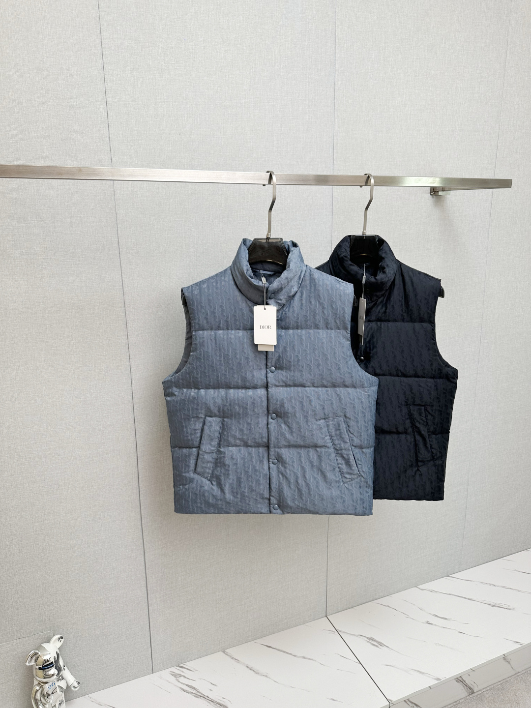 NO:657940,High version (with logo on the lining) with exclusive dust bag DR DIoR 25FW new down vest  The fabric uses scientific jacquard technology to apply laser jacquard technology to the fabric, making the entire piece more concave and convex, with a stronger three-dimensional effect. This technology not only improves the visual effect of the fabric, but also enhances the durability and comfort of the fabric. The custom-woven high-density satin nylon material, combined with the dark jacquard weave method, makes the down highly waterproof, anti-fouling, and dust-proof. This ensures that it can maintain good appearance and performance in bad weather.  Printing process Oblique printing is applied to the fabric through precise printing technology, perfectly integrating with the fabric, showing a low-key and luxurious visual effect. The down filling is strictly processed and screened to ensure the fluffiness and warmth of the down. The down is evenly filled into the liner and fixed by sewing and gluing.  Detail processing is carried out on the collar, cuffs, hem and other parts to improve the practicality and beauty. At the same time, ironing and inspection are carried out to ensure that the product quality meets the standards. Black, same style for men and women!  SIZE: S-XL three standard complete, dior, down jacket, alexander wang19860909高版本（里布有logo）配专属防尘袋 DR DIoR 25FW新款羽绒马甲 面料采用科技提花技术在面料上应用激光提花技术,使整件凹凸有致,立体感更强.这种技术不仅提升了面料的视觉效果,还增强了面料的耐用性和舒适度.定织高密度缎面尼龙材质,结合暗纹提花织法,使得羽绒具有极高的防水、防污、防尘性能.这确保了在恶劣天气下也能保持良好的外观和性能. 印花工艺Oblique印花通过精密的印刷技术应用于面料上,与面料完美融合,呈现出低调而奢华的视觉效果. 羽绒填充经过严格的处理和筛选,确保羽绒的蓬松度和保暖性.将羽绒均匀地填充到的内胆中,并通过缝制压胶等方式固定. 细节处理在的领口、袖口、下摆等部位进行细节处理,以提升的实用性和美观度.wt同时,对进行整烫和检验,确保产品质量符合标准. 黑色,男女同款！ SIZE:S-XL 三标齐全,,dior,down jacket,alexander wang,Men's clothing