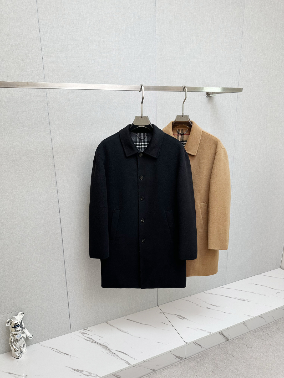 NO:615196,Burberry's 2025 new autumn and winter men's light coat is a contemporary reshaping of the archive genes. Burberry's 2025 autumn and winter men's light coat is inspired by the brand's archive style. It exquisitely integrates century-old British heritage and modern tailoring aesthetics, becoming an iconic item in the autumn and winter wardrobe that combines heritage and style.  In terms of materials and craftsmanship, this Burberry coat shows its ingenuity. Pure wool is selected to create a double-sided wool twill fabric. The texture is fine, tight and drapey, with a warm touch and crisp style. It is refined in an Italian workshop to a high level of craftsmanship.  , allowing every inch of fabric to carry the ultimate pursuit of quality. The unlined design with viscose fiber lining on the sleeves not only retains the natural breathability of wool fabrics, but also ensures smooth wearing and taking off, achieving a perfect balance between lightness and warmth.  The brand's classic code is hidden in the design details. The worsted Burberry plaid lining is a low-key presentation of the iconic element, which cleverly echoes the solid color of the outer layer, revealing the brand's recognition in every gesture. The embedded straight sleeve design outlines neat lines, with matching  It has a slim fit, accurately fits the body shape without restricting movement, and shows the upright posture of an urban elite. The single-row button closure is simple and elegant, the welt side pockets are both practical and beautiful, and the rear slit design adds a flexible layer to the silhouette. The design ingenuity can be seen in every detail.  The use of classic colors is more suitable for diverse scenes, the calm black highlights the low-key texture, and the versatile khaki continues the British classic, which can be easily controlled whether it is daily commuting or weekend travel. This coat blends Burberry's design genes with contemporary needs, making it an ideal choice for settling down the temperament in autumn and winter. Size S-XXL,, burberry, burberry, alexander wang19860909巴宝莉2025秋冬新款男士轻便大衣典藏基因的当代重塑 Burberry 2025秋冬男士轻便大衣,以品牌典藏款式为灵感溯源,将百年英伦底蕴与现代剪裁美学精妙融合,成为秋冬衣橱中兼具传承与格调的标志性单品. 在材质与工艺上,巴宝莉这件大衣尽显匠心.甄选纯羊毛打造双面羊毛斜纹面料,质地细腻紧实且富有垂坠感,触感温润兼具挺括型格,于意大利工坊精制而成的工艺水准,让每一寸面料都承载着对品质的极致追求.无内衬设计搭配衣袖粘胶纤维内衬,既保留了羊毛面料的天然透气性,又确保穿脱顺滑,实现轻盈体感与保暖性的完美平衡. 设计细节中藏着品牌的经典密码.精纺Burberry格纹内里是标志性元素的低调呈现,与外层纯色形成巧妙呼应,举手投足间流露品牌辨识度.嵌入式直袖设计勾勒利落线条,配合修身版型,精准贴合身形却不束缚活动,尽显都市精英的挺拔姿态.单排纽扣开合简约大气,贴边侧袋兼顾实用与美观,后开衩设计则为版型增添灵动层次,细节之处皆见设计巧思. 经典色彩的运用更适配多元场景,沉稳黑色彰显低调质感,百搭卡其色延续英伦经典,无论是日常通勤还是周末出行,都能轻松驾驭.这件大衣将Burberry的设计基因与当代需求相融,成为秋冬季节沉淀气质的理想之选. 码数S-XXL,,burberry,burberry,alexander wang,Men's clothing