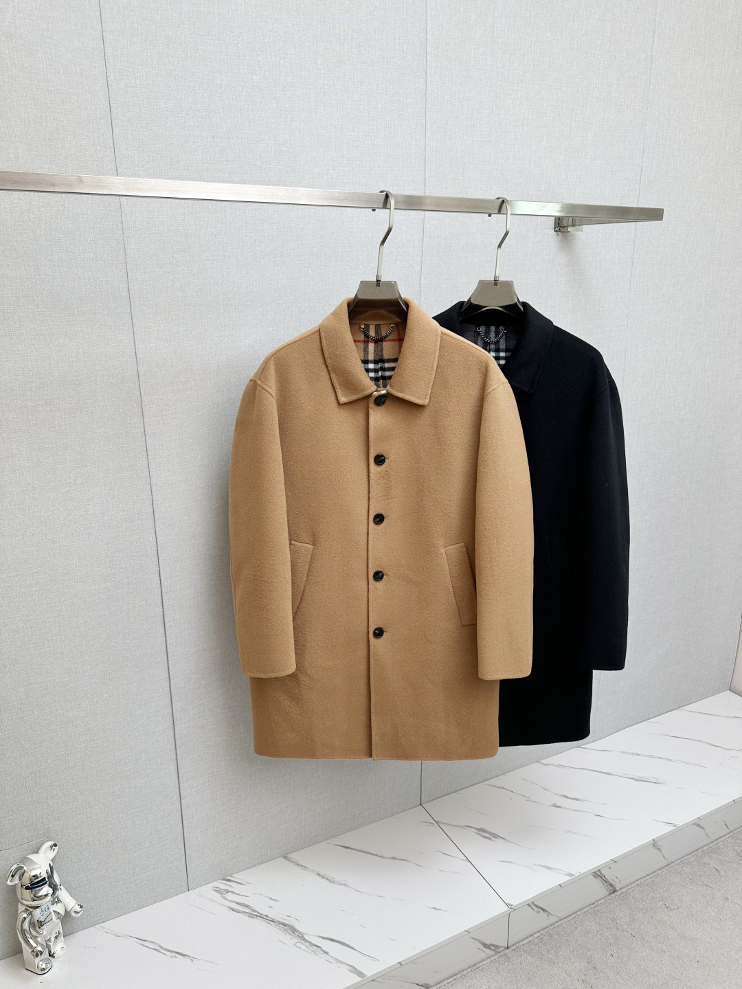 NO:626021,Burberry's 2025 new autumn and winter men's light coat is a contemporary reshaping of the archive genes. Burberry's 2025 autumn and winter men's light coat is inspired by the brand's archive style. It exquisitely integrates century-old British heritage and modern tailoring aesthetics, becoming an iconic item in the autumn and winter wardrobe that combines heritage and style.  In terms of materials and craftsmanship, this Burberry coat shows its ingenuity. Pure wool is selected to create a double-sided wool twill fabric. The texture is fine, tight and drapey, with a warm touch and crisp style. It is refined in an Italian workshop to a high level of craftsmanship.  , allowing every inch of fabric to carry the ultimate pursuit of quality. The unlined design with viscose fiber lining on the sleeves not only retains the natural breathability of wool fabrics, but also ensures smooth wearing and taking off, achieving a perfect balance between lightness and warmth.  The brand's classic code is hidden in the design details. The worsted Burberry plaid lining is a low-key presentation of the iconic element, which cleverly echoes the solid color of the outer layer, revealing the brand's recognition in every gesture. The embedded straight sleeve design outlines neat lines, with matching  It has a slim fit, accurately fits the body shape without restricting movement, and shows the upright posture of an urban elite. The single-row button closure is simple and elegant, the welt side pockets are both practical and beautiful, and the rear slit design adds a flexible layer to the silhouette. The design ingenuity can be seen in every detail.  The use of classic colors is more suitable for diverse scenes, the calm black highlights the low-key texture, and the versatile khaki continues the British classic, which can be easily controlled whether it is daily commuting or weekend travel. This coat blends Burberry's design genes with contemporary needs, making it an ideal choice for settling down the temperament in autumn and winter. Size S-XXL,, burberry, burberry, alexander wang19860909巴宝莉2025秋冬新款男士轻便大衣典藏基因的当代重塑 Burberry 2025秋冬男士轻便大衣,以品牌典藏款式为灵感溯源,将百年英伦底蕴与现代剪裁美学精妙融合,成为秋冬衣橱中兼具传承与格调的标志性单品. 在材质与工艺上,巴宝莉这件大衣尽显匠心.甄选纯羊毛打造双面羊毛斜纹面料,质地细腻紧实且富有垂坠感,触感温润兼具挺括型格,于意大利工坊精制而成的工艺水准,让每一寸面料都承载着对品质的极致追求.无内衬设计搭配衣袖粘胶纤维内衬,既保留了羊毛面料的天然透气性,又确保穿脱顺滑,实现轻盈体感与保暖性的完美平衡. 设计细节中藏着品牌的经典密码.精纺Burberry格纹内里是标志性元素的低调呈现,与外层纯色形成巧妙呼应,举手投足间流露品牌辨识度.嵌入式直袖设计勾勒利落线条,配合修身版型,精准贴合身形却不束缚活动,尽显都市精英的挺拔姿态.单排纽扣开合简约大气,贴边侧袋兼顾实用与美观,后开衩设计则为版型增添灵动层次,细节之处皆见设计巧思. 经典色彩的运用更适配多元场景,沉稳黑色彰显低调质感,百搭卡其色延续英伦经典,无论是日常通勤还是周末出行,都能轻松驾驭.这件大衣将Burberry的设计基因与当代需求相融,成为秋冬季节沉淀气质的理想之选. 码数S-XXL,,burberry,burberry,alexander wang,Men's clothing