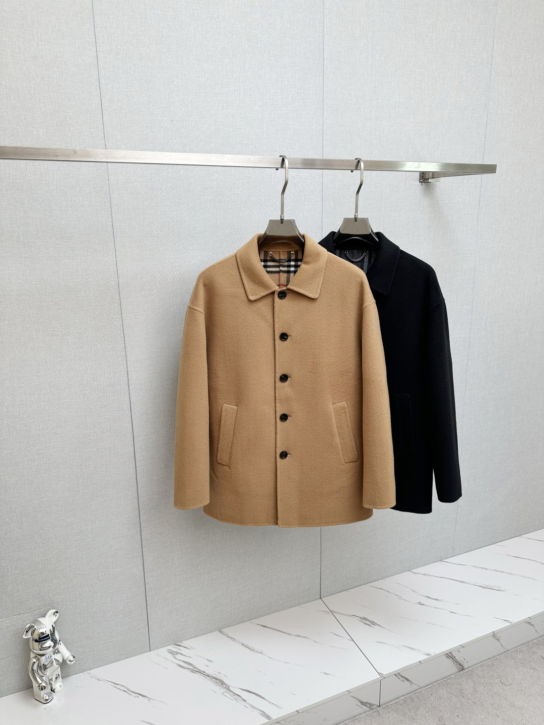 NO:626029,Burberry 2025 Autumn and Winter Men's Mid-Length Lightweight Wool Coat Collection is Reborn and Style is Inherited. Inheriting the design genes of the brand's archived coats for more than 165 years, Burberry 2025 Autumn and Winter Men's Mid-Length Lightweight Wool Coat was born. With classics as its bones and craftsmanship as its soul, it reinterprets the contemporary expression of British style.  Inspired by the timeless designs in the brand's archives, this coat is carefully crafted from double-sided wool twill fabric. The pure wool outer layer has a soft touch and a crisp fit. It adapts to the changing climate of autumn and winter and continues the brand's persistent pursuit of high-quality fabrics. Each piece is crafted in an Italian workshop, from fabric cutting to detail stitching, all demonstrating the rigor and sophistication of European craftsmanship.  The design cleverly balances classic and modern worsted Burberry classic plaid with the brand logo hidden inside, continuing the collection element that has become a brand symbol since the 19th generation; the embedded straight sleeves and dropped shoulders design breaks the traditional constraints, while modifying the body shape while retaining freedom of movement, ultimately presenting a neat and slim fit.  Style. The button closure is simple and neat, the welted side pockets are both practical and aesthetic, the back slit design adds a sense of dynamic agility, and the unlined structure gives the item a light wearing experience and is suitable for layering needs in multiple scenes. The sleeve lining is made of viscose fiber, with textured horn buttons, showing exquisite details in every detail.  This time, two colors are launched, classic black and khaki. Black is calm and atmospheric, suitable for business occasions, while khaki is warm and restrained, echoing the British heritage, and can easily handle the diverse dressing needs from daily commuting to social occasions. Burberry 2025 autumn and winter men's mid-length lightweight wool coat collides with contemporary design with archive inspiration, and uses craftsmanship to protect the style, making it a classic in the autumn and winter wardrobe. Size S-XXL,,burberry,jackets & coats,alexander wang19860909Burberry 2025秋冬男士中长款轻便羊毛大衣典藏新生,格调传承 承袭品牌165余年典藏外套的设计基因,Burberry 2025秋冬男士中长款轻便羊毛大衣应运而生,以经典为骨、匠艺为魂,重释英伦格调的当代表达. 灵感源自品牌典藏档案中的隽永设计,这款大衣选用双面羊毛斜纹面料精心打造,纯羊毛外层兼具柔软触感与挺括版型,适配秋冬多变气候的同时,延续了品牌对高品质面料的执着追求.每一件均于意大利工坊精制而成,从面料剪裁到细节缝合,无不彰显欧洲匠艺的严谨与考究. 设计上巧妙平衡经典与摩登精纺Burberry经典格纹内里暗藏品牌标识,延续自19代便成为品牌符号的典藏元素；嵌入式直袖落肩设计打破传统束缚,在修饰身形的同时保留活动自由度,最终呈现利落修身版型.纽扣开合简约利落,贴边侧袋兼顾实用与美学,后开衩设计增添动态灵动感,而无内衬结构则赋予单品轻盈穿着体验,适配多场景叠搭需求.衣袖内衬采用粘胶纤维,搭配质感牛角纽扣,于细节处尽显精致. 本次推出经典黑色与卡其色两款配色,黑色沉稳大气适配商务场合,卡其色温润内敛呼应英伦底蕴,轻松驾驭从日常通勤到社交场合的多元穿搭需求. Burberry 2025秋冬男士中长款轻便羊毛大衣,以典藏灵感碰撞当代设计,用匠艺守护格调,成为秋冬衣橱中的经典之作. 码数S-XXL,,burberry,jackets & coats,alexander wang,Men's clothing