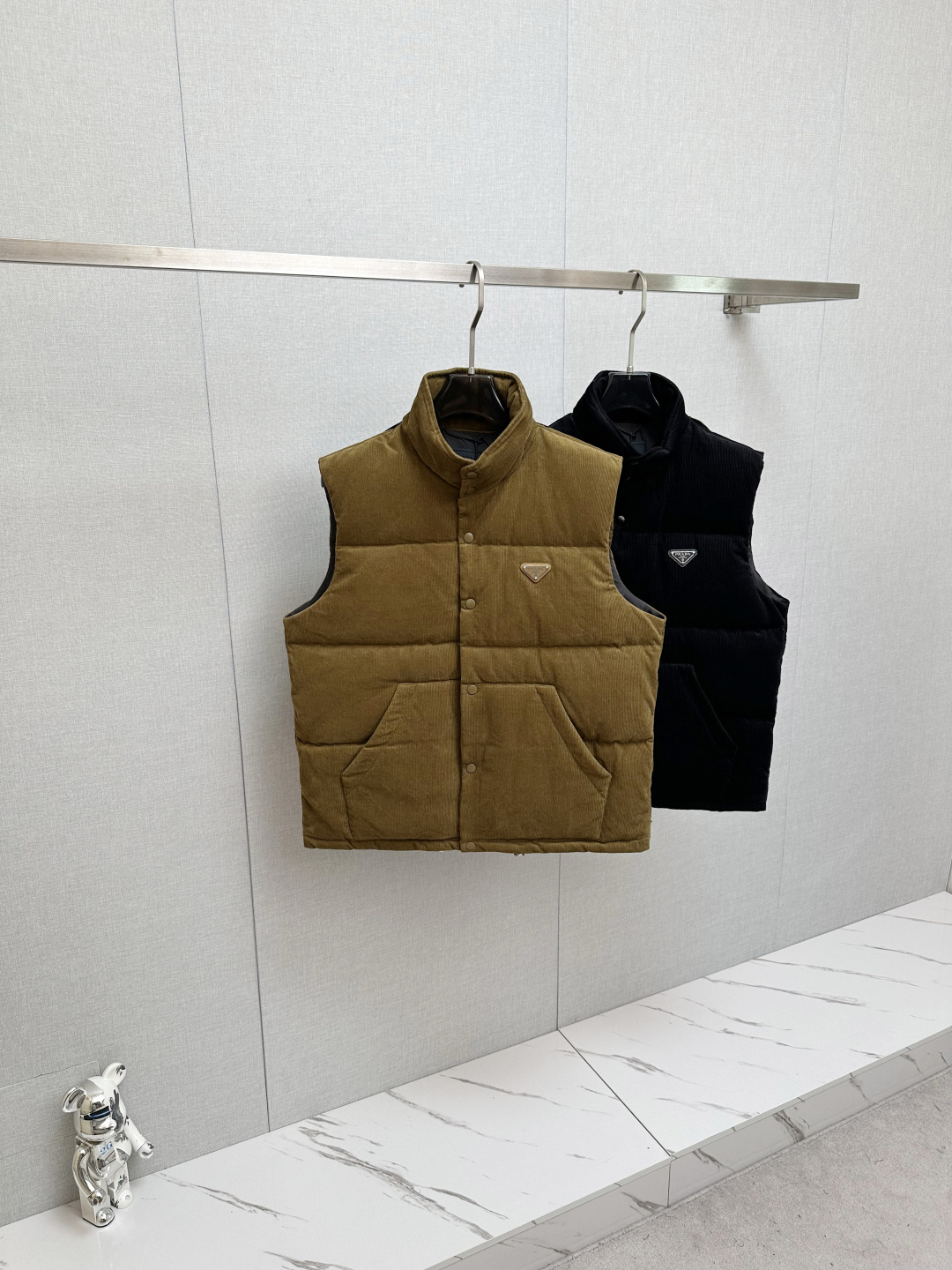 NO:657927,Prada 25FW This triangular logo is made of genuine leather, and the triangular logo hardware logo Prada letters are polished by hand to have no uneven feeling, just like ZP. There are three pockets inside. There is an invisible hat behind the collar, all the details are the same as ZP. It comes with an exclusive dust bag. Please pay attention to the details for the higher version. New autumn and winter corduroy stand-up collar warm down vest!  The classic triangular logo vest is the same for both men and women. The corduroy fabric is really soft. It is definitely a highlight of autumn and winter wear. It is a fashionable tool for autumn and winter that can be worn by both men and women. For this kind of classic that is not easy to go out of style, fashionable men and women can buy it with confidence. It is definitely the best choice as a daily commuting item!  This down vest is made of custom-woven corduroy material supplied by customers. The surface of the fabric has three-dimensional and warm groove details, which visually brings a retro and nostalgic tone. It has a bit of 70s feel mixed in, giving people a lazy and relaxing feeling!  The delicate and smooth fiber lining inside is filled with 90% white goose down. It has sufficient down filling and is free of stems and clumps. It has a full and soft down texture. It rebounds instantly when pressed. It can effectively lock in and gather body temperature, bringing you the warmest and most comfortable wearing experience!  The basic and conventional stand-up collar vest style cutting, simple and neat design, can easily create a fashionable and elegant casual look!  Size S-XL,,prada,down jacket,hats,alexander wang19860909Prada 25FW 此款三角标采用真皮、三角标五金logo Prada字母采用磨平工艺用手抚摸无凹凸感和ZP一样.内里设有三个口袋. 领口后方设有隐形帽子、所有细节和ZP一样. 配专属防尘袋.高版本请认准细节.秋冬新款灯芯绒立领保暖羽绒马甲！男女同款经典三角标马甲,灯芯绒面料真的好温柔哦,绝对是秋冬穿搭的一大亮点～ 男女通穿的秋冬时尚着装利器,对于这种不易过时的经典之作,各位潮男潮女们可以放心入手,作为日常通勤单品搭配绝对是最佳的选择！ 此款羽绒背心甄选客供定织灯芯绒材质制作而成,面料表面立体温润的坑条细节,视觉上自带复古怀旧腔调,骨子里混了些许70年代的feel,给人慵懒放松的感觉！内里细腻爽滑的纤维内衬,搭配90白鹅绒填充,充绒量足且无梗不结块,饱满柔软的羽绒质感,按压下去瞬间回弹,着身可以有效的锁温聚温,带来最保暖舒适的着穿体验！基础常规的立领马甲版型裁剪,简洁利落的设计,可轻松打造时尚大气的休闲造型！ 尺码S-XL,,prada,down jacket,hats,alexander wang,Men's clothing