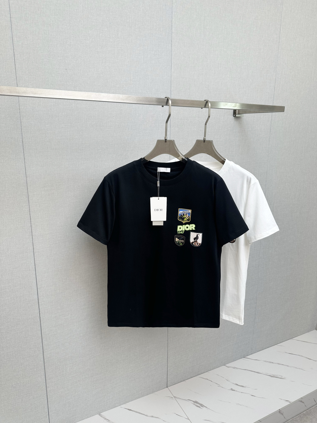 NO:655773,Dior embroidered patch short-sleeved T-shirt. This Dior Mountain T-shirt is a new product in the 2026 spring series. It is decorated with multi-color patches to show the mountain spirit and the classic Dior haute couture style logo inspired by the Dior archives. It is carefully made of white cotton jersey fabric and has a round neck design that can be matched with the series to create a sophisticated look. Sizes S-2XL,, dior, T-shirt, tees, t-shirt, alexander wang19860909Dior 刺绣补丁短袖T恤,这款 Dior Mountain T 恤是二零二六春季系列新品,饰以多色补丁,展现高山精神和灵感源自Dior档案的Dior高订风格经典标识.采用白色棉质平纹针织面料精心制作,圆领设计,可与该系列的搭配,打造精致的造型.尺码S-2XL,,dior,T-shirt,tees，t-shirt,alexander wang,Men's clothing