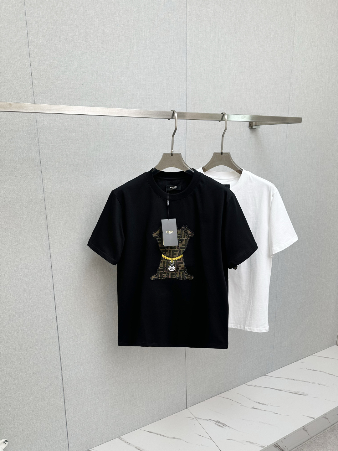 NO:727687,Support Fendi. Fendi SS26 new spring and summer new cute pet short-sleeved T-shirts. The presbyopic puppy pattern on the front chest is trendy and cute. The gold chain details directly add a sense of sophistication. It can be worn whether it is for daily outings or light business occasions. This new wave of new styles is easy to use with your eyes closed. The upper body is comfortable and breathable, with high-quality fabrics; color black, white, size S-2XL,,fendi,fendi, T-shirt, tees, t-shirt,19860909支持年后Fendi.芬迪 SS26春夏新品萌趣宠物短袖T恤,正面胸口的老花小狗图案又潮又萌,金链子细节直接把精致感拉满,不管是日常出街还是轻商务场合都能搭,这波新款闭眼冲不踩雷,上身舒适透气、高品质面料； 颜色黑色、白色、 码数S-2XL,,fendi,fendi,T-shirt,tees，t-shirt,,Men's clothing