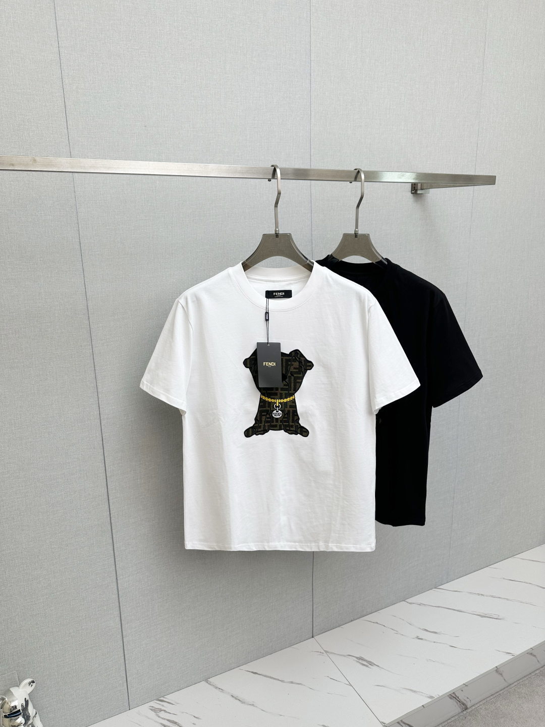 NO:745390,Fendi. Fendi SS26 new spring and summer new cute pet short-sleeved T-shirt. The presbyopic puppy pattern on the front chest is trendy and cute. The gold chain details directly add a sense of sophistication. It can be worn whether it is for daily outings or light business occasions. This new wave of new styles can be worn with your eyes closed. The upper body is comfortable and breathable, with high-quality fabrics; color black, white, size S-2XL,,fendi,fendi,T-shirt,tees,t-shirt,19860909Fendi.芬迪 SS26春夏新品萌趣宠物短袖T恤,正面胸口的老花小狗图案又潮又萌,金链子细节直接把精致感拉满,不管是日常出街还是轻商务场合都能搭,这波新款闭眼冲不踩雷,上身舒适透气、高品质面料； 颜色黑色、白色、 码数S-2XL,,fendi,fendi,T-shirt,tees，t-shirt,,Men's clothing