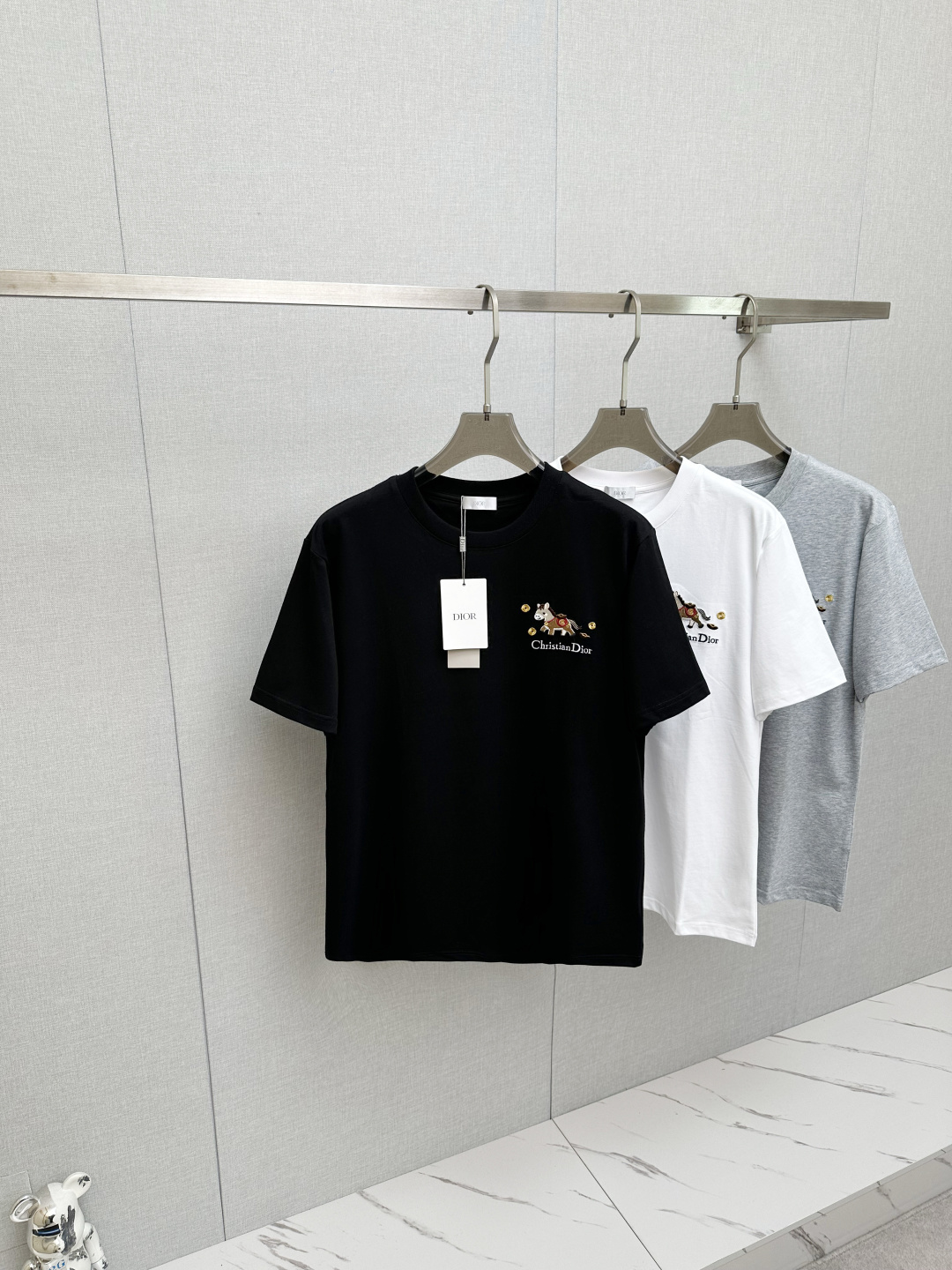 NO:758685,Dior* Dior embroidered pony short-sleeved T-shirt The Dior limited edition that catches your eye at first glance is here! The three-dimensional embroidered pony on the chest is cute and eye-catching, full of details~ Paired with the classic 'Dior' letter embroidery, the sophistication is directly stunning! The custom-made fabric is crisp and stylish, not soft, and it is not easy to deform after washing~ It is skin-friendly and breathable while having a sense of texture. The upper body is slightly loose and casual, and can be easily held during daily commuting/outing! Same style for men and women, white  Gray black S-XXl,,dior,dior,T-shirt,tees,t-shirt,19860909Dior*迪奥 刺绣小马短袖T恤 一眼心动的Dior限定款来啦!'胸前立体刺绣小马萌趣吸睛,细节感拉满~搭配经典'Dior'字母刺绣,精致度直接封神!定制面料挺括有型不软塌,洗后也不易变形~亲肤透气的同时自带肌理感,上身微宽松版型慵懒随性,日常通勤/出街都能轻松hold住!男女同款 白色 灰色 黑色 S-XXl,,dior,dior,T-shirt,tees，t-shirt,,Men's clothing