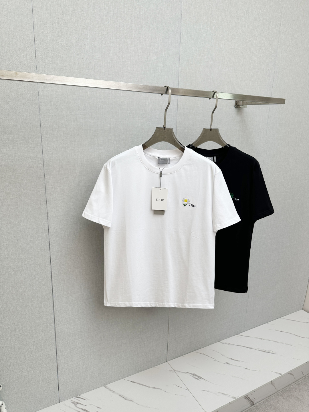 NO:761583,Dior 2026ss round neck four-leaf clover embroidered graphic T-shirt  ●Description: This black short-sleeved T-shirt is made of high-count double-ply combed cotton blend fabric. The neckline is made of high-elastic ribbing with three-needle hemming technology. It is not easy to loosen and curl after repeated wear. The side seams of the body are made of double-needle embedded clip technology, which ensures smooth and firm routing and reduces skin friction. The green clover pattern distributed on the body is made of precision.  Embroidery technology, the stitches are fine and even, the pattern is three-dimensional and full and not easy to get off-line; the ready-made garments undergo multiple quality inspection processes such as stitching, ironing, and decontamination. The version is loose and moderate, suitable for daily leisure, dating and travel and other scenarios, with both exquisite details and practical wearability. The overall wiring is straight and delicate, the fabric is comfortable and soft, and the colors are consistent without color difference.  It can be matched with the same style to create a fashionable look, and can be used in various occasions. Customized accessories, complete with three standards, same style for men and women!  Size S-2XL,,dior,T-shirt,tees,t-shirt,19860909Dior 2026ss圆领四叶草刺绣图案T恤 ●描述这款黑色短袖T恤采用高支双股精梳棉混纺面料,领口采用高弹力罗纹搭配三本针包边工艺,反复穿着不易松弛卷边；衣身侧缝采用双针埋夹工艺,走线平整牢固,减少皮肤摩擦感.衣身分布的绿色三叶草图案采用精密刺绣工艺,针脚细密均匀,图案立体饱满且不易脱线；成衣经针、整烫、去污等多道质检工序,版型宽松有度,适配日常休闲、约会出游等多种场景,兼具精致细节与实穿性.整体走线平直细腻,面料舒适柔软,颜色一致无色差 能与同款搭配营造时尚造型,驾驭各种场合,定制辅料,三标齐全,男女同款！ 尺码S-2XL,,dior,T-shirt,tees，t-shirt,,Men's clothing