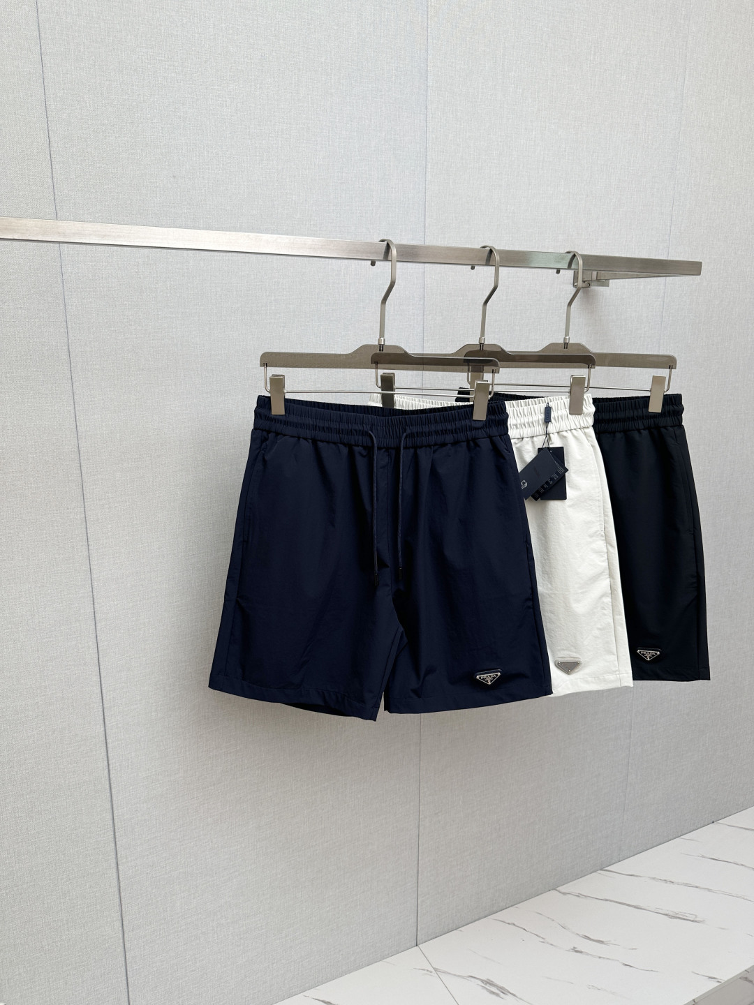 NO:834575,PRAD 26 spring and summer shorts This style is a series that combines fashion, leisure and sports, highlighting innovation, design and functionality. This series debuted in 1997 and stands out with its versatile and high-functional design, integrating contemporary aesthetic concepts and advanced technology. The fabrics are imported from South Korea, and the order cycle is as high as 90 days. The process uses imported rubber strips, which are hot-pressed at a temperature of 160 degrees. The firmness is stable, the national standard test is met, and it is not easy to be damaged.  The classic red tape will never go out of style. It is sold in Hong Kong counters. The pockets are cleverly designed and are both practical and decorative. The style is suitable for a wide range of occasions. The style shows clean body lines. The right length takes into account the comfort needs of different people. It is suitable for summer outdoor sports and office wear. The details are full of ingenuity and reflect Pra's exquisite craftsmanship. Size M-3XL, prada, shorts,19860909PRAD 26春夏短裤款 此款是一个融合时尚休闲与运动的系列,彰显创新性、设计感与功能性.该系列于1997年首度亮相,以百搭的高功能设计脱颖而出,融合当代美学理念与先进技术, 面料采用韩国进口面料,订货周期高达90天. 工艺采用进口胶条,温度达160度热压,牢固性稳定,国标测试达标,不易破损. 经典红胶条永不过时,香港专柜在售,口袋的设计巧妙,兼具实用性与装饰性.穿着版型适应场合范围广,版型展现干净利落的身形线条,恰到好处的长度更是考虑到不同人群的舒适需求,适合夏季户外运动和办公室穿搭,细节之处尽显匠心,无不体现Pra的精湛工艺 码数M-3XL,,prada,shorts,,Men's clothing