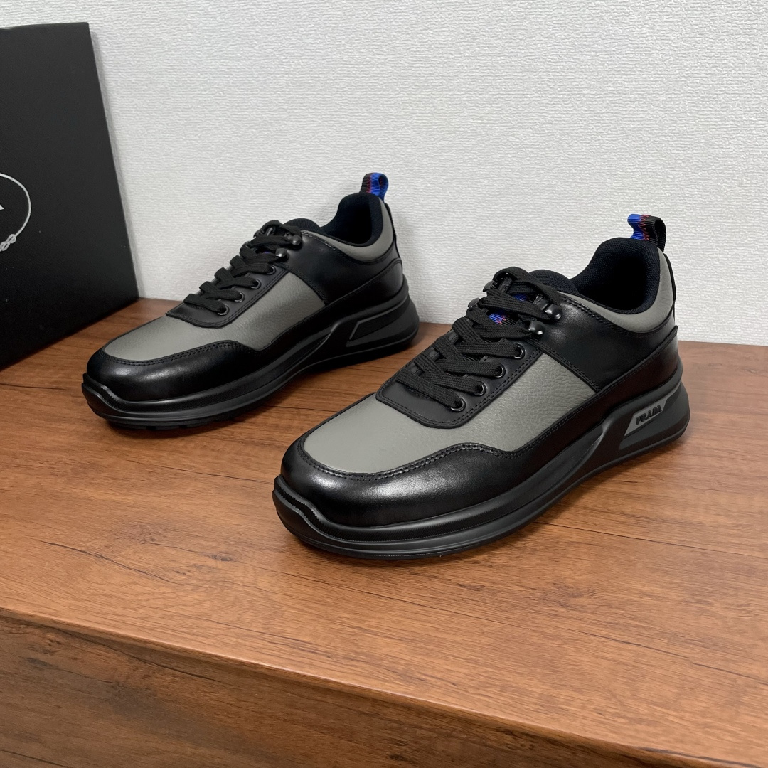 NO:353225,Code Prada/Prada New Leather Casual Sports Shoes for Men This sneaker is made of smooth calf leather and a slapped cowhide upper, modern and simple style, comfortable and breathable, practical and versatile, equipped with all-metal enamel eye-coated cotton laces, and the tongue is decorated with contrasting webbing, which echoes the heel lifting tab. It is paired with 4cm lightweight elevated rubber sole, with Prada logo details on the outside, fabric breathable inner lining, brand logo cowhide footbed, creating a comfortable wearing experience. It is equipped with a full set of original packaging dust bags!  Size 39-40-41-42-43-44 Standard leather shoe size Article number 2EE913 slashed leather black gray, prada, prada, sneakers, cowhide19860909编码 Prada/普拉达 男士新款皮革休闲运动鞋 这款运动鞋采用光滑小牛皮革和摔纹牛皮鞋面,现代简约风格,舒适透气,实用百搭,配以全金属珐琅鞋眼棉鞋带,鞋舌饰以撞色织带,与后跟鞋提拉袢相呼应,搭配4cm轻便的凸纹橡胶鞋底,外侧饰有Prada徽标细节,织物透气内里,品牌徽标牛皮垫脚,缔造舒适的穿着体验.配全套原包装防尘袋！ 码数39-40-41-42-43-44 标准皮鞋尺码 货号2EE913摔纹皮 黑灰,,prada,prada,sneakers,cowhide,Men's shoes