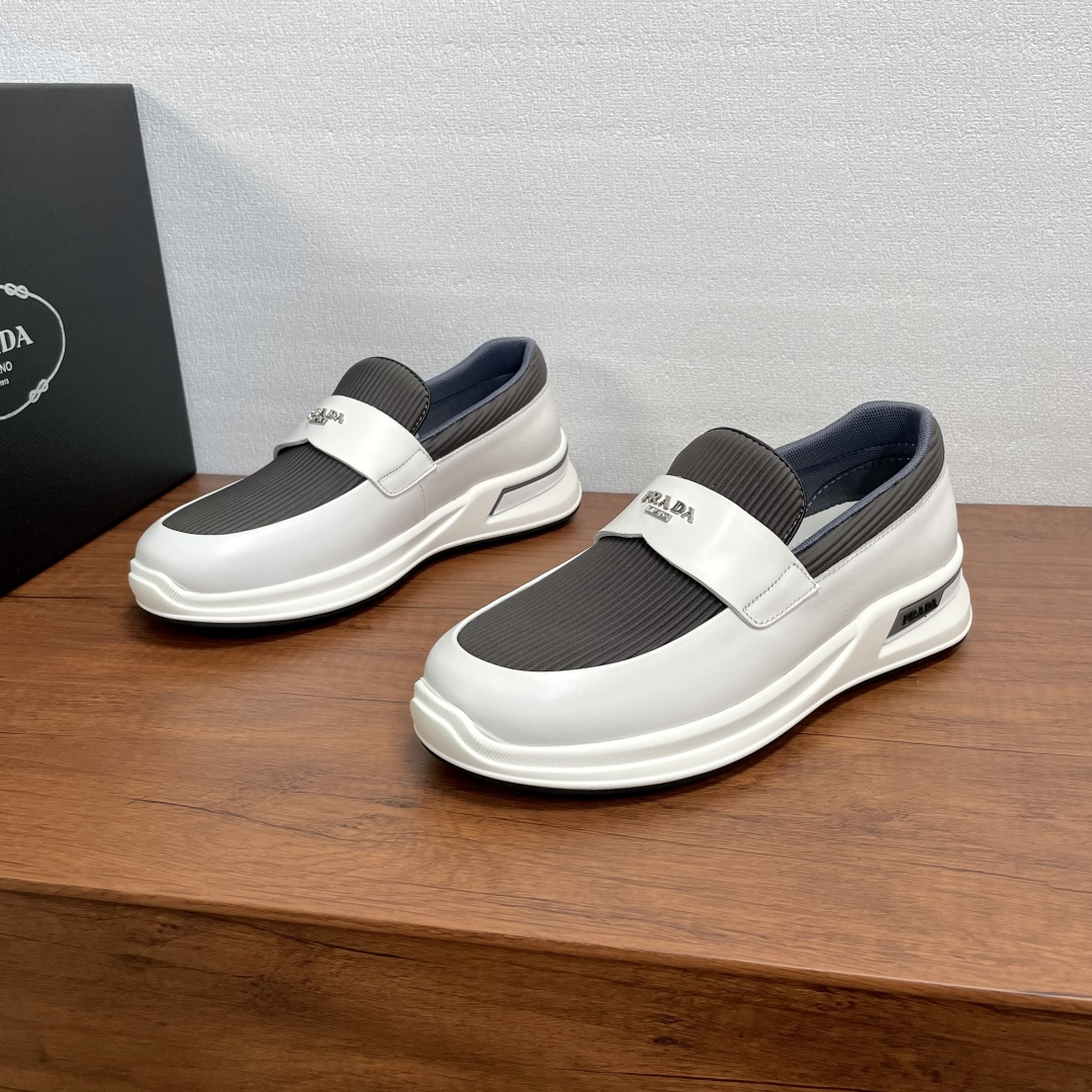 NO:347602,Code Prada/Prada Men's new one-legged lazy casual shoes This sneaker uses smooth calf leather and nylon fabric spliced ​​upper, wavy fabric details, one-legged loafer upper, modern and simple style, comfortable and breathable, practical and versatile. Calfskin horizontal band is matched with metal logo letter logo, matched with 3cm elevated rubber sole, decorated with Prada logo details, fabric breathable inner, brand logo cowhide foot pads, creating a comfortable wearing experience. Comes with a full set of original packaging dust bags!  Size 39-40-41-42-43-44 Standard leather shoe size Article number 2EE915 Gray cloth, Prada, Prada, Loafers, Sneakers, cowhide19860909编码 Prada/普拉达 男士新款一脚蹬懒人休闲鞋 这款运动鞋采用光滑小牛皮革和尼龙织物拼接鞋面,波浪型布面细节,一脚蹬乐福鞋鞋面,现代简约风格,舒适透气,实用百搭,小牛皮横饰带配以金属logo字母标识,搭配3cm凸纹橡胶鞋底,饰有Prada徽标细节,织物透气内里,品牌徽标牛皮垫脚,缔造舒适的穿着体验.配全套原包装防尘袋！ 码数39-40-41-42-43-44 标准皮鞋尺码 货号2EE915 灰布,,prada,prada,loafers,sneakers,cowhide,Men's shoes