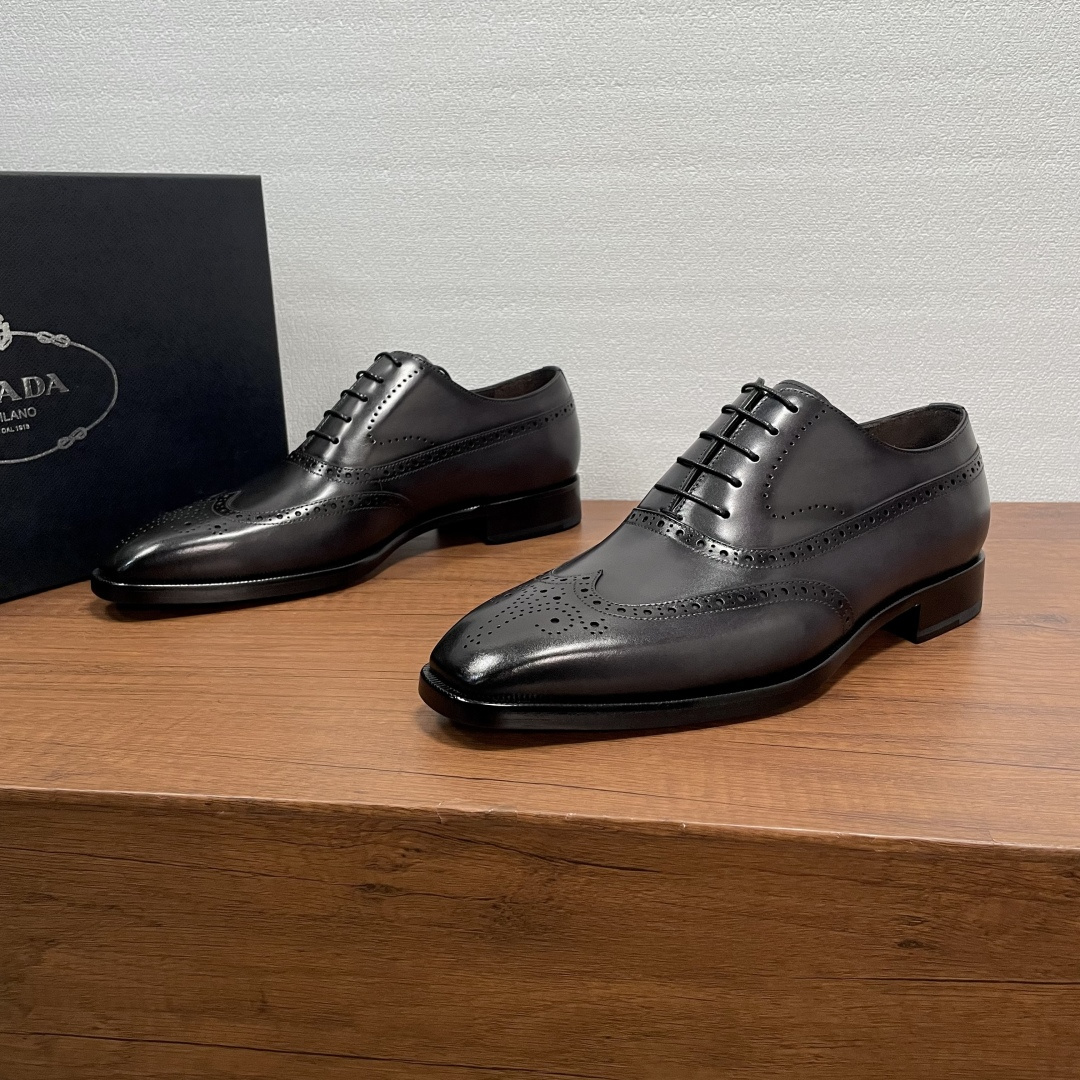 NO:704932,Prada Men's New Business Oxford Shoes  This Oxford shoe is made of imported calf leather, classic brogue carved upper, pure hand-rubbing process, Oxford shoe style with waxed laces, semi-Goodyear hand-made cold bonding process, with genuine leather outsole, anti-slip rubber patch on the back sole, soft  Calfskin lining, gold-labeled cowhide feet, and a round and comfortable silhouette, which can be easily adapted to various occasions. Whether it is adding a relaxed atmosphere to formal wear or adding style to weekend casual looks, it can be handled with ease. Comes with a full set of original packaging!  Code number 39-40-41-42-43-44 Standard leather shoe code Item number 2DA001 Carved black and gray, prada, cowhide, Leather soles19860909Prada 男士新款商务正装牛津鞋 这款牛津鞋采用进口小牛皮胚面,经典布洛克雕花鞋面,纯手工擦色工艺,牛津鞋款式配打蜡系带,半固特异手工冷粘工艺,配以真皮大底,后掌橡胶贴片防滑设计,柔软小牛皮内里,金标牛皮垫脚,圆润舒适的廓形,可游刃有余地应对各种场合,无论是为正装增添轻松气息,还是为周末休闲造型增添格调,皆能从容应对.配全套原包装！ 码数39-40-41-42-43-44 标准皮鞋码 货号2DA001雕花 黑灰,,prada,cowhide,Leather soles,Men's shoes