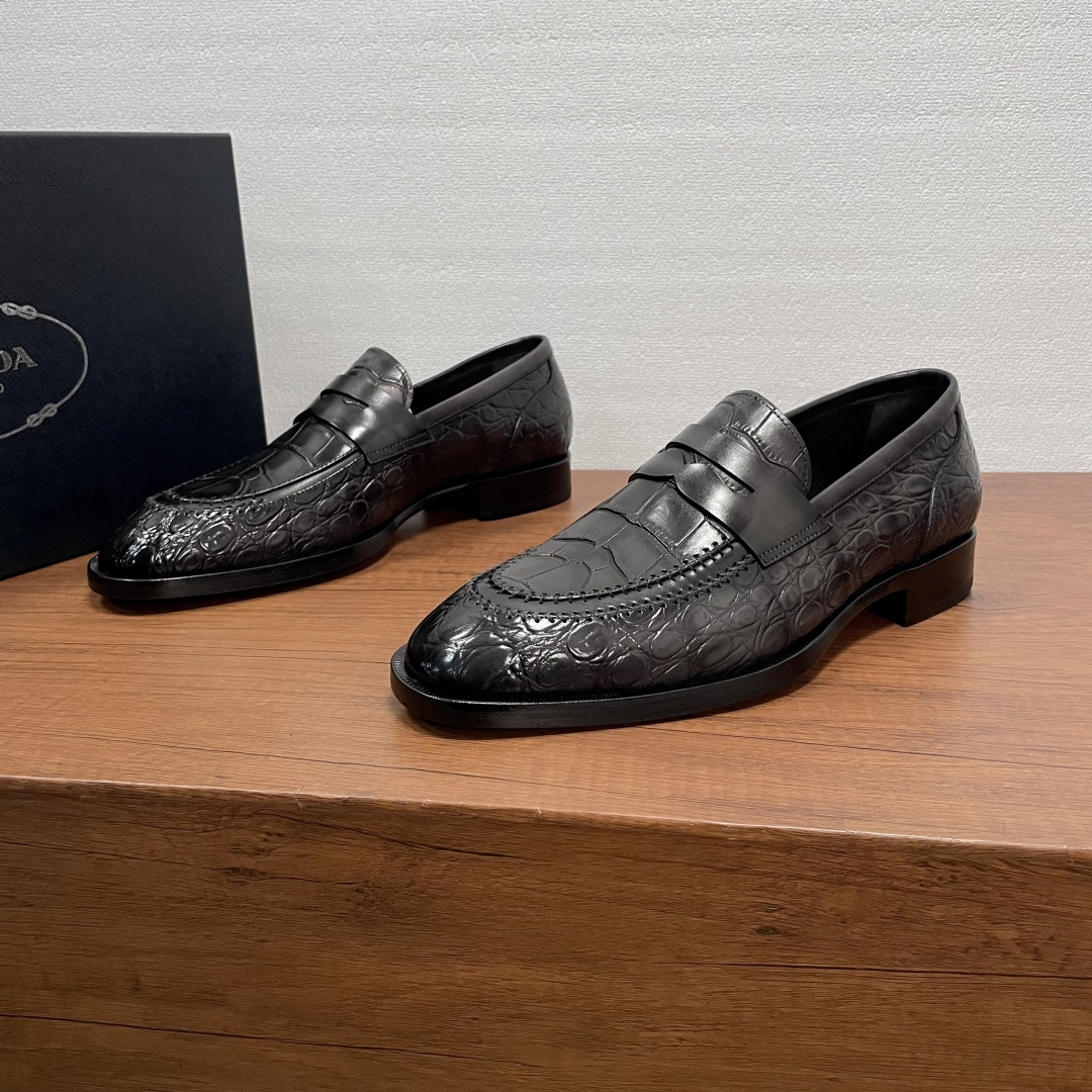 NO:704947,Prada men's new crocodile pattern loafers  This loafer is made of imported calfskin, crocodile embossed effect upper, pure hand-rubbing process, classic penny loafer style, semi-Goodyear hand-made cold bonding process, with piano-style leather outsole, anti-slip rubber patch on the back sole, soft  Calfskin lining, gold-labeled cowhide feet, and a round and comfortable silhouette, which can be easily adapted to various occasions. Whether it is adding a relaxed atmosphere to formal wear or adding style to weekend casual looks, it can be handled with ease. Comes with a full set of original packaging!  Code number 39-40-41-42-43-44 Standard leather shoe code Item number D6391 crocodile pattern black and gray, prada, loafers, cowhide, Leather soles19860909Prada 男士新款鳄鱼纹乐福鞋 这款乐福鞋采用进口小牛皮胚面,鳄鱼压纹效果鞋面,纯手工擦色工艺,经典便士乐福鞋款,半固特异手工冷粘工艺,配以钢琴式真皮大底,后掌橡胶贴片防滑设计,柔软小牛皮内里,金标牛皮垫脚,圆润舒适的廓形,可游刃有余地应对各种场合,无论是为正装增添轻松气息,还是为周末休闲造型增添格调,皆能从容应对.配全套原包装！ 码数39-40-41-42-43-44 标准皮鞋码 货号D6391鳄鱼纹 黑灰,,prada,loafers,cowhide,Leather soles,Men's shoes