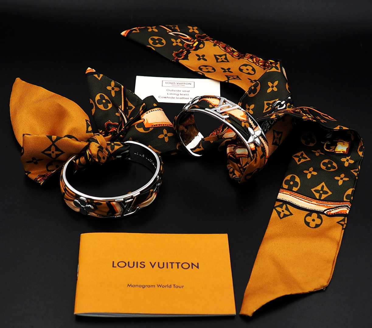 驴家新款LVInitiales Silk 手镯凝聚金属的闪耀光泽与丝带的华美质感，为精雕细琢的圈环融入M