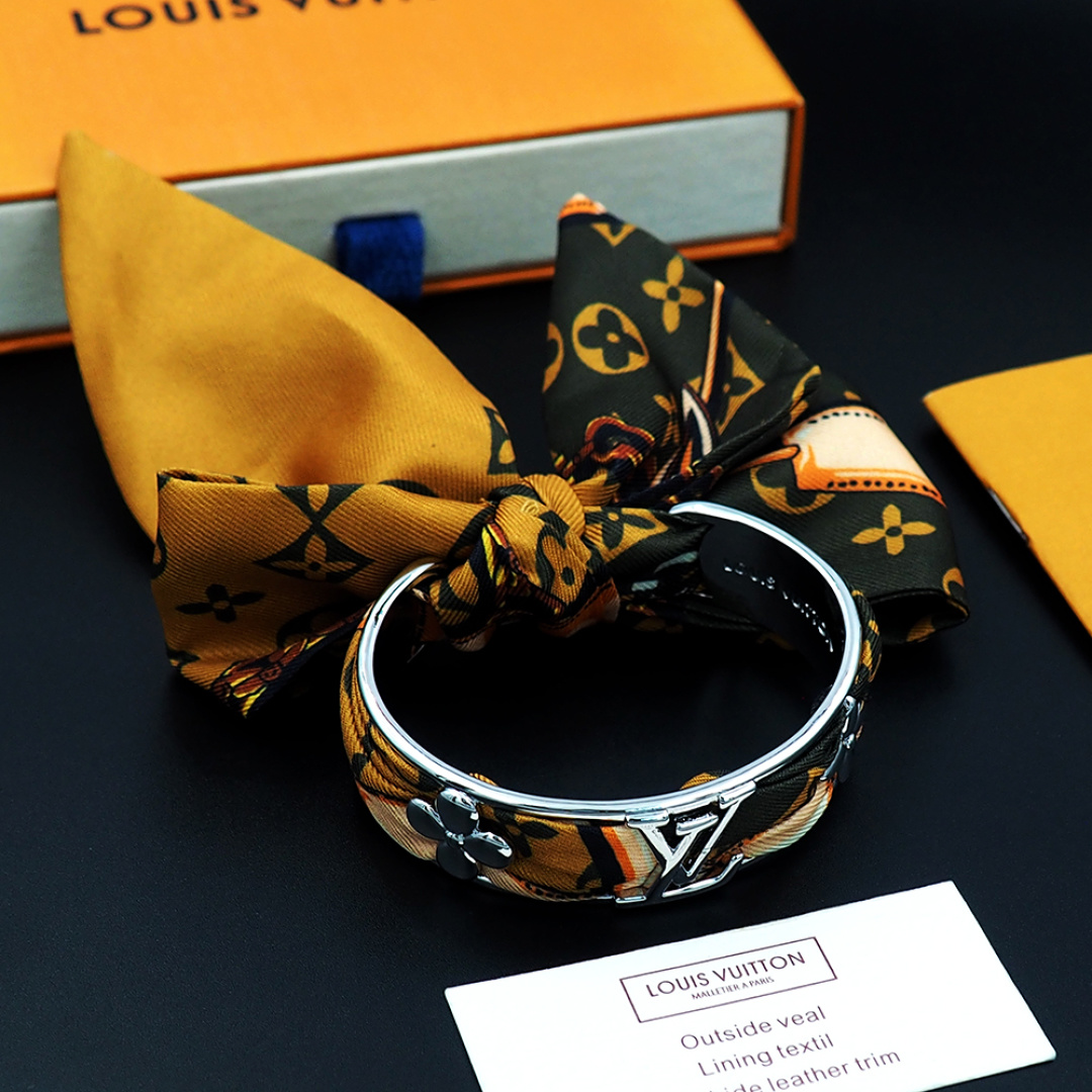 驴家新款LVInitiales Silk 手镯凝聚金属的闪耀光泽与丝带的华美质感，为精雕细琢的圈环融入M