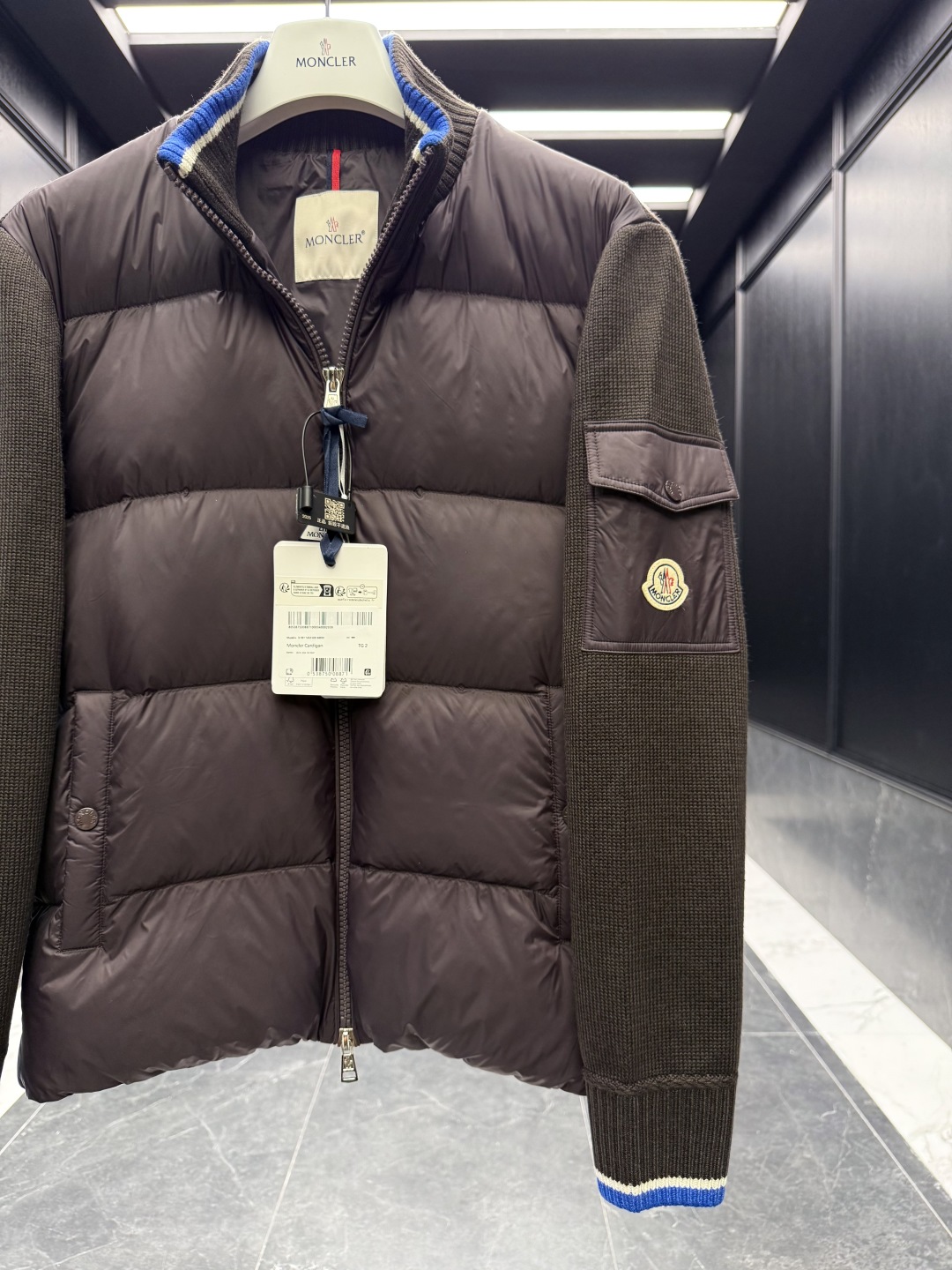 L-4XL（对应1-5码） P320 monzz05
特级羽绒⬆️Moncler Cardigan男士羽绒加衬羊毛和羊绒拉链开衫. 这款男士加衬开衫采用华贵的羊毛和羊绒混纺面料制成，可在温暖时节作为外套穿着。
🎁包装再度升级（可加配原版超大折叠磁吸礼盒)
这款开衫采用羊毛和羊绒面料制成，填充温暖羽绒。拉链廓形设计，针织高领增添额外保护，可抵御恶劣天气。轻盈针织单品，点缀柔软的皮革饰边。
详情
采用羊毛和羊绒混纺面料制成
•Micro chic尼龙衬里
•羽绒填充正面
•双面针织
•12针
•拉链开合
•拉链口袋
•羊毛毡贴片logo
Size: 1-5. 黑色/深棕色
 D00680