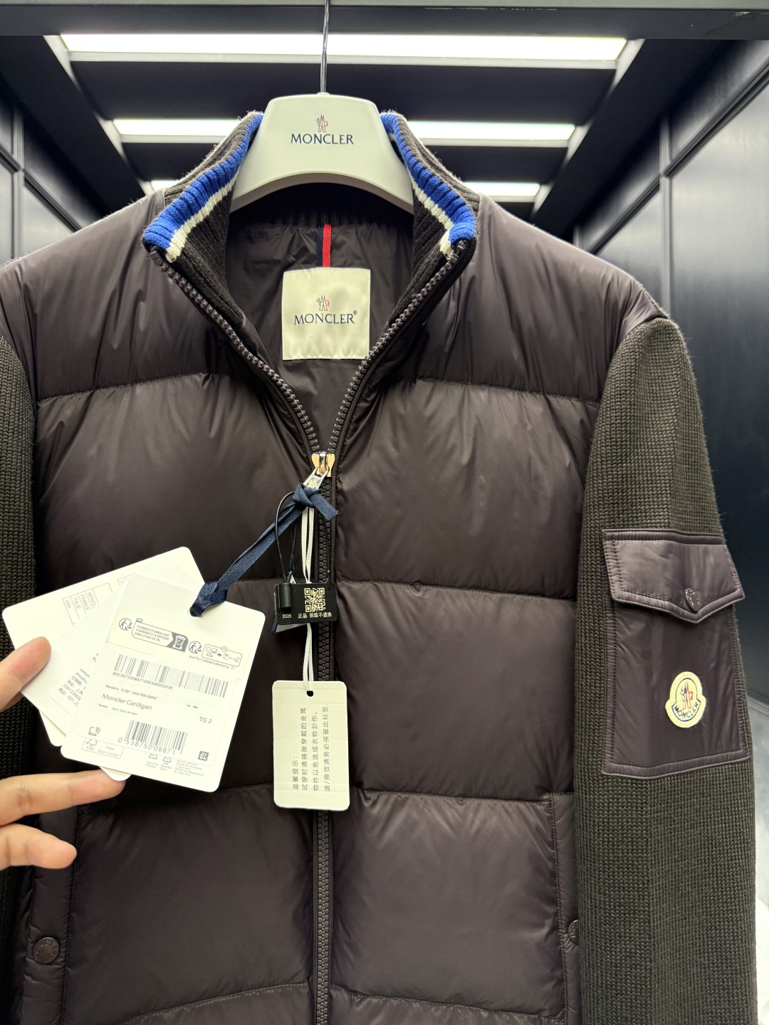 L-4XL（对应1-5码） P320 monzz05
特级羽绒⬆️Moncler Cardigan男士羽绒加衬羊毛和羊绒拉链开衫. 这款男士加衬开衫采用华贵的羊毛和羊绒混纺面料制成，可在温暖时节作为外套穿着。
🎁包装再度升级（可加配原版超大折叠磁吸礼盒)
这款开衫采用羊毛和羊绒面料制成，填充温暖羽绒。拉链廓形设计，针织高领增添额外保护，可抵御恶劣天气。轻盈针织单品，点缀柔软的皮革饰边。
详情
采用羊毛和羊绒混纺面料制成
•Micro chic尼龙衬里
•羽绒填充正面
•双面针织
•12针
•拉链开合
•拉链口袋
•羊毛毡贴片logo
Size: 1-5. 黑色/深棕色
 D00680