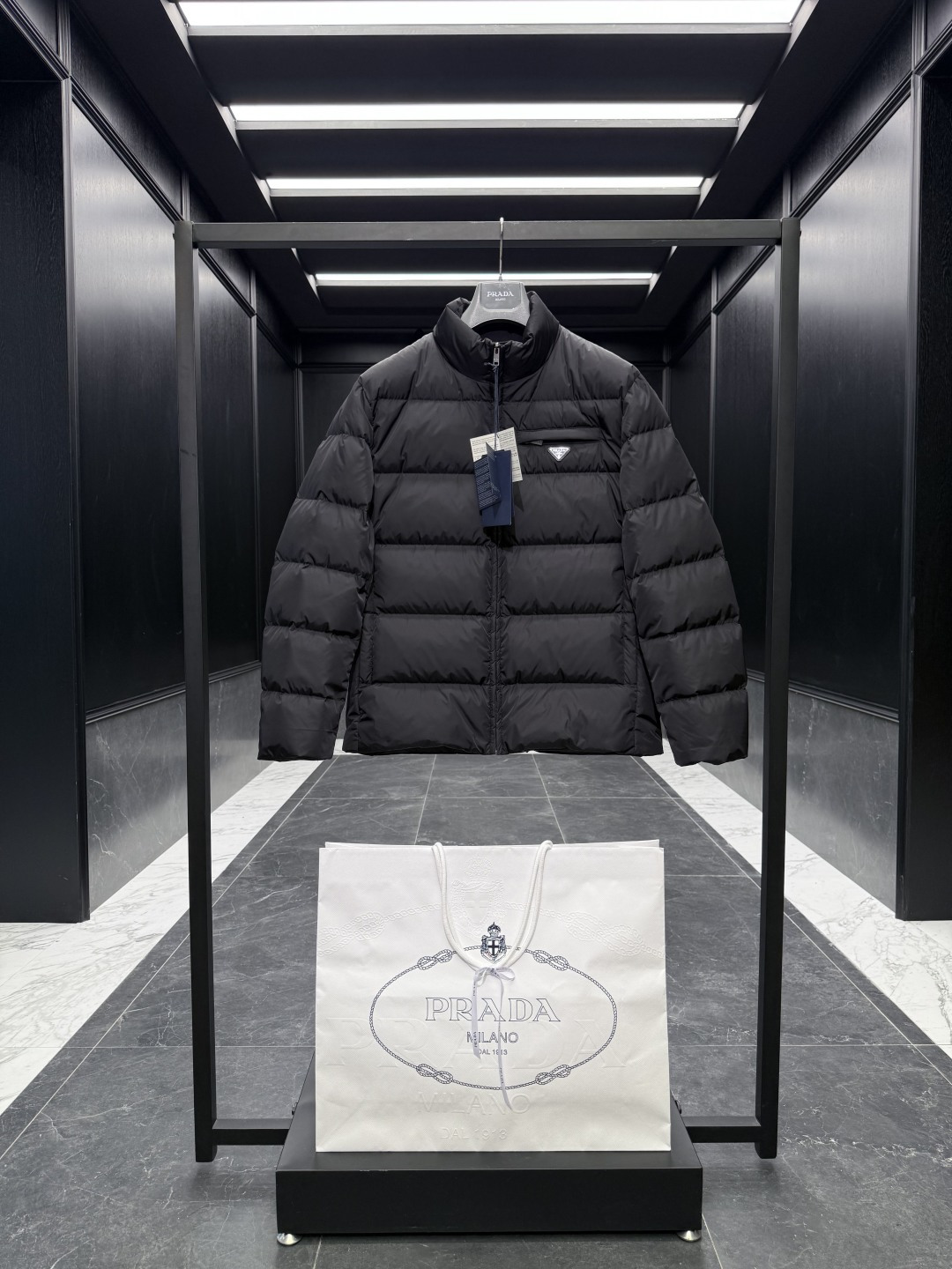 NO:573347,Special down Prada Re-Nylon regenerated nylon stand collar down jacket. 2025 new classic model. (The new model is a new fabric. The triangle badge is marked as a small mark) The original purchase and development. All synchronized with the latest. Special goose down filling original factory matching hardware.  Soft silhouettes and wrapped lines define this jacket, a sporty style with stylish details. Re-Nylon gives it functionality and modernity, while padding adds warmth. This down jacket has a modern silhouette that blends sporty style with fashionable details. The casual design features an enamelled triangle metal logo, a padded collar and goose down padding. Oversize fit Padded collar Straight sleeves Zipper closure Welt pockets Straight cuffs Wide shoulders Straight hem Leather trim  Goose down lining and padding Enamel triangle metal logo on chest   Size48-56 black navy cocoa brown,,prada,versace,jackets & coats,jackets & coats,down jacket,alexander wang19860909特级羽绒Prada Re-Nylon再生尼龙立领羽绒夹克外套.2025全新经典款.(新款为全新面料.三角徽章标为小标)原版购入开发.全部同步最新.特级鹅绒填充原厂配套五金. 柔和的廓形和包裹线条定义此款夹克,运动风格搭配时尚细节.Re-Nylon赋予其功能性和现代感,填充更添温暖.这款羽绒夹克采用现代廓形,融合了运动风格与时尚细节.休闲设计点缀涂珐琅三角形金属徽标,搭配加厚衣领和鹅绒填充. Oversize版型 加厚衣领 直筒袖 拉链开合 嵌线袋 直筒袖口 宽肩 平直底边 真皮边饰 鹅绒衬里与填充 胸前涂珐琅三角形金属徽标 Size48-56 黑色 藏青 可可棕,,prada,versace,jackets & coats,jackets & coats,down jacket,alexander wang,Men's clothing