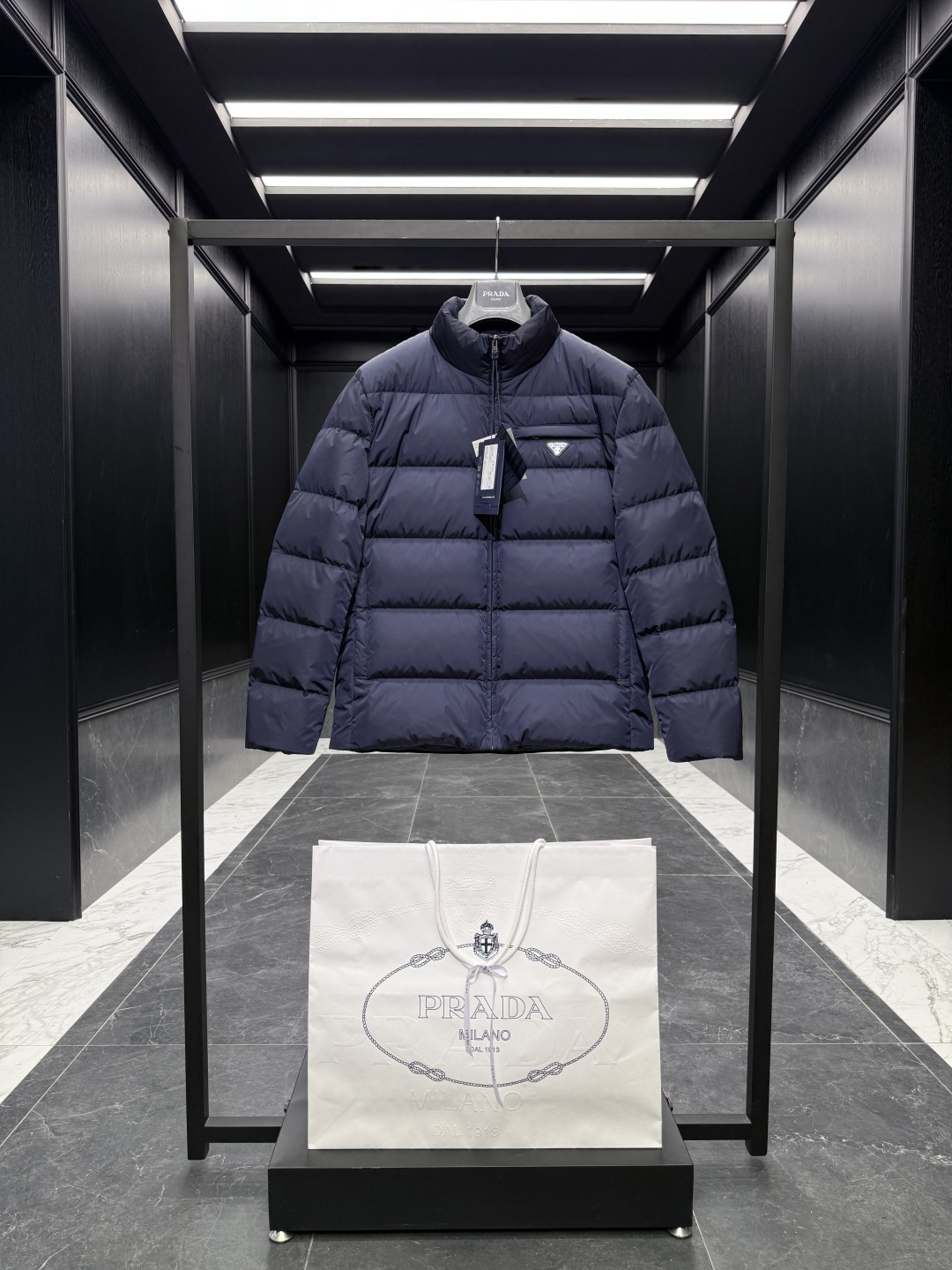 NO:573353,Special down Prada Re-Nylon regenerated nylon stand collar down jacket. 2025 new classic model. (The new model is a new fabric. The triangle badge is marked as a small mark) The original purchase and development. All synchronized with the latest. Special goose down filling original factory matching hardware.  Soft silhouettes and wrapped lines define this jacket, a sporty style with stylish details. Re-Nylon gives it functionality and modernity, while padding adds warmth. This down jacket has a modern silhouette that blends sporty style with fashionable details. The casual design features an enamelled triangle metal logo, a padded collar and goose down padding. Oversize fit Padded collar Straight sleeves Zipper closure Welt pockets Straight cuffs Wide shoulders Straight hem Leather trim  Goose down lining and padding Enamel triangle metal logo on chest   Size48-56 black navy cocoa brown,,prada,versace,jackets & coats,jackets & coats,down jacket,alexander wang19860909特级羽绒Prada Re-Nylon再生尼龙立领羽绒夹克外套.2025全新经典款.(新款为全新面料.三角徽章标为小标)原版购入开发.全部同步最新.特级鹅绒填充原厂配套五金. 柔和的廓形和包裹线条定义此款夹克,运动风格搭配时尚细节.Re-Nylon赋予其功能性和现代感,填充更添温暖.这款羽绒夹克采用现代廓形,融合了运动风格与时尚细节.休闲设计点缀涂珐琅三角形金属徽标,搭配加厚衣领和鹅绒填充. Oversize版型 加厚衣领 直筒袖 拉链开合 嵌线袋 直筒袖口 宽肩 平直底边 真皮边饰 鹅绒衬里与填充 胸前涂珐琅三角形金属徽标 Size48-56 黑色 藏青 可可棕,,prada,versace,jackets & coats,jackets & coats,down jacket,alexander wang,Men's clothing