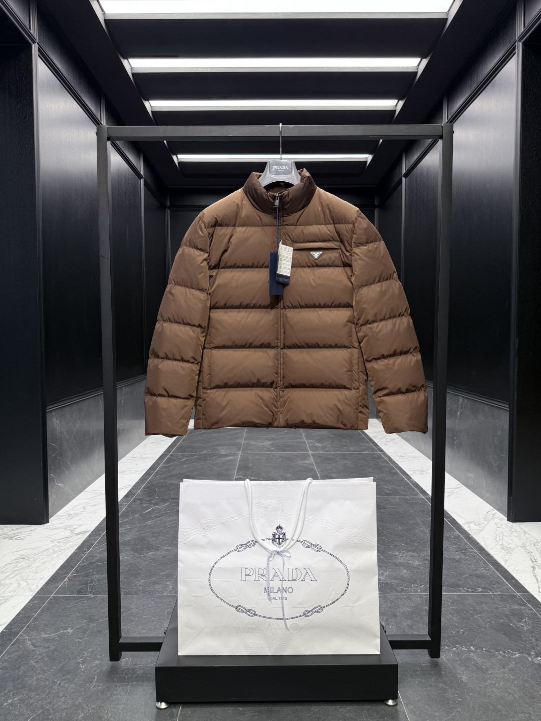 NO:573359,Special down Prada Re-Nylon regenerated nylon stand collar down jacket. 2025 new classic model. (The new model is a new fabric. The triangle badge is marked as a small mark) The original purchase and development. All synchronized with the latest. Special goose down filling original factory matching hardware.  Soft silhouettes and wrapped lines define this jacket, a sporty style with stylish details. Re-Nylon gives it functionality and modernity, while padding adds warmth. This down jacket has a modern silhouette that blends sporty style with fashionable details. The casual design features an enamelled triangle metal logo, a padded collar and goose down padding. Oversize fit Padded collar Straight sleeves Zipper closure Welt pockets Straight cuffs Wide shoulders Straight hem Leather trim  Goose down lining and padding Enamel triangle metal logo on chest   Size48-56 black navy cocoa brown,,prada,versace,jackets & coats,jackets & coats,down jacket,alexander wang19860909特级羽绒Prada Re-Nylon再生尼龙立领羽绒夹克外套.2025全新经典款.(新款为全新面料.三角徽章标为小标)原版购入开发.全部同步最新.特级鹅绒填充原厂配套五金. 柔和的廓形和包裹线条定义此款夹克,运动风格搭配时尚细节.Re-Nylon赋予其功能性和现代感,填充更添温暖.这款羽绒夹克采用现代廓形,融合了运动风格与时尚细节.休闲设计点缀涂珐琅三角形金属徽标,搭配加厚衣领和鹅绒填充. Oversize版型 加厚衣领 直筒袖 拉链开合 嵌线袋 直筒袖口 宽肩 平直底边 真皮边饰 鹅绒衬里与填充 胸前涂珐琅三角形金属徽标 Size48-56 黑色 藏青 可可棕,,prada,versace,jackets & coats,jackets & coats,down jacket,alexander wang,Men's clothing