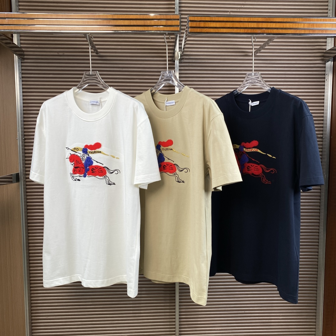 NO:859094,(Original customization) Burberry New Year Series Equestrian Knight logo cotton T-shirt, limited edition for the Year of the Horse 2026. The core design is the iconic Equestrian Knight logo (EKD) on the chest, using terry embroidery/embroidery technology. The contrasting design of the red horse and blue knight is highly recognizable and echoes the theme of the Year of the Horse. The color selection chart shows three colors of chalk white, light khaki, and navy blue, all of which are loose round neck styles.  Material and craftsmanship Pure cotton fabric, breathable and skin-friendly; the collar is ribbed knitted, and the decorative part is blended with wool and metallic yarn to enhance the texture. The background of the series belongs to the brand's Year of the Horse New Year capsule series, which is hand-painted in a watercolor and ink style to renew the classic equestrian knight elements, symbolizing luck and prosperity. The style is British light luxury, simple and high-end, suitable for daily commuting and casual outings. It can be worn alone with jeans/casual pants, or layered with shirts to create a layered look.  Positioned as an entry-level luxury brand, it has both brand recognition and practical wearability. It is also a collection choice for the Year of the Horse theme. The official price is about 4, (domestic) / $ (overseas), burberry, jeans, shirts, tees, t-shirt,19860909（原版定制） Burberry（博柏利）新禧贺岁系列 马术骑士徽标棉质T恤,为2026马年限定款. 核心设计胸前是标志性马术骑士徽标（EKD）,采用毛巾绣/刺绣工艺,红马蓝骑士的撞色设计极具辨识度,呼应马年主题. 颜色选择图中展示了粉笔白、浅卡其色、藏青色三种配色,均为宽松圆领版型. 材质与工艺纯棉面料,透气亲肤；领口为罗纹针织,装饰部分混纺羊毛与金属感纱线,提升质感. 系列背景属于品牌马年新春胶囊系列,以水彩水墨风格手绘焕新经典马术骑士元素,象征幸运与繁盛. 风格英伦轻奢风,简约高级,适合日常通勤、休闲出街. 搭配可单穿搭配牛仔裤/休闲裤,也可叠穿衬衫打造层次感. 定位奢牌入门级单品,兼具品牌辨识度与实穿性,也是马年主题的收藏之选. 官方售价约4,（国内）/ $（海外）,,burberry,jeans,shirts,tees，t-shirt,,Women's clothing