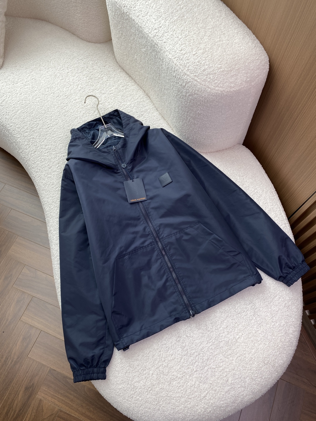 NO:957830,Louis Vuitton's reversible hooded jacket belongs to the brand's classic functional style reversible series and is available in two colors: navy blue and black. The core design is reversible, one side is made of solid matte nylon fabric, with the same color square logo (LV logo) on the chest, low-key and simple; the other side is dark patterned Monogram jacquard, luxurious and restrained. The design of hood + zipper closure + elastic cuffs and hem is both windproof and practical.  The material and pattern are made of high-density waterproof nylon composite fabric, which is stiff and wear-resistant, and has mild water-repellent properties; the lining is made of breathable mesh/jacquard fabric, and the pattern is a loose shoulder cut. It is the same style for men and women, and is suitable for a variety of body shapes. The style is positioned as a two-piece suit. The solid color side is suitable for commuting and light business, and the prefabricated side is suitable for going out and leisure. It is a versatile light luxury item in autumn and autumn. 1. Solid color (navy/black) upper body  The fit is loose and dropped shoulders, and the upper body has a casual and lazy silhouette, which can modify the shoulder line, cover the flesh and make you look slimmer. Wear it with a white T-shirt + straight jeans + white shoes, which is refreshing and clean, suitable for daily commuting; layering a turtleneck + casual trousers + loafers is simple and refined, suitable for light business scenes. The visual highlight is the square logo on the chest, which is low-key and unobtrusive, the matte fabric has a high-end texture, and the overall shape is neat and non-procrastinating. 2.  The upper body is made of presbyopic fabric (dark patterned Monogram). The loose silhouette remains unchanged. The dark patterned presbyopic pattern looms under the light, giving it a full sense of luxury and avoiding the exaggeration of the all-over print. Pair it with a black hooded sweatshirt + workwear leggings + Martin boots to enhance the sense of street functionality and is suitable for going out and camping. Pair it with the same series of presbyopic trousers to create a complete LV look, retro luxury.  The visual highlight is the fusion of Monogram dark pattern jacquard and fabric texture, which is highly recognizable but not ostentatious. It is a typical representative of 'low-key luxury'. Daily casual solid color surface + white T + jeans + white shoes, refreshing and age-reducing. Street functional old pattern surface + hooded sweatshirt + overalls + Martin boots, tough and stylish. Light and sophisticated commuting solid color surface + turtleneck sweater + casual trousers + loafers, simple and decent.,, louis vuitton, louis  vuitton,louis vuitton,loafers,boots,hoodie,sweatshirts,jeans,jackets & coats,sweaters,tees,t-shirt,hats,19860909Louis Vuitton（路易威登）双面穿连帽夹克,属于品牌经典的机能风双面系列,提供藏青与黑色两种配色. 核心设计双面可穿设计,一面为纯色哑光尼龙面料,胸前点缀同色方块徽标（LV标识）,低调简约；另一面为暗纹Monogram老花提花,奢华内敛.连帽+拉链开合+松紧袖口下摆的设计,兼顾防风与实用性. 材质与版型采用高密度防水尼龙复合面料,挺括耐磨,具备轻度防泼水性能；内里为透气网布/提花面料,版型为宽松落肩剪裁,男女同款,适配多种身形. 风格定位一衣两穿,纯色面适合通勤、轻商务,老花面适合出街、休闲,是秋秋季百搭的轻奢单品. 1. 纯色面（藏青/黑）上身 版型效果宽松落肩剪裁,上身自带随性慵懒的廓形感,能修饰肩线,遮肉显瘦. 穿搭场景内搭白色T恤+直筒牛仔裤+小白鞋,清爽干净,适合日常通勤；叠穿高领毛衣+休闲西裤+乐福鞋,简约精致,适配轻商务场景. 视觉亮点胸前方块徽标低调不张扬,哑光面料质感高级,整体造型利落不拖沓. 2. 老花面（暗纹Monogram）上身 版型效果宽松廓形不变,暗纹老花在光线下若隐若现,高级感拉满,避免了满印款的浮夸感. 穿搭场景内搭黑色连帽卫衣+工装束脚裤+马丁靴,强化街头机能感,适合出街、露营；搭配同系列老花长裤,打造全套LV造型,复古奢华. 视觉亮点Monogram暗纹提花与面料肌理融合,辨识度高却不张扬,是“低调奢华”的典型代表. 日常休闲纯色面+白T+牛仔裤+小白鞋,清爽减龄. 街头机能老花面+连帽卫衣+工装裤+马丁靴,硬朗有型. 轻熟通勤纯色面+高领毛衣+休闲西裤+乐福鞋,简约得体.,,louis vuitton,louis vuitton,louis vuitton,loafers,boots,hoodie,sweatshirts,jeans,jackets & coats,sweaters,tees，t-shirt,hats,,Men's clothing
