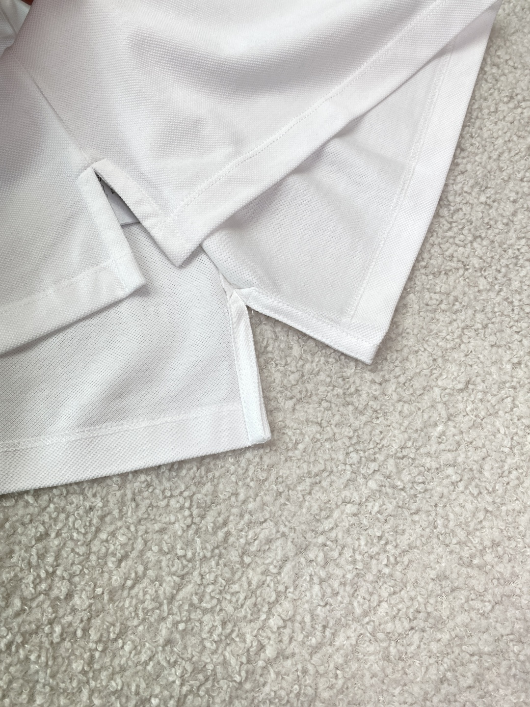 • 面料与工艺：采用棉质珠地布（Cotton Piqué）制作，透气亲肤；罗纹翻领与袖口，搭配珍珠母贝纽