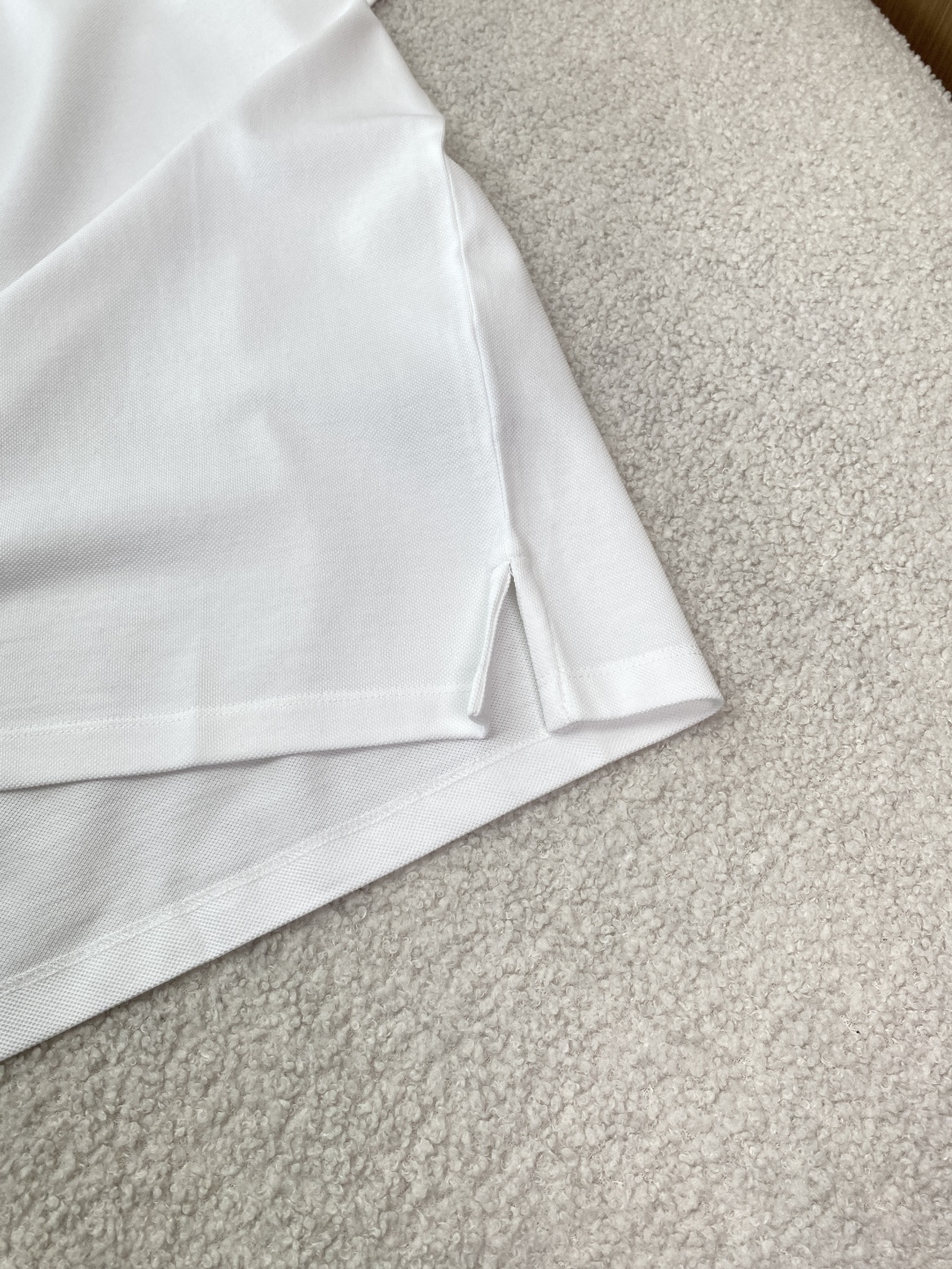 • 面料与工艺：采用棉质珠地布（Cotton Piqué）制作，透气亲肤；罗纹翻领与袖口，搭配珍珠母贝纽