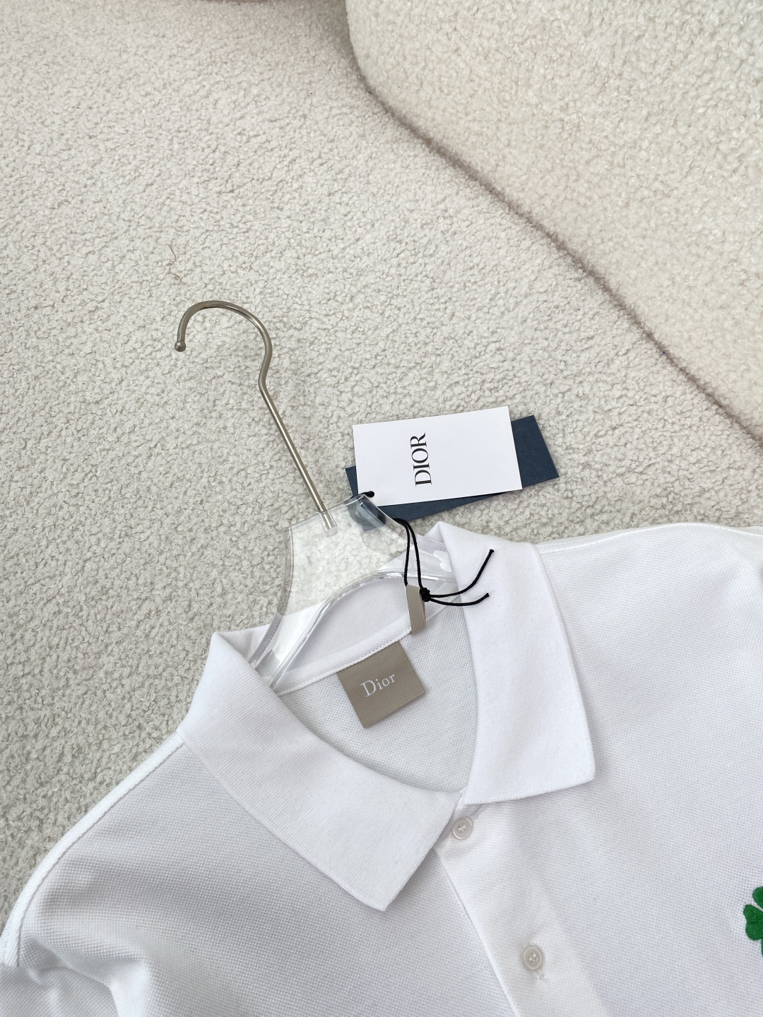 • 面料与工艺：采用棉质珠地布（Cotton Piqué）制作，透气亲肤；罗纹翻领与袖口，搭配珍珠母贝纽
