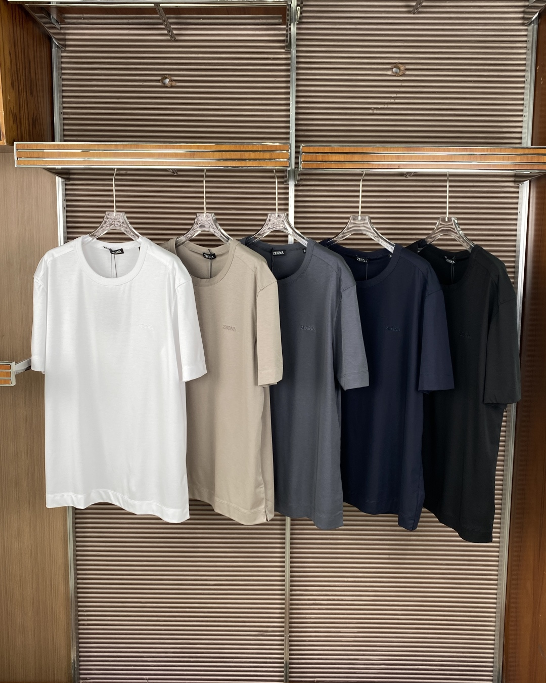 NO:903740,(Liquid ammonia mercerization) ZEGNA solid color round neck short-sleeved T-shirt with exquisite gift packaging! ! ! The brand is positioned as Italy's top men's clothing brand, known for its high-quality fabrics and exquisite craftsmanship. This T-shirt is the core basic line of the brand and is suitable for mature men who pursue low-key luxury. The fabric material is made of high-count combed cotton/mercerized cotton (some styles contain mulberry silk blend), which is smooth and soft to the touch, with a delicate luster, breathable and sweat-absorbent, with excellent drape, and the upper body is comfortable and not stuffy. The version design is loose shoulder cut, moderate length, slits on both sides of the hem, allowing free movement and not easy to roll up. The round neck adopts double-layered ribbing technology, which is not easy to deform or curl after long-term wear, and fits the neck without rubbing. Detailed craftsmanship. The left chest is embroidered with the same color 'ZEGNA' letter logo. The stitching is fine and exquisite, low-key and unobtrusive, highlighting the brand identity. The shoulders, cuffs, and hem are all double-thread reinforced sewing, with neat stitching, no excess thread, and exquisite workmanship. Color options include classic basic colors such as navy blue, white, black, light gray, etc., suitable for different wearing scenarios and skin colors. For business casual wear alone, pair with trousers/casual pants + loafers, simple and high-end, suitable for office and business negotiations. For daily commuting, pair with jeans + white shoes, low-key and comfortable, suitable for shopping and dating The layered inner layer can be used as the inner layer of shirts and suits to add a sense of layering and suit formal occasions, zegna, loafers, jeans, shirts, T-shirts, tees, t-shirts, business suits,19860909（液氨丝光） ZEGNA（杰尼亚）纯色圆领短袖T恤 精美礼品包装！！！ 品牌定位意大利顶级男装品牌,以高品质面料与精湛工艺著称,这款T恤属于品牌核心基础线,适合追求低调奢华的成熟男士. 面料材质采用高支精梳棉/丝光棉（部分款式含桑蚕丝混纺）,触感顺滑柔软,带有细腻光泽,透气吸汗,垂坠感极佳,上身舒适不闷. 版型设计 宽松落肩剪裁,衣长适中,下摆两侧开叉,活动自如且不易上卷 圆领采用双层罗纹包边工艺,久穿不易变形、卷边,贴合颈部不磨肤 细节工艺 左胸处绣有同色系“ZEGNA”字母Logo,针脚细密精致,低调不张扬,彰显品牌身份 肩部、袖口、下摆均采用双线加固缝制,走线工整,无多余线头,做工考究 配色选择藏青色、白色、黑色、浅灰等经典基础色,适配不同穿搭场景与肤色. 商务休闲单穿搭配西裤/休闲裤+乐福鞋,简约高级,适合办公、商务洽谈 日常通勤搭配牛仔裤+小白鞋,低调舒适,适合逛街、约会 叠穿内搭可作为衬衫、西装的内搭,增加层次感,适配正式场合,,zegna,loafers,jeans,shirts,T-shirt,tees，t-shirt,business suit,,Women's clothing
