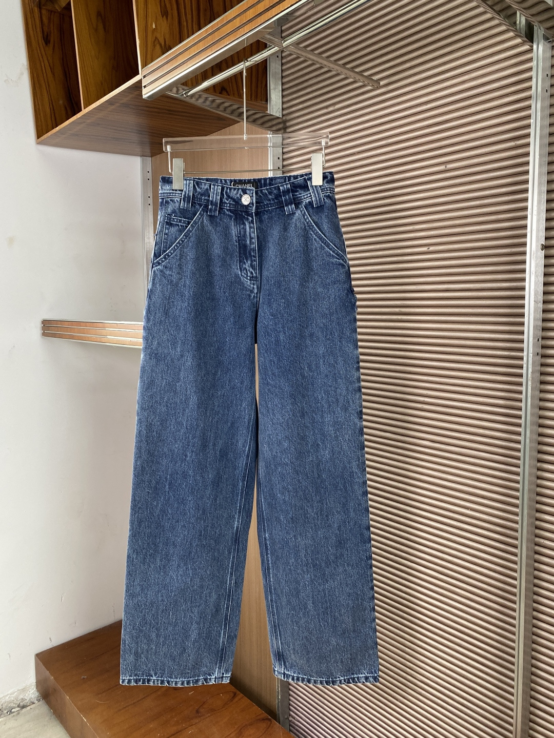 NO:873273,(Excellent quality, popular top style) CHANEL (Chanel) work style wide-leg jeans 1. Front design, high waist structure, with multiple sets of trouser loops, which can be worn with a belt to enhance the shape; the placket uses the brand's iconic double C metal button, with clear engravings and a thick texture. The front pockets are diagonally inserted + side seam tool pockets, restoring the practical features of work pants while maintaining a neat look.  The trousers are wide-legged and straight-cut, with the same width from the thigh to the trouser legs, with good drape, and a sense of elegance when walking. 2. Back design: Two large square patch pockets on the pockets, and an additional tool pocket on the side, which are the classic identifying features of overalls, both decorative and practical. All pockets and trouser seams are double-thread reinforced, and the stitching is fine and even, reflecting the level of luxury craftsmanship. 3. Label details  White CHANEL hangtag, with the brand's classic double C embossing, and regular printed fonts. The waistband has a white CHANEL logo on a black background, with a double C logo next to it, and the edges are smooth and burr-free. The fabric is cotton denim, which has been washed and distressed to show a natural retro blue tone. The cloth surface has a clear texture and a stiff feel to maintain the wide-leg silhouette while retaining the skin-friendly breathability of cotton.,,chanel,chanel,jeans,19860909（品质超赞、上身爆款） CHANEL（香奈儿） 工装风阔腿牛仔裤 1. 正面设计 腰头高腰结构,搭配多组裤袢,可搭配腰带强化造型；门襟采用品牌标志性双C金属纽扣,刻字清晰,质感厚重. 口袋前片斜向插袋+侧缝工具袋,还原工装裤实用特征,同时保持视觉利落. 裤型阔腿直筒剪裁,从大腿到裤脚宽度一致,垂感良好,走路时自带飘逸感. 2. 背面设计 口袋两个大号方形贴袋,侧边额外设置工具袋,是工装裤的经典识别特征,兼具装饰性与实用性. 缝线所有口袋与裤缝均采用双线加固,针脚细密均匀,体现奢侈品工艺水准. 3. 标签细节 吊牌白色CHANEL吊牌,带有品牌经典双C压纹,印刷字体规整. 腰标黑色底白字CHANEL标识,旁附双C徽标,边缘平整无毛刺. 面料棉牛仔布,经过水洗做旧处理,呈现自然的复古蓝调,布面纹理清晰,手感偏硬挺以维持阔腿廓形,同时保留棉质的亲肤透气性.,,chanel,chanel,jeans,,Women's clothing