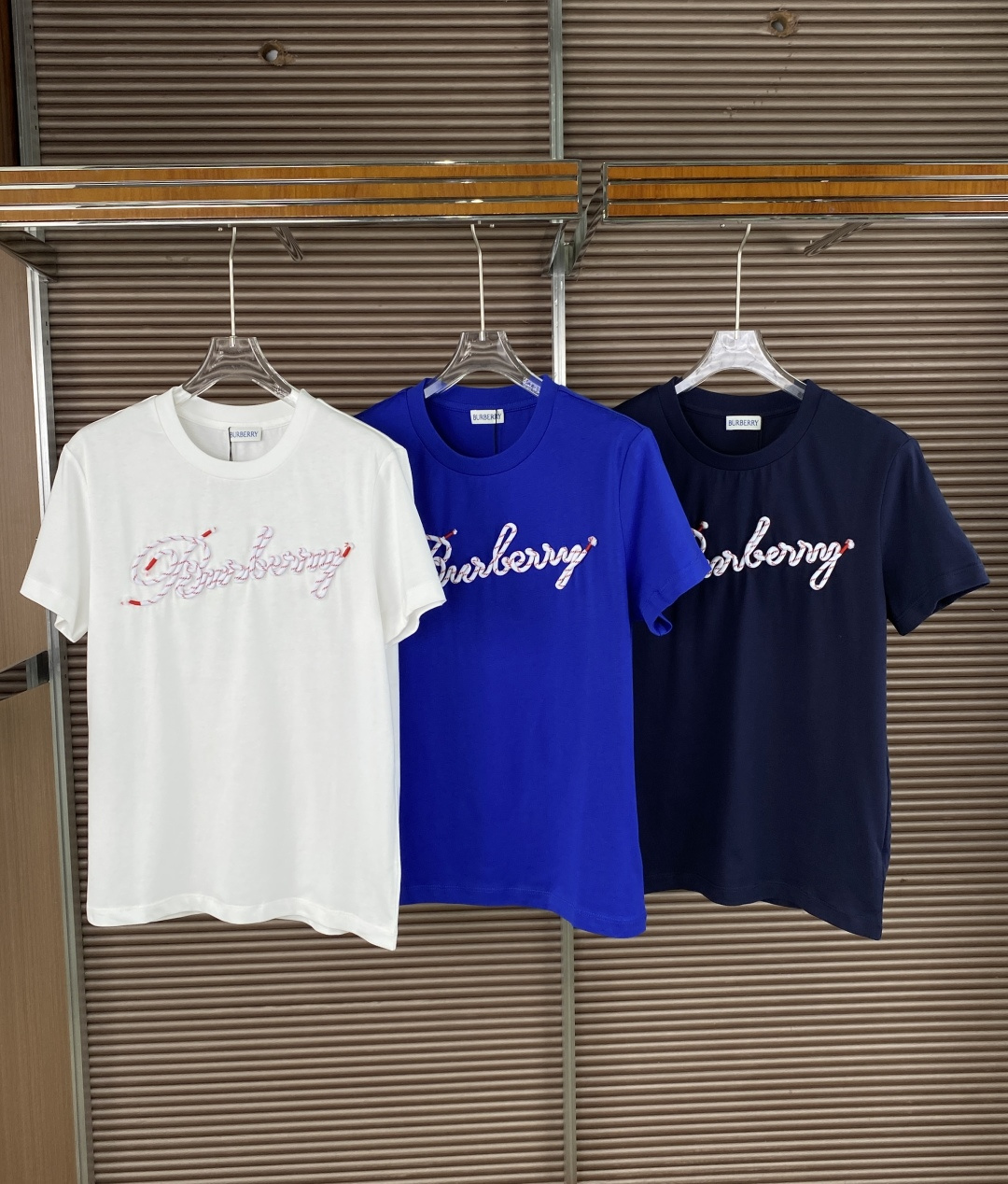 NO:835708,Burberry knot logo cotton T-shirt 1. Core vision: The front uses red and white knot embroidery technology to restore the texture of shoelaces and embroider the Burberry floral logo. The ends of the knot are decorated with red endings and have exquisite details. The ribbed round neck design fits the neck and is not easy to deform; the short sleeves are neatly cut and modify the arm lines. The straight hem and no slits on the sides maintain the overall simplicity. 2. Craftsmanship highlights  The embroidered knot logo is a combination of three-dimensional appliqué + thread embroidery, which has a clear texture and is resistant to washing and not easy to fall off. The neckline is reinforced with inner strips to avoid curling after washing and improve wearing life. The main fabric is cotton (jersey knitted cotton), which is soft and skin-friendly, has good breathability, and is suitable for spring and summer wear. Knitted accessories (collar/cuffs) are 95 cotton + 5 spandex, which increases elasticity, improves fit and comfort, and is not easy to loosen. 1.  For daily commuting, the white model + straight jeans + white shoes are refreshing and clean, suitable for casual scenes in the workplace. The navy blue model + khaki casual pants + loafers create a British retro style. 2. For casual outings, the royal blue model + sports shorts + dad shoes are full of vitality and suitable for weekend trips. Wear them layered with a turtleneck bottoming shirt and a denim jacket to extend the spring and autumn wearing cycle. 3. Parent-child wear  Adult models + children's models are matched in the same color to create a warm parent-child look that is highly recognizable.,,burberry,loafers,shorts,jeans,jackets & coats,T-shirt,tees,t-shirt,19860909Burberry 绳结徽标棉质T恤 1. 核心视觉 正面采用红白相间绳结刺绣工艺,还原鞋带缠绕质感,绣出Burberry花体logo,绳结两端点缀红色收尾,细节精致. 罗纹圆领设计,贴合颈部,不易变形；短袖剪裁利落,修饰手臂线条. 平直下摆,侧边无开衩,保持整体简洁感. 2. 工艺亮点 刺绣工艺绳结logo采用立体贴布绣+线绣结合,纹理清晰,耐洗不易脱线. 领口加固领内贴条处理,避免洗后卷边,提升穿着寿命. 主体面料棉（平纹针织棉）,触感柔软亲肤,透气性佳,适合春夏穿着. 针织辅料（领口/袖口）95棉+5氨纶,增加弹性,提升贴合度与舒适度,不易松垮. 1. 日常通勤 白色款+直筒牛仔裤+小白鞋,清爽干净,适配职场休闲场景. 藏青色款+卡其色休闲裤+乐福鞋,打造英伦复古风. 2. 休闲出街 宝蓝色款+运动短裤+老爹鞋,活力感十足,适合周末出行. 叠穿内搭高领打底衫,外搭牛仔外套,延长春秋穿着周期. 3. 亲子穿搭 成人款+儿童款同色搭配,打造温馨亲子造型,辨识度极高.,,burberry,loafers,shorts,jeans,jackets & coats,T-shirt,tees，t-shirt,,Women's clothing