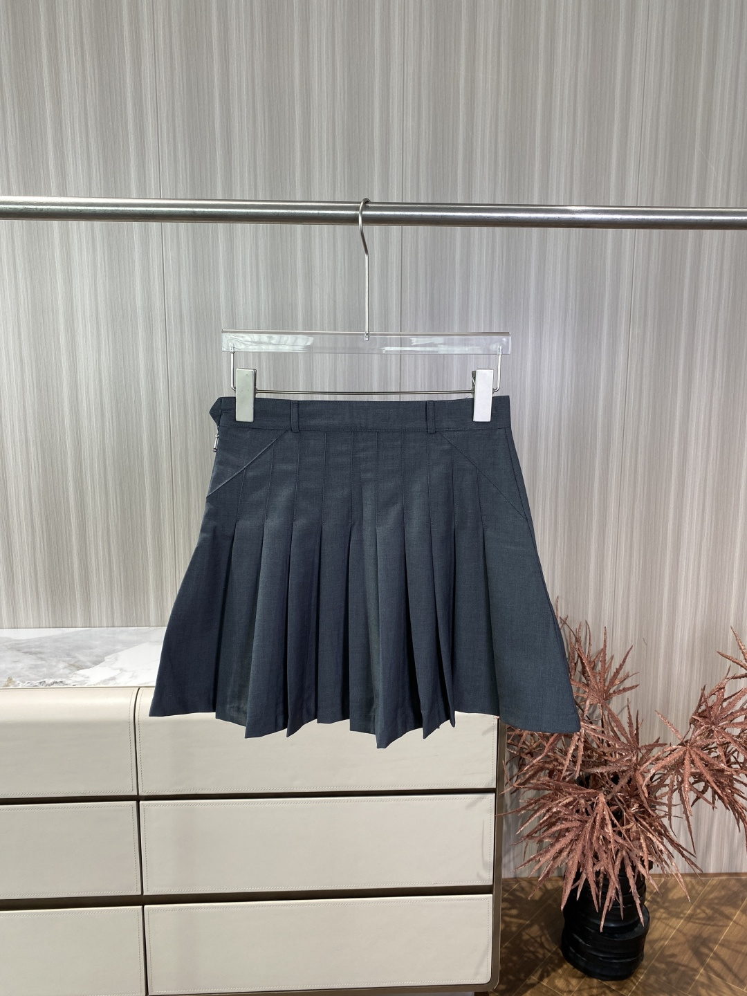 NO:842498,Thom Browne dark gray pleated skirt brand belongs to Thom Browne. It is an American light luxury designer brand with gray, college style and deconstruction as its core style. The red, white and blue ribbon is its most representative identification symbol. The design traces its origin. This pleated skirt originates from the American preppy style. It is the brand's representative work of transforming traditional school uniform elements into high fashion and is also one of Thom Browne's best-selling items.  Logo Features The red, white and blue three-color webbing at the back waist is the core logo of the brand, and the inner lining also uses the iconic red, white and blue stripes, which strengthens the brand recognition. Fabric material The outer surface is wool (worsted twill suit material), which has a crisp texture and strong drape. It has a high-grade matte texture and is not easy to wrinkle. The lining is cupro fiber, which is skin-friendly and breathable to avoid skin discomfort. The webbing part is polyester fiber to ensure that the webbing is stiff and not deformed. Version and tailoring  The high-waisted design optimizes body proportions and visually lengthens the leg lines. The irregular pleated cut and short skirt length give it a lively academic feel while retaining the neatness of high fashion. The side invisible zipper + waist button design makes it easy to put on and take off and ensures a smooth waist. Craftsmanship details The pleat pressing process is solid and the pleat shape can be maintained after multiple washes. The stitching is neat and the edges are delicately processed.  The style is positioned as a typical American college style + high fashion sense, which can be salty or sweet, and is suitable for a variety of scenarios. Wearing scenarios: Pair it with a white shirt and loafers of the same brand for daily casual wear, creating a classic preppy style. Wear it with a gray suit jacket and mid-calf socks for commuting to work, which is smart yet individual. Mix and match sweet and cool with a short sweatshirt and dad shoes to weaken the formal feeling and become more street fashion.  Color matching: Dark gray is a neutral color, which can be perfectly matched with black and white, navy blue, burgundy and other colors, and has strong compatibility.,, loafers, hoodie, sweatshirts, skirts, jackets & coats, shirts, business suits,19860909Thom Browne 深灰百褶短裙 品牌归属Thom Browne 是美国轻奢设计师品牌,以灰色系、学院风、解构主义为核心风格,红白蓝三色织带是其最具代表性的识别符号. 设计溯源这款百褶裙源自美式预科生（Preppy）风格,是品牌将传统校服元素高级时装化的代表作,也是 Thom Browne 最畅销的单品之一. 标识特征后腰处的红白蓝三色织带是品牌核心标识,内侧衬里也采用标志性的红白蓝条纹,强化了品牌辨识度. 面料材质 表地 羊毛（精纺斜纹西装料）,质感挺括、垂坠感强,自带高级哑光质感,不易皱. 里地 铜氨纤维,亲肤透气,避免贴肤不适. 织带部分 聚酯纤维,保证织带挺括不变形. 版型与剪裁 高腰设计,优化身材比例,视觉上拉长腿部线条. 不规则百褶剪裁,裙长偏短,呈现活泼的学院感,同时保留了高级时装的利落感. 侧边隐形拉链+腰头纽扣设计,穿脱方便且保证腰部平整. 工艺细节 百褶压烫工艺扎实,多次洗涤后仍能保持褶型. 缝线工整,边缘处理细腻. 风格定位典型的美式学院风+高级时装感,可盐可甜,适配多种场景. 穿搭场景 日常休闲搭配同品牌白色衬衫、乐福鞋,打造经典 Preppy 风. 通勤职场外搭灰色西装外套,下配中筒袜,干练又不失个性. 甜酷混搭搭配短款卫衣、老爹鞋,弱化正式感,更具街头潮流感. 配色适配深灰色为中性色,可与黑白、藏蓝、酒红等颜色完美搭配,兼容性极强.,,loafers,hoodie,sweatshirts,skirts,jackets & coats,shirts,business suit,,Women's clothing