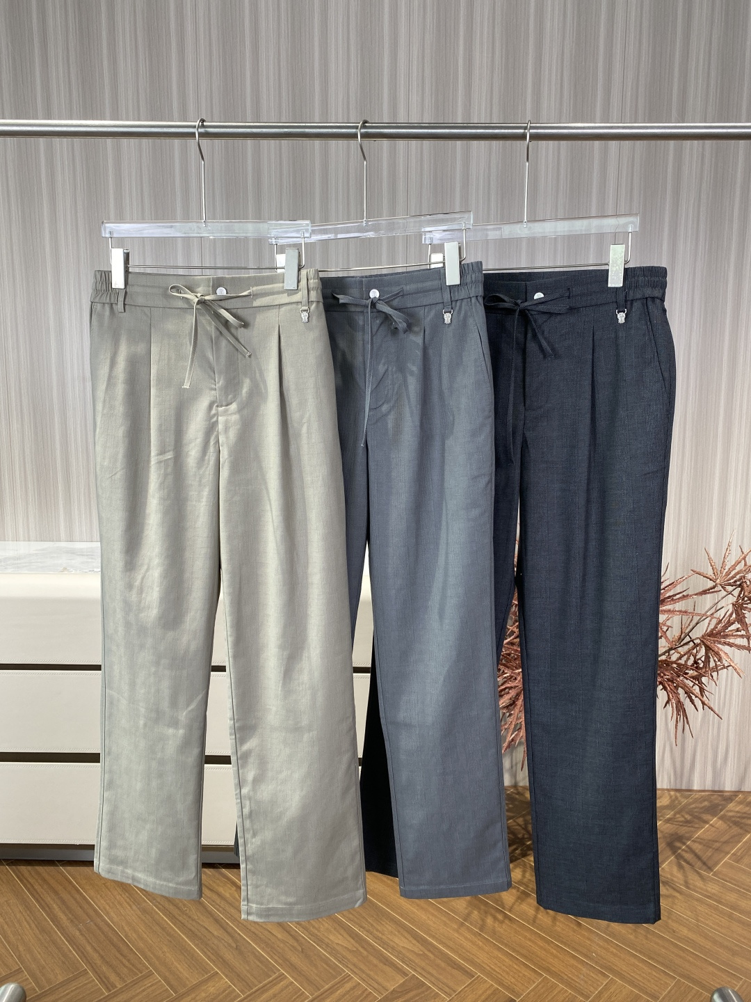 NO:824425,Brunello Cucinelli cotton and linen drawstring casual trousers, high-waisted straight-leg trousers with a single pleat design on the front, which modifies the waist and abdomen lines and has a strong sense of drape. The waist is designed with a semi-elastic waist + drawstring + button placket, which combines comfort and formality; both the drawstring metal head and the back waist are embossed with BC's iconic 'Crown + Castle' logo, which is low-key and refined. Pocket design: front oblique pockets, with double stitching reinforcement on the edge of the pocket, which is not easy to deform.  Double welt pockets (Welt Pocket) on the back panel and no flap design keep the trousers simple and neat. Details are embellished. The fabric of the trousers has a delicate dark grain texture, which enhances the sense of luxury. All seams are double stitches, and the stress-bearing parts are additionally reinforced. The colors are light khaki, medium gray, and dark gray, all BC classic earth tones, calm and versatile. Fiber composition: 95 cotton + 5 linen. Cotton ensures skin-friendly breathability, moisture absorption, and daily washability and wear resistance.  Linen gives the fabric a natural texture and coolness, improves drape and wrinkle resistance, and is suitable for spring and summer wear. The surface of the fabric has a plain texture with a slight hemp feel, which is soft and not rough to the touch. It is antistatic and not easy to pill. It is easier to care for than pure linen pants. Washing and care instructions: gentle hand/machine wash at a temperature below 30℃, use neutral detergent, do not bleach. Lay flat to dry to avoid hanging and deformation of the pants.  Iron with medium-temperature steam (up to 110°C), dry clean, do not flip and dry. Outfit and care suggestions. Outfit inspiration. Pair with sweaters, shirts or casual suits of the same brand for business commuting to create a 'Smart Casual' style. Pair with polo shirts, sweatshirts or short jackets for daily casual wear to create a relaxed look. Seasonally suitable for spring and autumn, wear alone, early summer/early autumn can be paired with a thin jacket, it is a basic style suitable for all seasons. Maintenance tips: Hang in a ventilated place after wearing to avoid frequent washing.  If there are stains, wipe them gently with a damp towel dipped in neutral detergent and avoid vigorous rubbing. When storing for a long time, fold it and put it in a dust bag to avoid direct sunlight.19860909Brunello Cucinelli 棉麻抽绳休闲西裤 版型剪裁高腰直筒裤,前片单褶设计,修饰腰腹线条,垂坠感强. 腰部设计半松紧腰+抽绳+纽扣门襟,兼顾舒适与正式感；抽绳金属头与后腰压印均为 BC 标志性「皇冠+城堡」徽标,低调精致. 口袋设计 前片斜插式口袋,袋口边缘双道缝线加固,不易变形 后片双嵌线袋（Welt Pocket）,无袋盖设计,保持裤身简洁利落 细节点缀 裤身面料带有细腻暗纹肌理,提升高级感 所有接缝处为双道缝线,受力部位额外加固 配色浅卡其、中灰、深灰三色可选,均为 BC 经典大地色系,沉稳百搭 纤维成分95棉 + 5亚麻 棉保证亲肤透气、吸湿排汗,日常耐洗耐磨 亚麻赋予面料天然肌理感与凉感,提升垂坠度与抗皱性,适合春夏季节穿着 面料特性表面为平纹肌理,带有细微麻感,触感柔软不粗糙,抗静电、不易起球,比纯亚麻裤更易打理 洗护规范 洗涤30℃以下水温轻柔手洗/机洗,使用中性洗涤剂,不可漂白 晾晒平铺晾干,避免悬挂导致裤身变形 熨烫中温蒸汽熨烫（最高110℃）,可干洗,不可翻转干燥 穿搭与保养建议 穿搭灵感 商务通勤搭配同品牌针织衫、衬衫或休闲西装,打造「Smart Casual」风格 日常休闲搭配Polo衫、卫衣或短款夹克,营造松弛感造型 季节适配春秋单穿,初夏/早秋可搭配薄外套,是四季皆宜的基础款 保养技巧 穿着后悬挂于通风处,避免频繁洗涤 若沾有污渍,用湿毛巾蘸中性洗涤剂轻擦,避免大力揉搓 长期存放时,折叠后放入防尘袋,避免阳光直射,,brunello cucinelli,hoodie,sweatshirts,jackets & coats,jackets & coats,shirts,business suit,,Women's clothing