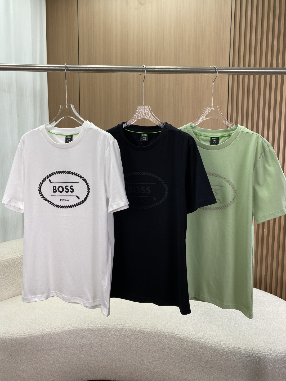 NO:905491,HUGO BOSS/Hugo Boss men's new summer golf logo cotton plain T-shirt Appearance design The collar adopts a classic round neck design, which is simple and elegant, suitable for various occasions. It has a good modification effect on the neck line and shows a neat and capable style. The collar has a green horizontal stripe contrasting design, which adds highlights and vitality to the overall simple shape and enhances the sense of fashion.  There is a golf-style BOSS logo offset printing design on the chest of the pattern, which presents a three-dimensional gummy touch. The offset printing process makes the pattern clear and textured, and the word 'BOSS' and 'EST.1997' highlight the brand's history and identity. At the same time, the golf elements give a sporty and fashionable atmosphere. The wiring is finely crafted, and the stitching is even and fine throughout the clothes. The collar, cuffs and sides of the clothes are neatly routed, reflecting the high-quality production level, ensuring the durability of the clothes and not prone to problems such as off-line.  The fabric material is made of cotton (excluding ingredients) cotton plain fabric, which is soft and skin-friendly, has good breathability and hygroscopicity, can keep the body dry and comfortable in summer, and the fabric texture makes the upper body of the clothes naturally drape. Three color options, light green, black, white and other classic and easy-to-match colors, meet different consumer preferences and matching needs.,, tees, t-shirt,19860909HUGO BOSS/雨果博斯男士夏季新款高尔夫徽标棉质平纹T恤 外观设计 领型采用经典圆领设计,简约大方,适合多种场合穿着,对颈部线条有较好修饰作用,展现利落干练风格.领子处有绿色横条撞色设计 ,为整体简约造型增添亮点与活力,提升时尚感. 图案胸口处是高尔夫风格的BOSS徽标胶印设计,呈现立体胶质触感.胶印工艺使图案清晰、有质感,且“BOSS”字样和“EST.1997” 彰显品牌历史与身份 ,同时高尔夫元素赋予运动时尚氛围. 走线做工精细,衣服各处缝线均匀细密,领口、袖口及衣服侧边等部位,走线工整,体现高品质制作水准,保证衣物耐用性,不易出现脱线等问题. 面料材质选用棉（配料除外）的棉质平纹面料,柔软亲肤,具有良好的透气性和吸湿性,夏季穿着能保持身体干爽舒适,且面料质感使衣服上身效果自然垂顺. 三个颜色选择,浅绿色、黑色、白色等经典且易搭配的颜色,满足不同消费者喜好和搭配需求.,,tees，t-shirt,,Women's clothing