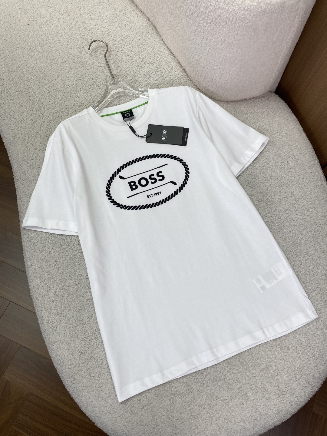 NO:884978,HUGO BOSS/Hugo Boss men's new summer golf logo cotton plain T-shirt Appearance design The collar adopts a classic round neck design, which is simple and elegant, suitable for various occasions. It has a good modification effect on the neck line and shows a neat and capable style. The collar has a green horizontal stripe contrasting design, which adds highlights and vitality to the overall simple shape and enhances the sense of fashion.  There is a golf-style BOSS logo offset printing design on the chest of the pattern, which presents a three-dimensional gummy touch. The offset printing process makes the pattern clear and textured, and the word 'BOSS' and 'EST.1997' highlight the brand's history and identity. At the same time, the golf elements give a sporty and fashionable atmosphere. The wiring is finely crafted, and the stitching is even and fine throughout the clothes. The collar, cuffs and sides of the clothes are neatly routed, reflecting the high-quality production level, ensuring the durability of the clothes and not prone to problems such as off-line.  The fabric material is made of cotton (excluding ingredients) cotton plain fabric, which is soft and skin-friendly, has good breathability and hygroscopicity, can keep the body dry and comfortable in summer, and the fabric texture makes the upper body of the clothes naturally drape. Three color options, light green, black, white and other classic and easy-to-match colors, meet different consumer preferences and matching needs.,, tees, t-shirt,19860909HUGO BOSS/雨果博斯男士夏季新款高尔夫徽标棉质平纹T恤 外观设计 领型采用经典圆领设计,简约大方,适合多种场合穿着,对颈部线条有较好修饰作用,展现利落干练风格.领子处有绿色横条撞色设计 ,为整体简约造型增添亮点与活力,提升时尚感. 图案胸口处是高尔夫风格的BOSS徽标胶印设计,呈现立体胶质触感.胶印工艺使图案清晰、有质感,且“BOSS”字样和“EST.1997” 彰显品牌历史与身份 ,同时高尔夫元素赋予运动时尚氛围. 走线做工精细,衣服各处缝线均匀细密,领口、袖口及衣服侧边等部位,走线工整,体现高品质制作水准,保证衣物耐用性,不易出现脱线等问题. 面料材质选用棉（配料除外）的棉质平纹面料,柔软亲肤,具有良好的透气性和吸湿性,夏季穿着能保持身体干爽舒适,且面料质感使衣服上身效果自然垂顺. 三个颜色选择,浅绿色、黑色、白色等经典且易搭配的颜色,满足不同消费者喜好和搭配需求.,,tees，t-shirt,,Women's clothing