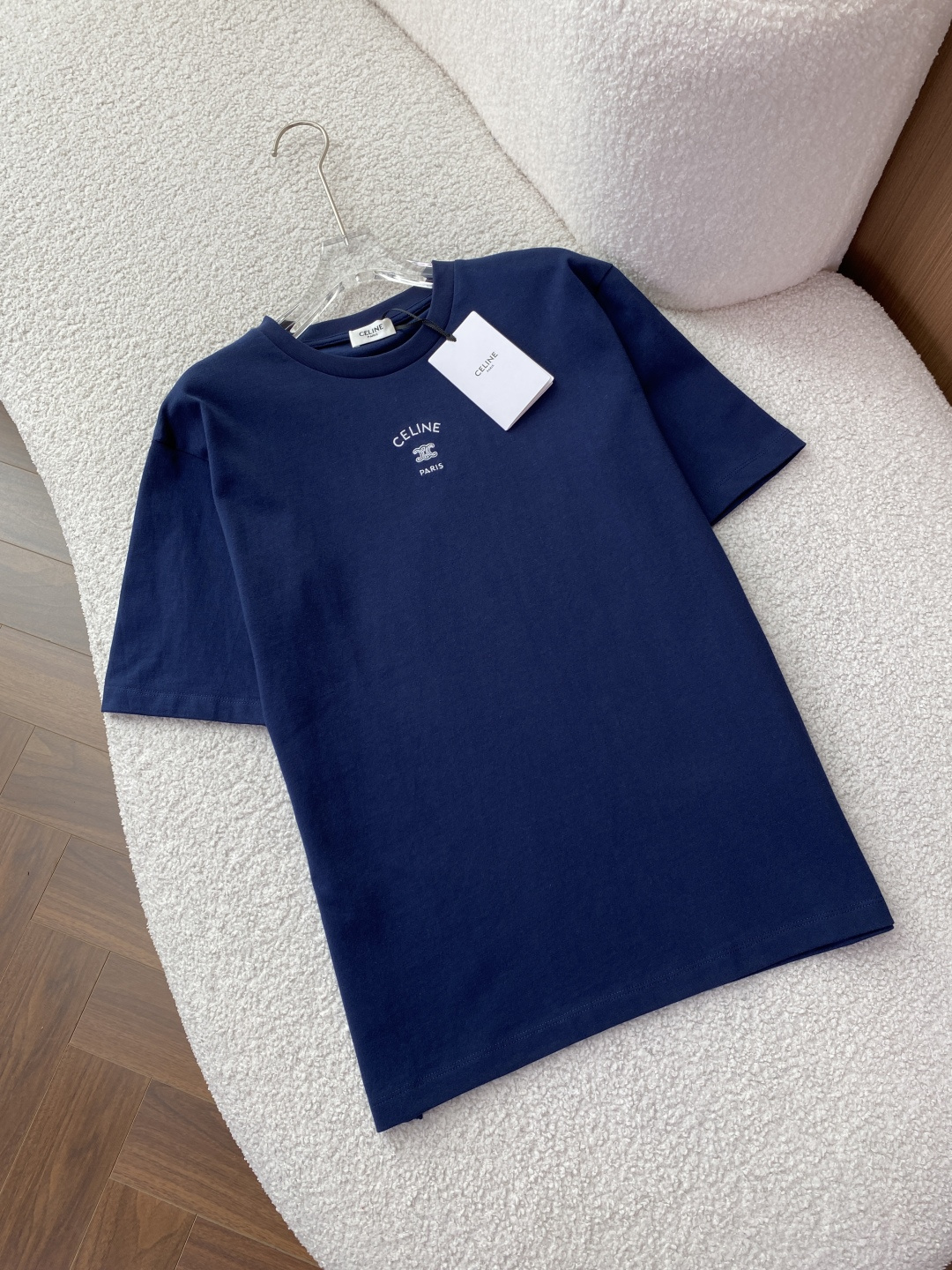 NO:885022,(Original customization) Celine Arc de Triomphe embroidered short-sleeved T-shirt in three classic colors: light heather gray, navy blue, and pure white. It focuses on simple, light and luxurious daily casual style, and restores Celine's iconic Triomphe (Arc de Triomphe) design elements. Design and appearance features  The core logo is precision embroidered in the same color on the chest, including the curved word 'CELINE', the classic Arc de Triomphe double C (Triomphe) logo and the word 'PARIS'. It is Celine's most recognizable visual symbol, low-key and high-end. The silhouette is a basic round-neck style, a loose off-shoulder version, regardless of body shape, and the same style for men and women. It can be worn alone or layered as an inner layer, suitable for a variety of scenes.  The ribbed round neck design with detailed craftsmanship is not easy to deform after long-term wear; the 'CELINE PARIS' collar label is sewn on the inside of the neckline to restore authentic details; the cuffs and hem are made of double-needle stitching, which is neat and fine, improving the durability of the clothing. The visual texture of the fabric has a moderate drape, and the overall shape is neat and clean without unnecessary decoration, which is in line with Celine's minimalist design aesthetics. Material  The fabric is made of cotton, with combed cotton technology. It is soft against the skin, has good moisture absorption and breathability, and is not sweaty when worn in summer. It feels comfortable to the touch. Washing requirements 1. It needs to be washed with clothes of the same color to avoid cross-color. 2. Clean and iron the reverse side to protect the integrity of the embroidery and fabric. 3. The washing symbol prompts that gentle washing in cold water, do not bleach, do not tumble dry at high temperatures, iron with a low temperature pad, and do not dry clean. Wearing scenarios and matching suggestions  Pair with straight-leg suit pants + loafers for commuting and workplace, which is simple and capable, suitable for light business scenes, and highlight the professional feel. For daily casual wear, pair with straight-leg jeans/sports pants + white shoes to create a relaxed look, suitable for weekend trips and shopping. Wear it layered with a denim jacket, baseball uniform or windbreaker to add a sense of layering, suitable for the transition season between spring and autumn, and enhance the sophistication of your look.  Color matching reference: light heather gray is gentle and age-reducing, navy blue is calm and white, and pure white is refreshing and clean. You can choose freely according to your personal style and skin color. Washing and maintenance instructions 1. Washing method is recommended to be gentle hand wash/machine wash in cold water, the water temperature does not exceed 30℃, wash on the inside out to avoid friction between the embroidery and other clothes. 2. Hang to dry in the drying method to avoid exposure to the sun and prevent the fabric from yellowing and deformation. 3.  Ironing requires ironing with a cloth on the back, and the temperature should not exceed 110°C. Do not iron the embroidery area directly to prevent the embroidery from deforming or falling off. 4. Storage is recommended to be folded and stored or hung to avoid wrinkles caused by long-term extrusion.,,celine,loafers,jeans,jackets & coats,T-shirt,tees,t-shirt,business suit,19860909（原版定制） Celine（思琳）凯旋门刺绣短袖T恤 浅麻灰、藏青色、纯白色三种经典配色,主打简约轻奢的日常休闲风格,还原了Celine标志性的Triomphe（凯旋门）设计元素. 设计与外观特征 核心标识胸口采用同色系精密刺绣,包含弧形「CELINE」字样、经典凯旋门双C（Triomphe）标识与「PARIS」字样,是Celine最具辨识度的视觉符号,低调彰显高级感. 版型剪裁圆领基础款,宽松落肩版型,不挑身材,男女同款,既能单穿也可作为内搭叠穿,适配多种场景. 细节工艺罗纹圆领设计,久穿不易变形；领口内侧缝有「CELINE PARIS」领标,还原正品细节；袖口、下摆采用双针车线,工整细密,提升衣物耐用性. 视觉质感面料垂坠感适中,整体版型利落干净,无多余装饰,符合Celine极简主义的设计美学. 材质 面料成分棉,精梳棉工艺,亲肤柔软、吸湿透气性佳,夏季穿着不闷汗,触感舒适. 洗涤要求 1. 需与同色衣物一起清洗,避免串色. 2. 反面清洁和熨烫,保护刺绣与面料完整性. 3. 洗涤符号提示建议冷水轻柔洗涤、不可漂白、不可高温烘干、低温垫布熨烫、不可干洗. 穿着场景与搭配建议 通勤职场搭配直筒西装裤+乐福鞋,简约干练,适配轻商务场景,凸显专业感. 日常休闲搭配直筒牛仔裤/运动束脚裤+小白鞋,打造松弛感穿搭,适合周末出行、逛街. 叠穿内搭外搭牛仔外套、棒球服或风衣,增加层次感,适配春秋过渡季,提升造型精致度. 配色参考浅麻灰温柔减龄,藏青色沉稳显白,纯白色清爽干净,可根据个人风格与肤色自由选择. 洗涤与保养说明 1. 洗涤方式建议冷水轻柔手洗/机洗,水温不超过30℃,反面洗涤,避免刺绣与其他衣物摩擦起毛. 2. 晾晒方式悬挂晾干,避免暴晒,防止面料发黄、变形. 3. 熨烫要求反面垫布熨烫,温度不超过110℃,不可直接熨烫刺绣区域,防止刺绣变形或脱落. 4. 存放建议折叠存放或悬挂,避免长时间挤压导致褶皱.,,celine,loafers,jeans,jackets & coats,T-shirt,tees，t-shirt,business suit,,Women's clothing