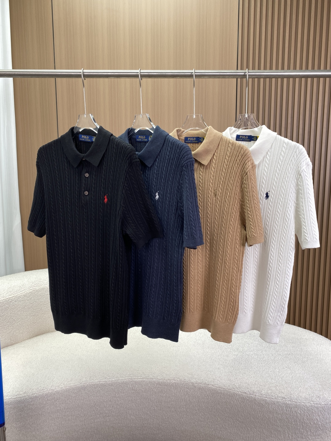 NO:826112,Ralph Lauren Polo Ralph Lauren cable knit short-sleeved Polo shirt core design and version This is Ralph Lauren's classic American retro-style knitted Polo, which combines a sense of leisure and sophistication. The classic Polo collar flat lapel design is crisp and stylish, modifies the neck line, and retains the brand's iconic business casual tone.  The twisted + vertical strip textured body adopts the knitting process of three-dimensional cable twist (twist) and vertical pit strips, which is visually more layered, and can modify the body shape, slimming and covering the flesh. The knitted structure also makes the clothes more breathable and elastic. The half placket has 3 buttons and 3 resin buttons on the front, making it easy to put on and take off. The opening and closing of the neckline can also be adjusted to suit different dressing styles.  The iconic Polo riding swing pony embroidery is embroidered on the left chest. Clothes in different colors are matched with horse logos of corresponding colors (such as white with dark blue, black with white/red, camel with the same color), low-key highlighting the brand identity. Materials and craftsmanship The fabric is pure cotton (except for decorative details), which is skin-friendly, breathable, and sweat-absorbent, suitable for daily wear in spring and summer. Detailed craftsmanship The buttons are made of resin, with the words 'RALPH LAUREN' engraved on the surface, with exquisite texture.  The cuffs and hem are ribbed to fix the shape and prevent deformation after washing. The knitted texture is tight, not easy to pill, and has strong durability. Color version 1. The white model is clean and refreshing, with a dark blue pony logo, suitable for spring and summer with light-colored bottoms, and the style is fresh and age-reducing. 2. The camel/khaki model is retro and gentle, with the pony logo of the same color, which is a representative color of American retro style, suitable for pairing with jeans and khaki pants. 3.  The pure black model has a classic cool feel, with a red pony logo, which has strong visual contrast, full of personality, and is suitable for street style wear. 4. The navy blue/dark gray blue model is low-key and high-end, with a white pony logo, between business and leisure, suitable for a variety of occasions. Washing and care instructions: gentle wash with water temperature below 30℃. Do not bleach. Can be tumble dried at low temperature. Iron at medium temperature (up to 150℃). Can be dry cleaned.  It is recommended that pure cotton knitwear be hand-washed or machine-washed gently to avoid long-term exposure to the sun, and to prevent fading and deformation. Suggestions for matching and scenarios: Wear it alone with jeans and casual shorts for daily casual wear, which is refreshing and comfortable, suitable for shopping and dating. Wear it with a light-colored shirt for work commuting, revealing the collar and pony logo, creating a light business style. Wear retro camel/white models with khaki pants and loafers to restore the classic American college style.,,loro  piana,loafers,shorts,jeans,shirts,T-shirt,19860909拉夫劳伦Polo Ralph Lauren 绞花针织短袖Polo衫  核心设计与版型 这是Ralph Lauren经典的美式复古风针织Polo,兼具休闲感与精致感 经典Polo领型平翻领设计,挺括有型,修饰颈部线条,保留了品牌标志性的商务休闲调性. 绞花+竖坑条纹理衣身采用立体绞花（麻花）与竖坑条交织的针织工艺,视觉上更具层次感,同时能修饰身形、显瘦遮肉,针织结构也让衣服更透气有弹性. 半开襟3粒扣前襟3颗树脂纽扣,方便穿脱,也可调节领口开合度,适配不同穿搭风格. 左胸小马标刺绣标志性的Polo骑马挥杆小马刺绣,不同配色衣服搭配对应色调的马标（如白色配深蓝、黑色配白/红、驼色配同色系）,低调彰显品牌身份. 材质与工艺 面料成分纯棉（除装饰细节外）,亲肤透气、吸汗性强,适合春夏季节日常穿着. 细节工艺 纽扣为树脂材质,表面刻有「RALPH LAUREN」字样,质感精致. 袖口与下摆采用罗纹收边,固定版型,防止洗后变形. 针织纹理紧密,不易起球,耐用性强. 颜色版本 1. 白色款干净清爽,搭配深蓝色小马标,适合春夏搭配浅色系下装,风格清新减龄. 2.驼色/卡其色款复古温柔,搭配同色系小马标,是美式复古风的代表配色,适合搭配牛仔裤、卡其裤. 3. 纯黑色款经典酷感,搭配红色小马标,视觉对比强烈,个性十足,适合街头风穿搭. 4. 藏蓝色/深灰蓝色款低调高级,搭配白色小马标,介于商务与休闲之间,适配多种场合. 洗涤护理说明 水温30℃以下轻柔洗涤 不可漂白 可低温滚筒烘干 中温熨烫（最高150℃） 可干洗 建议纯棉针织品尽量手洗或轻柔机洗,避免长时间暴晒,防止褪色与变形. 搭配与场景建议 日常休闲单穿搭配牛仔裤、休闲短裤,清爽舒适,适合逛街、约会. 职场通勤内搭在浅色衬衫中,露出领口与小马标,打造轻商务风格. 复古穿搭驼色/白色款搭配卡其裤、乐福鞋,还原经典美式学院风.,,loro piana,loafers,shorts,jeans,shirts,T-shirt,,Women's clothing