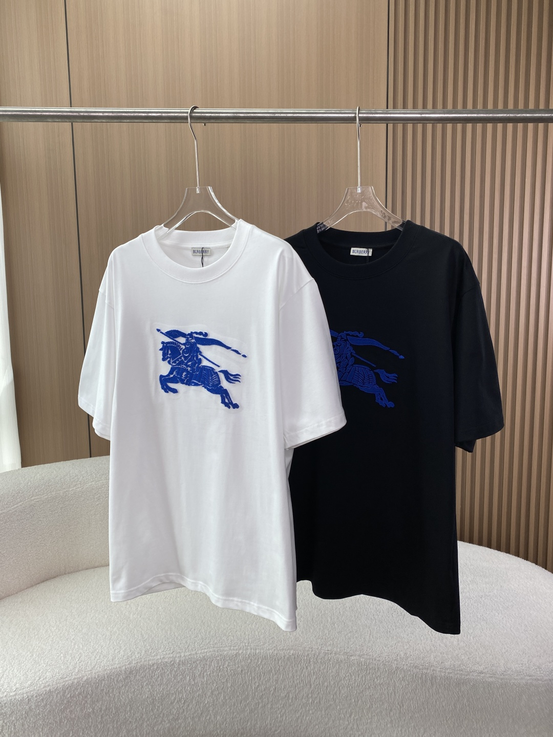 NO:839043,Burberry knight logo toothbrush embroidered short-sleeved T-shirt!  Design and style details 1. Visual design The core element uses Burberry’s iconic Knight Device (Equestrian Knight Device), presented with blue terry embroidery. The knight holds a spear and wears a flag, which has a strong visual three-dimensional effect. The colors are black and white, both with a solid base + blue knight logo. They are classic and versatile and suitable for different dressing scenes. The detailed processing collar is a ribbed round neck, the cuffs are flat design, and the hem is cut with a straight edge, and the overall style is loose and casual. 2.  Features: Loose shoulder (oversize) version, lower shoulder line, longer length, more tolerant to the body, suitable for creating lazy street style or British retro style. 3. Fabric and workmanship analysis 1. Fabric composition Main fabric cotton (COTTON) Knitted accessories (collar/cuffs) 95 cotton + 5 spandex (ELASTANE) to ensure elasticity and durability. Performance characteristics  The main body of cotton is breathable and sweat-absorbent, suitable for spring and summer wear; the spandex accessories improve the resilience of the collar and cuffs, reducing deformation and looseness after washing. It is a medium-thick T-shirt fabric. 2. The seams of the collar, cuffs, and hems are made of double-thread seaming technology, with high stitch density to ensure firmness for daily wear; the printing/embroidery knight is marked with towel embroidery technology, and the edges are frizzy-free. 5. Wearing and maintenance suggestions 1. Wearing scene  It can be worn alone for daily casual wear with denim shorts, overalls, and sports leggings, suitable for street, campus, commuting and other scenes; layered with denim jackets, windbreakers, and baseball uniforms in spring and autumn to enhance the British retro feel; shoes and bags can be paired with loafers, sneakers, Chelsea boots, and berets and tote bags can enhance the British style. 2. Washing and maintenance  The water temperature control is recommended to be hand-washed or machine washed in cold water below 30℃ to avoid high temperature causing flocking to fall off and the fabric to shrink; drying on the opposite side to avoid direct sunlight, which will cause the fabric to turn yellow and the flocking to fade; Ironing Note: If ironing is required, a pad is required for ironing at low temperature, and direct ironing of the flocked knight logo area is prohibited.,,burberry,burberry,versace,loafers,boots,totes,shorts,jackets &  coats, T-shirt, tees, t-shirt, hats,19860909巴宝莉Burberry骑士标牙刷绣短袖T恤！ 设计与版型细节 1. 视觉设计 核心元素采用Burberry标志性的骑士标（Equestrian Knight Device）,以蓝色毛巾绣工艺呈现,骑士手持长矛、身披旗帜,视觉立体感强. 色彩选择黑色、白色两款基础色,均为纯色底+蓝色骑士标,经典百搭,适配不同穿搭场景. 细节处理领口为罗纹圆领,袖口为平口设计,下摆为直边剪裁,整体偏向宽松休闲风格. 2. 版型特征 版型宽松落肩（Oversize）版型,肩线偏下、衣长偏长,对身材包容性较强,适合打造慵懒街头风或英伦复古风. 三、面料与做工解析 1. 面料成分 主体面料棉（COTTON） 针织辅料（领口/袖口）95棉 + 5氨纶（ELASTANE）,保证弹性与耐穿性. 性能特点 全棉主体面料透气吸汗,适合春夏季节穿着； 氨纶辅料提升了领口、袖口的回弹性,减少洗后变形、松垮,中等偏厚的T恤面料. 2. 做缝线领口、袖口、下摆均采用双线锁边工艺,针脚密度高,保证日常穿着牢固度； 印花/刺绣骑士标为毛巾绣工艺,边缘无毛躁. 五、穿搭与保养建议 1. 穿搭场景 日常休闲单穿搭配牛仔短裤、工装裤、运动束脚裤,适配街头、校园、通勤等场景； 叠穿搭配春秋季内搭于牛仔外套、风衣、棒球服下,强化英伦复古感； 鞋包适配搭配乐福鞋、板鞋、切尔西靴,搭配贝雷帽、托特包可提升英伦风格调性. 2. 洗涤保养 水温控制建议30℃以下冷水手洗或轻柔机洗,避免高温导致植绒脱落、面料缩水； 晾晒方式反面晾晒,避免阳光直射导致面料发黄、植绒褪色； 熨烫注意如需熨烫,需垫布低温熨烫,禁止直接熨烫植绒骑士标区域.,,burberry,burberry,versace,loafers,boots,totes,shorts,jackets & coats,T-shirt,tees，t-shirt,hats,,Women's clothing