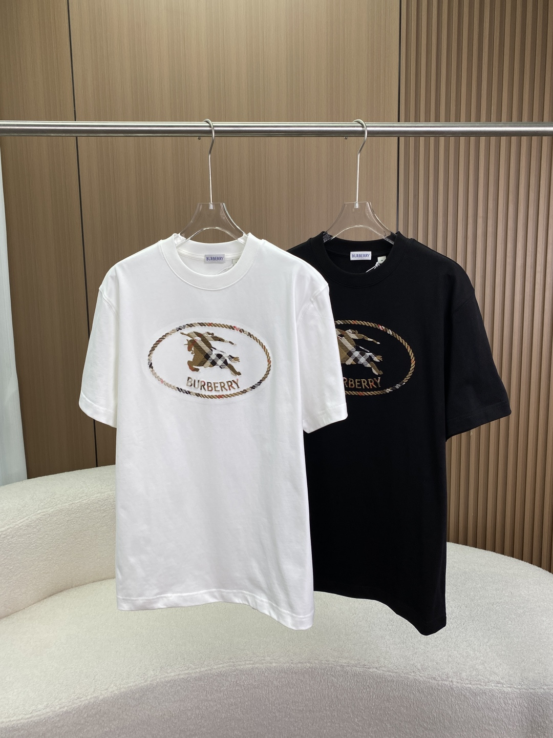 NO:832070,(Original customization) Burberry plaid knight logo embroidered cotton short-sleeved T-shirt. This is a classic basic T-shirt from the century-old British luxury brand Burberry. It combines the brand's iconic 'Vintage plaid' and 'knight logo' and presents it with three-dimensional embroidery technology. It is a light luxury item with both recognition and retro texture. Brand and design background Brand traceability Burberry  Founded in the UK in 1856, it uses the windbreaker, Vintage plaid and the Equestrian Knight Device as its three core symbols and is a classic representative of the global luxury goods industry. The design fusion of this model injects the brand's classic Vintage plaid (beige, brown, black and red) into the knight's logo embroidery, with a rope loop oval frame, which not only retains the retro solemnity of the knight's logo, but also strengthens the brand's recognition through the plaid elements, and belongs to the 'Classic Plaid Series'.  The logo symbolizes the warrior in the knight's logo holding a spear, and the Latin word 'Prorsum' (meaning 'forward') is printed on the flag, symbolizing the brand's pioneering spirit; the rope loop frame simulates the texture of a retro badge, improving the overall sophistication. Design and fit details The fit is cut using Relaxed Fit (loose dropped shoulders) or Boxy Fit (wide style)  Tailored, moderate length, very tolerant to the body shape, creating a casual and lazy sense of luxury, can be worn by both men and women (Unisex). There are two basic colors of white and black. The white model is fresh and white, while the black model is calm and versatile, suitable for different styles of wear. The neckline design is round collar + high-density rib reinforced collar, which fits the neck and is not easy to deform. The ribs are the same color as the body, making the overall vision more harmonious. Core logo  The chest is inlaid with an oval rope circle frame, using multi-color embroidery to simulate the hemp rope texture, with delicate and neat edges. Inside the frame is plaid knight embroidery. The outlines of the knight and the horse are spliced from Vintage plaid fabrics, with rich color levels and strong three-dimensionality. Below is the Burberry letter embroidery, the font echoes the plaid elements, and the details are exquisite. Fabrics and technology  The material component is combed cotton, which is a high-count pure cotton fabric. It has a soft and skin-friendly texture, excellent air permeability, good drape, and is not easily deformed after washing. It is suitable for spring and summer wear. Technological advantages: Three-dimensional embroidery technology The plaid knight and the rope loop border are precision embroidered, with fine stitches, clear edges, and a strong three-dimensional effect. It is not easy to fall off or deform after washing. The plaid part in the plaid splicing process accurately restores the color and texture of the Vintage plaid, with exquisite details.  Outfit and scene plan: The classic retro-style white model is paired with a denim skirt or khaki wide-leg pants, loafers or white shoes, and a beret to create a British retro look. The urban light luxury black model is paired with black suit pants or straight jeans, and a Burberry windbreaker or casual suit to low-key highlight the brand identity and is suitable for the workplace and high-end social scenes.  The layering method is to wear a turtleneck bottoming shirt inside and a knitted cardigan or vest outside. It can also continue the style in autumn and winter and enhance the layering of the outfit.,,burberry,burberry,loafers,skirts,jeans,T-shirt,tees,t-shirt,business suit,hats,19860909（原版定制） 巴宝莉Burberry格纹骑士标刺绣纯棉短袖T恤 这是英国百年奢侈品牌 Burberry（博柏利） 旗下经典基础款T恤,将品牌标志性「Vintage格纹」与「骑士标」融合,以立体刺绣工艺呈现,是兼具辨识度与复古质感的轻奢单品. 品牌与设计背景 品牌溯源Burberry 1856年创立于英国,以风衣、Vintage格纹和骑士标（Equestrian Knight Device） 为三大核心符号,是全球奢侈品行业的经典代表. 设计融合本款将品牌经典Vintage格纹（米棕黑红四色） 注入骑士标刺绣,搭配绳圈椭圆形边框,既保留了骑士标的复古庄重感,又通过格纹元素强化了品牌辨识度,属于「经典格纹系列」. 标识寓意骑士标中的武士手持长矛,旗帜上印有拉丁文 ”Prorsum“（意为「前进」）,象征品牌的开拓精神；绳圈边框模拟复古徽章的质感,提升了整体精致度. 设计与版型细节 版型剪裁采用 Relaxed Fit（宽松落肩） 或 Boxy Fit（阔型） 剪裁,衣长适中,对身材包容性极强,营造随性慵懒的高级感,男女皆可穿着（Unisex）. 配色选择白色、黑色两种基础色,白色款清新显白,黑色款沉稳百搭,适配不同风格穿搭. 领口设计圆领+高密罗纹加固领口,贴合颈部且不易变形,罗纹与衣身同色,整体视觉更和谐. 核心标识 胸前镶嵌椭圆形绳圈边框,采用多色刺绣模拟麻绳纹理,边缘细腻工整. 框内为格纹骑士刺绣骑士与马匹的轮廓由Vintage格纹面料拼接而成,色彩层次丰富,立体感强. 下方为Burberry字母刺绣,字体与格纹元素呼应,细节精致. 面料与工艺 材质成分精梳棉,属于高支纯棉面料,质感柔软亲肤,透气性极佳,垂坠感好,洗后不易变形,适合春夏季节穿着. 工艺优势 立体刺绣工艺格纹骑士与绳圈边框采用精密刺绣,针脚细密、边缘清晰,立体感强,洗后不易脱线、变形. 格纹拼接工艺骑士标中的格纹部分精准还原Vintage格纹的色彩与纹理,细节考究. 穿搭与场景方案 经典复古风白色款搭配牛仔半裙或卡其色阔腿裤,脚踩乐福鞋或小白鞋,搭配贝雷帽,打造英伦复古造型. 都市轻奢风黑色款搭配黑色西装裤或直筒牛仔裤,外搭Burberry风衣或休闲西装,低调彰显品牌身份,适配职场与高端社交场景. 叠穿玩法内搭高领打底衫,外穿针织开衫或马甲,秋冬也能延续风格,提升穿搭层次感.,,burberry,burberry,loafers,skirts,jeans,T-shirt,tees，t-shirt,business suit,hats,,Women's clothing