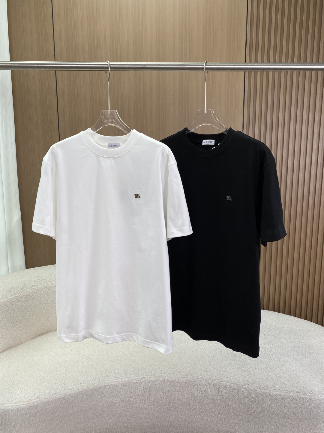 NO:833884,(Original customization) Real praise Burberry Metal Knight logo pure cotton short-sleeved T-shirt This is a classic basic T-shirt from the British luxury brand Burberry. It uses the iconic Metal Knight badge as the core identification point and focuses on 'minimalist high-end + comfortable and skin-friendly'. It is an evergreen item in the brand's wardrobe. Brand and logo background Brand traceability Burberry  Founded in England in 1856, it is a century-old luxury brand with windbreakers, plaid and the Equestrian Knight Device as its three core symbols. The metal badge on the chest is the brand's classic 'horse warrior' logo, with the warrior holding a spear and the Latin word 'Prorsum' (meaning 'forward') printed on the flag, symbolizing the brand's pioneering spirit. The metallic badge is more refined and recognizable than the print.  The style positioning belongs to the brand's minimalist casual line, which weakens the strong identification elements such as plaid and uses low-key metal labels to highlight the identity, adapting to urban high-end daily scenes. Design and fit details The cut adopts Boxy Fit (loose and wide) or Relaxed Fit (dropped shoulders and loose) cut, the length is moderate, and it is very tolerant to the body, creating a casual and lazy sense of luxury, and can be worn by both men and women (Unisex).  The neckline is designed with a round neck + high-density ribbing to reinforce the neckline, which fits the neck and is not easy to deform. It can be easily layered with a jacket or inner layer, and is suitable for a variety of wearing scenarios. Logo details: The metal knight badge on the left side of the chest is bronze for the white model, and silver for the black model. The craftsmanship is exquisite and the edges are smooth, which is the core visual highlight. The collar label is the classic Burberry logo with white letters on a blue background, and the hangtag is printed with the complete knight pattern and brand information. The accessories are complete.  The color scheme is white and black, which are simple and versatile. It is the 'universal basic model' in the wardrobe. Fabric and process Materials: Combed cotton, a high-count pure cotton fabric, soft and skin-friendly, with excellent breathability, suitable for spring and summer seasons. Process advantages: The combing process removes short fibers, making the fabric more delicate, less prone to pilling, and more durable. The fabric has a good drape, is not easily deformed after washing, keeps the shape crisp, and has a more advanced texture than ordinary cotton T-shirts.  The metal badge adopts high-temperature pressing or sewing process, which is high in firmness and not easy to fall off. Washing and maintenance guide Washing requirements: Gentle machine or hand wash, water temperature does not exceed 30°C, use neutral detergent. Wash inside out to avoid friction between the metal badge and other clothes, causing scratches or falling off. Wash dark/light-colored clothes separately to avoid color transfer. Contraindications Do not bleach, do not dry clean, do not iron at high temperature (only low-temperature steam ironing can be used).  It is recommended to lay flat or hang to dry in the shade to avoid sun exposure that may cause yellowing of the fabric and fading of the metal badge. Outfit and scene plan: Pair with high-waist suit pants/straight jeans for urban commuting style, and a Burberry windbreaker or casual suit to create a low-key and luxurious workplace look. Casual daily style with cargo shorts/denim hot pants, white shoes or loafers, suitable for citywalks, dates, etc., casual and advanced.  The layering method is to wear a turtleneck bottoming shirt inside and a denim jacket or vest outside. You can also continue the style in autumn and winter and enhance the layering of your outfit.,,burberry,burberry,loafers,shorts,jeans,jackets & coats,T-shirt,tees,t-shirt,business suit,19860909（原版定制）实物赞 巴宝莉Burberry金属骑士标纯棉短袖T恤 这是英国奢侈品牌 Burberry（博柏利） 旗下经典基础款T恤,以标志性金属骑士徽章为核心识别点,主打「极简高级感+舒适亲肤」,是品牌衣橱里的常青单品. 品牌与标识背景 品牌溯源Burberry 1856年创立于英国,是具有百年历史的奢侈品牌,以风衣、格纹和骑士标（Equestrian Knight Device） 为三大核心符号. 标识意义胸前的金属徽章是品牌经典「骑马武士」标识,武士手持长矛,旗帜上印有拉丁文 ”Prorsum“（意为「前进」）,象征品牌的开拓精神,金属质感的徽章比印花更具精致感与辨识度. 风格定位属于品牌极简休闲线,弱化了格纹等强识别元素,以低调金属标彰显身份,适配都市高端日常场景. 设计与版型细节 版型剪裁采用 Boxy Fit（宽松阔型） 或 Relaxed Fit（落肩宽松） 剪裁,衣长适中,对身材包容性极强,营造随性慵懒的高级感,男女皆可穿着（Unisex）. 领口设计圆领+高密罗纹加固领口,贴合颈部且不易变形,可轻松叠穿外套或内搭,适配多种穿搭场景. 标识细节 胸前左侧镶嵌金属骑士徽章白色款为古铜色,黑色款为银色,工艺精致、边缘光滑,是视觉核心亮点. 领标为经典蓝底白字Burberry标识,吊牌印有完整骑士图案与品牌信息,配件完整. 配色选择白色、黑色两种基础色,简约百搭,是衣橱里的「万能基础款」. 面料与工艺 材质成分精梳棉,属于高支纯棉面料,质感柔软亲肤,透气性极佳,适合春夏季节穿着. 工艺优势 精梳工艺去除了短纤维,面料更细腻、不易起球、耐穿性更强. 面料垂坠感好,洗后不易变形,保持版型挺括,比普通纯棉T恤更具高级质感. 金属徽章采用高温压烫或缝制工艺,牢固度高,不易脱落. 洗护与保养指南 洗涤要求 轻柔机洗或手洗,水温不超过30℃,使用中性洗涤剂. 反面洗涤,避免金属徽章与其他衣物摩擦导致刮花或脱落. 深色/浅色衣物分开洗涤,避免串色. 禁忌操作不可漂白、不可干洗、不可高温熨烫（仅可低温蒸汽熨烫）. 晾晒建议阴凉处平铺或悬挂晾干,避免阳光暴晒导致面料发黄、金属徽章褪色. 穿搭与场景方案 都市通勤风搭配高腰西装裤/直筒牛仔裤,外搭Burberry风衣或休闲西装,打造低调奢华的职场造型. 休闲日常风搭配工装短裤/牛仔热裤,脚踩小白鞋或乐福鞋,适合citywalk、约会等场景,随性又高级. 叠穿玩法内搭高领打底衫,外穿牛仔外套或马甲,秋冬也能延续风格,提升穿搭层次感.,,burberry,burberry,loafers,shorts,jeans,jackets & coats,T-shirt,tees，t-shirt,business suit,,Women's clothing
