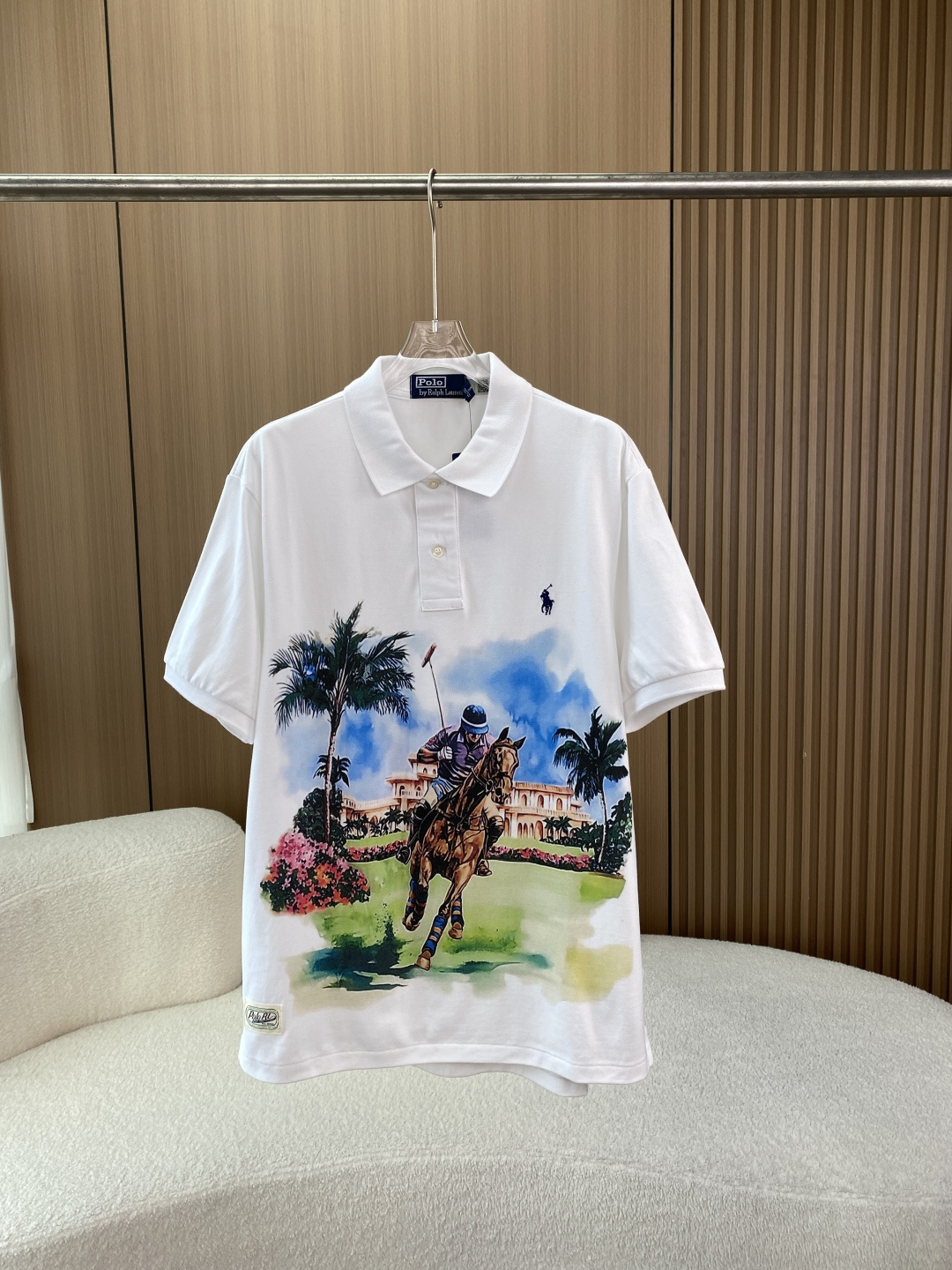 NO:808320,Ralph Lauren Polo Ralph Lauren watercolor style polo print Polo shirt 1. Basic fit and fabric The brand’s classic Classic Fit (classic version) silhouette, lapel + double-button placket design, low armholes, loose sleeves, not tight, not flattering, is the standard version of American casual Polo. The fabric is cotton pique mesh (Pique Mesh), which is commonly known as 'pique cotton'  The surface has a concave and convex mesh structure, which is breathable, sweat-absorbent and stiff. It does not stick to the body when sweating, and is not easily deformed after long-term wear. It is the golden fabric of Polo shirts, which is different from the soft feeling of ordinary plain cotton. 2. Brand logo details Collar label and hang tag The collar label is the brand's classic blue background with white letters 'Polo by Ralph Lauren', the exclusive serif font is clear and neat, and the stitching has no jumps; the hang tag is thick cardboard with dark blue hot stamping design, 'POLO RALPH'  'LAUREN' gold stamping is clear, no gold is lost or blurred. The pony embroidery on the left chest (the soul of the brand) has a three-dimensional and full outline of the human and horse, the horse's muscle lines and the rider's clothing folds are clear and without adhesion; the horse's legs have a unique hook design at the end, the hind legs are straight, the tail is natural, and the rider's swing angle is standard; the embroidery thread is high-density cotton thread with uniform color, no missing stitches or skipped threads. Other details The placket buttons have a warm and natural texture.  The whole dress is neatly routed, and the collar and cuffs are neatly hemmed. 3. Printing pattern design The process uses watercolor-style reactive printing instead of cheap offset printing. The edges are naturally smudged, which is highly integrated with the fabric. It feels soft and has no hard glue feeling. It will not crack or peel off after long-term wear. The design elements are based on the brand's core 'polo sport', with palm trees, European-style palaces, blue skies and white clouds. It combines American polo culture and tropical resort style, and belongs to the brand's resort series (Resort).  Collection)/Polo themed limited edition, positioned higher than basic solid color models. The core of design inspiration of Ralph Lauren is 'American aristocratic lifestyle'. This print combines polo sports with vacation scenes, focusing on elegant and casual American retro tones. It is a popular design of the brand. 4. Full-scenario dressing plan (one outfit for multiple wear) 1. Casual commuting/light business style with khaki casual pants/dark gray trousers + loafers/white shoes + simple belt  Applicable scenarios: office commuting, weekend dates, friends gatherings, formal and not rigid, perfect for American casual business style. 2. Vacation style/summer travel: Pair with white linen shorts/light blue denim shorts + flip-flops/canvas shoes + straw hat + sunglasses. Applicable scenarios: seaside vacation, city stroll, camping, printed vacation feeling is full, refreshing and breathable. 3. Citywalk/American retro style, paired with distressed straight jeans/military green overalls + retro sneakers/Martin boots +  Baseball cap + crossbody bag is suitable for daily shopping, visiting stores, and taking photos. It has a full American retro feel and a very high production rate. 4. For spring and autumn layering styles, match this Polo with a denim jacket/navy suit/knitted cardigan + casual pants/jeans.  Before washing, turn the clothes inside out, stand up the collar, fasten the buttons, and put them in a laundry bag to reduce friction and protect printing and embroidery; 2. Prioritize hand washing, choose gentle mode for machine washing, water temperature ≤30℃ (more conservative than the washing standard to prevent shrinkage), use neutral laundry detergent, prohibit the use of bleach, strong detergents, and softeners (softeners will block the pique cotton mesh and affect breathability); 3.  The soaking time should not exceed 30 minutes to avoid fading of the print; 4. Rinse thoroughly without any laundry detergent residue to prevent the fabric from turning yellow. Drying and drying techniques Do not twist, press gently to drain the water, turn it over and lay it flat in a cool and ventilated place to dry. Direct sunlight is absolutely prohibited (it will cause yellowing, fading of the print, and discoloration of the embroidery thread); It is forbidden to dry the fabric at high temperature (it will cause shrinkage, deformation, and cracking of the print). If drying is required, it can only be dried at low temperature for a short time;  Avoid using ordinary hangers to hang on your shoulders to prevent bulges from deforming. You can use hangers with beams to hang from the middle, or fold them in half on the hangers. Daily care and storage: Wash in time after wearing to avoid long-term sweat stains that may cause yellowing; Use medium and low temperature steam for ironing, put a layer of cloth on it, and do not directly iron printing and embroidery; When storing, fold and store, do not hang it for a long time (it will stretch and deform), and put insect repellent to prevent insect infestation.,, loro  piana,loafers,boots,satchels,crossbody bags,shorts,jeans,jackets & coats,business suit,gold,hats,19860909拉夫劳伦Polo Ralph Lauren 水彩风马球印花Polo衫 1. 基础版型与面料 版型品牌经典Classic Fit（经典版）廓形,翻领+双扣门襟设计,袖孔偏低、衣袖宽松,不紧绷、不挑身材,是美式休闲Polo的标准版型. 面料棉珠地网眼布（Pique Mesh）,也就是俗称的“珠地棉” 表面有凹凸的网眼结构,透气、吸汗、挺括,出汗不贴身,久穿不易变形,是Polo衫的黄金面料,区别于普通平纹棉的软塌感. 2. 品牌标识细节 领标与吊牌 领标为品牌经典蓝底白字「Polo by Ralph Lauren」,专属衬线字体清晰工整,缝线无跳线； 吊牌为厚卡纸深蓝色烫金设计,「POLO RALPH LAUREN」金色压印清晰,无掉金、模糊. 左胸小马刺绣（品牌灵魂） 人马轮廓立体饱满,马匹肌肉线条、骑手服饰褶皱清晰无粘连； 马腿末端带专属钩型设计,后腿笔直、尾巴自然,骑手挥杆角度标准； 绣线为高密棉线,颜色均匀,无漏针、跳线. 其他细节 门襟纽扣质感温润有天然纹理. 整件衣服走线工整,领口、袖口包边整齐. 3. 印花图案设计 工艺采用水彩风活性印花,而非廉价胶印印花边缘自然晕染,与面料融合度高,手感柔软,无硬胶感,久穿不开裂、不掉漆. 设计元素以品牌核心的「马球运动」为主体,搭配棕榈树、欧式宫殿、蓝天白云,融合了美式马球文化与热带度假风,属于品牌度假系列（Resort Collection）/马球主题限定款,定位高于基础纯色款. 设计灵感Ralph Lauren的核心是「美式贵族生活方式」,这款印花将马球运动与度假场景结合,主打优雅、休闲的美式复古调性,是品牌的热门设计款. 四、全场景穿搭方案（一衣多穿） 1. 休闲通勤/轻商务风 搭配卡其色休闲裤/深灰色西裤 + 乐福鞋/小白鞋 + 简约皮带 适用场景办公室通勤、周末约会、朋友小聚,正式不刻板,完美适配美式休闲商务风. 2. 度假风/夏日出行 搭配白色亚麻短裤/浅蓝色牛仔短裤 + 夹脚拖/帆布鞋 + 草帽+墨镜 适用场景海边度假、城市漫步、露营,印花的度假感拉满,清爽透气. 3. Citywalk/美式复古风 搭配做旧直筒牛仔裤/军绿色工装裤 + 复古板鞋/马丁靴 + 棒球帽+斜挎包 适用场景日常逛街、探店、拍照,美式复古感拉满,出片率极高. 4. 春秋叠穿造型 搭配内搭这件Polo + 外搭牛仔夹克/藏青色西装/针织开衫 + 休闲裤/牛仔裤 适用场景春秋通勤、出游,实现一衣多穿,实用性拉满. 正确洗涤步骤 1. 洗涤前将衣服翻面,立起领子、扣好纽扣,装入洗衣袋,减少摩擦保护印花与刺绣； 2. 洗涤方式优先手洗,机洗选轻柔模式,水温≤30℃（比洗标更保守,防止缩水）,用中性洗衣液,禁止用漂白剂、强力去污剂、柔顺剂（柔顺剂会堵塞珠地棉网眼,影响透气性）； 3. 浸泡时间不超过30分钟,避免印花褪色； 4. 漂洗彻底漂洗干净,无洗衣液残留,防止面料发黄. 晾晒与烘干技巧 不要拧扭,轻轻按压沥干水分,翻面平铺在阴凉通风处晾干,绝对禁止阳光直射（会导致发黄、印花褪色、绣线变色）； 禁止滚筒高温烘干（会导致缩水、变形、印花开裂）,如需烘干仅可低温短时间烘干； 避免用普通衣架挂肩膀,防止鼓包变形,可用带横梁的衣架从中间穿挂,或对折搭在衣架上. 日常保养与收纳 穿着后及时清洗,避免汗渍长期残留导致发黄； 熨烫用中低温蒸汽,垫一层布,不要直接熨烫印花与刺绣； 收纳时折叠存放,不要长期悬挂（会拉长变形）,放置防虫剂防止虫蛀.,,loro piana,loafers,boots,satchels,crossbody bags,shorts,jeans,jackets & coats,business suit,gold,hats,,Women's clothing