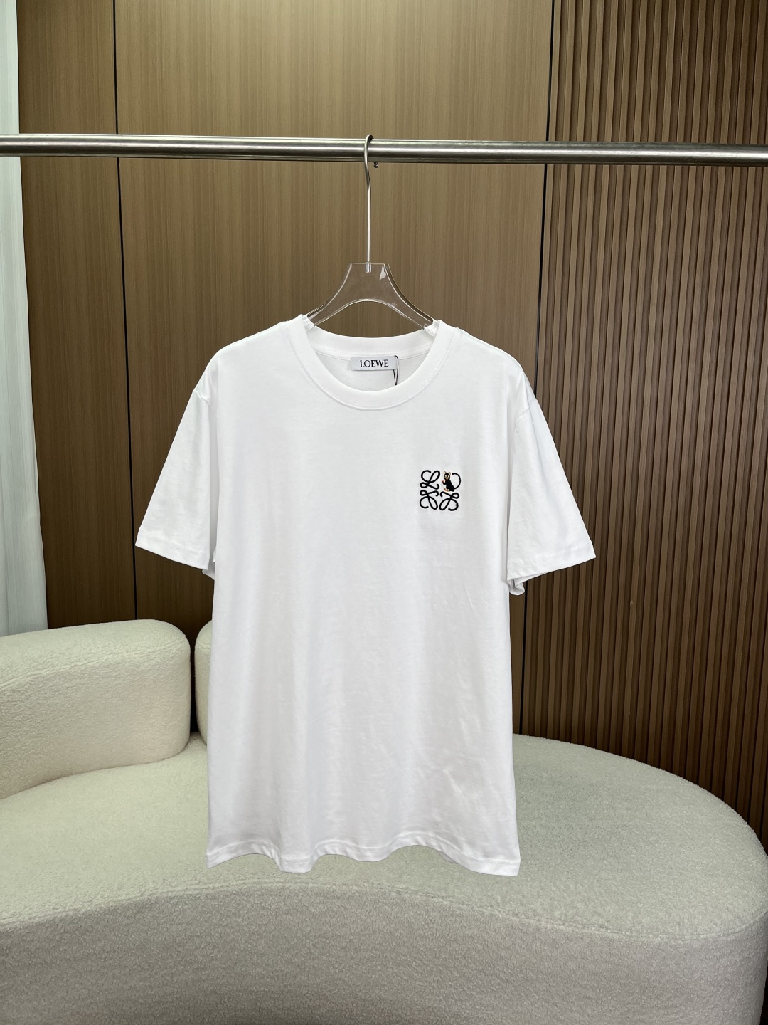 NO:824408,LOEWE black cat embroidered Anagram short-sleeved T-shirt!  This is the core item of the cute animal series of LOEWE's 2025-2026 spring and summer series. It is based on the brand's classic Anagram intertwined logo and incorporates cute black cat embroidery elements, which is both low-key luxury and fun. Style design 1. Core design element Front embroidery The main body is LOEWE's iconic Anagram (four-way interweaving) logo, which is symmetrically interwoven with four L letters and is the most recognizable symbol of the brand;  The right side incorporates three-dimensional black cat embroidery on a black background with orange/gold details (ears, paws, face). The shape is smart and cute, breaking the monotony of a pure logo. It is a design idea of 'low-key yet cute'; The embroidery process uses high-density three-dimensional embroidery, with fine and neat stitches, a full three-dimensional pattern, and it will not deform or fall off after long-term washing.  The silhouette adopts a loose, dropped-shoulder wide cut, which is the same style for men and women. It is highly tolerant to all body shapes (thin, slightly fat, and strong), hides fat and makes you look slimmer, creating an unintentional sense of relaxation, and is suitable for the current popular oversize wear. The color selection is basically pure white, refreshing and versatile, suitable for all seasons, and is also available in black in the same series. Fabrics and ingredients 1. Fabric ingredients  The main fabric is pure cotton, and the ribbed parts (collar/cuffs/hem) are also cotton, which is a high-end fabric configuration for luxury T-shirts. 2. Fabric advantages: Heavy long-staple cotton, skin-friendly and breathable, strong sweat absorption, no stuffiness when worn in spring and summer; The fabric has been pre-shrunk, so it will not shrink or deform easily after long-term wear.  Wearing plan for all scenes 1. Daily casual style white black cat T-shirt + blue straight jeans + retro sneakers/canvas shoes, creating an American campus and Japanese relaxed feel, suitable for daily outings and dates. 2. Commuting light business style white black cat T-shirt + dark gray casual trousers + loafers/derby shoes, suitable for informal business occasions, low-key and textured. 3. Hot girl/missing bottom style white black cat T-shirt +  Black cycling pants/stockings + dad shoes, create a hot girl outfit, the same style for men and women, suitable for street and fashion scenes. 4. Spring and autumn layering style white black cat T-shirt + denim jacket/white shirt + casual pants, create a sense of layering, full sense of luxury, suitable for all seasons.,,loewe,loewe,versace,loafers,jeans,jackets & coats,shirts,T-shirt,tees,t-shirt,19860909LOEWE（罗意威）黑猫刺绣Anagram短袖T恤 ！这是LOEWE 2025-2026春夏系列的萌趣动物系列核心单品,以品牌经典Anagram交织logo为基底,融入可爱黑猫刺绣元素,兼具低调奢华与趣味感. 款式设计 1. 核心设计元素 正面刺绣 主体为LOEWE标志性Anagram（四向交织）logo,由4个L字母对称交织而成,是品牌最具辨识度的符号； 右侧融入立体黑猫刺绣黑底搭配橘色/金色细节（耳朵、爪子、面部）,造型灵动可爱,打破纯logo的单调,是“低调中带萌点”的设计巧思； 刺绣工艺采用高密立体绣,针脚细密工整,图案饱满立体,久洗不变形、不脱线. 版型剪裁采用宽松落肩阔版剪裁,男女同款,对所有身形（瘦、微胖、壮硕）都有极强包容性,藏肉显瘦,打造不刻意的松弛感,适配当下流行的Oversize穿搭. 配色选择基础纯白色,清爽百搭,适配全季节穿搭,也有同系列黑色款可选. 面料与成分 1. 面料成分 主体面料为纯棉,罗纹部分（领口/袖口/下摆）同样为棉,是奢侈品T恤的高端面料配置. 2. 面料优势 重磅长绒棉,亲肤透气,吸汗性强,春夏穿着无闷热感； 面料经过预缩水处理,久穿不易缩水、不易变形,越穿越软,越穿越有质感； 垂坠感优秀,上身挺括不塌,打造慵懒松弛的穿搭效果. 全场景穿搭方案 1. 日常休闲风 白色黑猫T恤 + 蓝色直筒牛仔裤 + 复古板鞋/帆布鞋,打造美式校园、日系松弛感,适配日常出街、约会. 2. 通勤轻商务风 白色黑猫T恤 + 深灰色休闲西裤 + 乐福鞋/德比鞋,适配非正式商务场合,低调有质感. 3. 辣妹/下衣失踪风 白色黑猫T恤 + 黑色骑行裤/长筒袜 + 老爹鞋,打造辣妹穿搭,男女同款,适配街头、潮流场景. 4. 春秋叠穿风 白色黑猫T恤 + 牛仔外套/白色衬衫 + 休闲裤,打造层次感,高级感拉满,适配全季节.,,loewe,loewe,versace,loafers,jeans,jackets & coats,shirts,T-shirt,tees，t-shirt,,Women's clothing