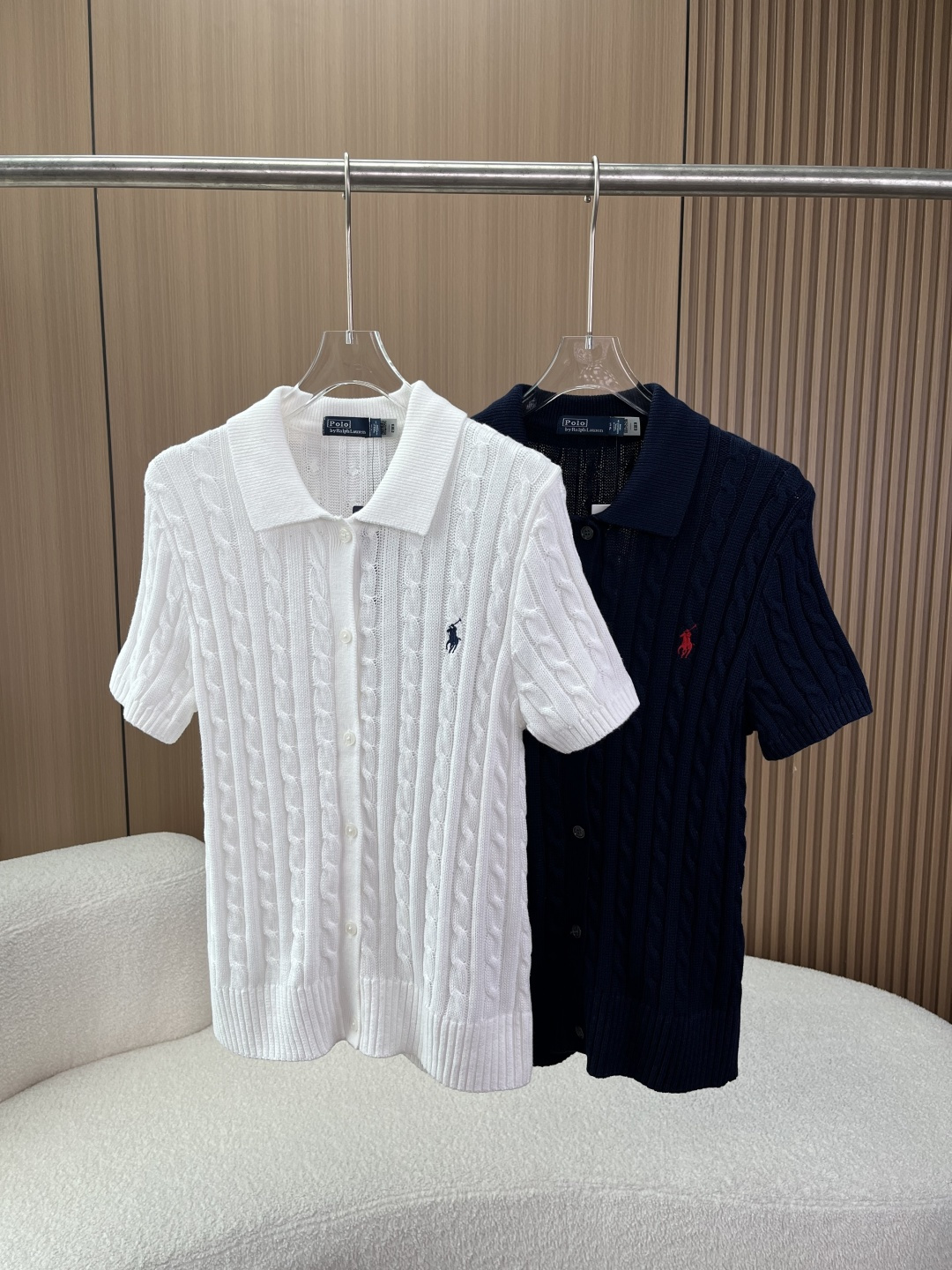 NO:833870,Polo Ralph Lauren cable knitted short-sleeved Polo collar cardigan Style and design This is Polo Ralph Lauren's classic cable knitted short-sleeved Polo collar cardigan. It is the brand's iconic American retro college-style evergreen style. It comes in two classic colors of white and navy. The fit/slim fit, Polo lapel + full button placket design, the opening and closing can be freely adjusted, suitable for both men and women, regardless of body shape;  Craftsmanship details: The whole body adopts the brand's classic twist (twist) knitting technology, with a three-dimensional and full texture, and a retro texture; the brand logo is embellished with the iconic Polo Pony pony embroidery on the left chest (the white model is a navy pony, the navy model is a red pony), and the lines are delicate and three-dimensional, which is the core of brand recognition; The ribbed hem + cuffs are designed with a reinforced version, which is not easy to deform after long-term wear, and the short-sleeved design is suitable for spring and summer wear. Fabrics and technology  The fabric is mostly made of cotton (except for decorations) and is knitted with high-count combed cotton. It feels soft and skin-friendly, moisture-absorbent and breathable. It will not make you sweaty when worn in spring and summer, while ensuring the crispness of the knitted structure; Process standards Cable knitting adopts three-dimensional weaving technology, the texture is uniform and tight, and it is not easy to deform; Customized buttons are neatly made and open and close smoothly, and some genuine buttons have brand logos; Pony embroidery stitches are fine and the edges are clear. Wearing suggestions  The college style style is paired with pleated skirts/straight jeans + loafers/white shoes to create an American retro college style; For daily casual wear, pair high-waisted casual pants/shorts + canvas shoes, suitable for commuting, traveling and other scenarios; For layering, wear a suspender/shirt inside and a suit/windbreaker outside to create a layered look, suitable for spring and autumn; For light business scenes, pair cigarette pants + loafers to create a simple and advanced light commuting look.,,loro  piana,loafers,skirts,shorts,jeans,shirts,T-shirt,business suit,19860909拉夫劳伦Polo Ralph Lauren 绞花针织短袖Polo领开衫  款式与设计 这是拉夫劳伦（Polo Ralph Lauren）的经典绞花针织短袖Polo领开衫,是品牌标志性的美式复古学院风常青款,白色、藏青色两种经典配色 版型合身/修身版型,Polo翻领+全纽扣门襟设计,可自由调节开合度,适配男女同款穿搭,不挑身材； 工艺细节全身采用品牌经典绞花（麻花）针织工艺,纹理立体饱满,自带复古质感； 品牌标识左胸点缀标志性Polo Pony小马刺绣（白色款为藏青小马,藏青色款为红色小马）,走线细腻立体,是品牌辨识度核心； 细节设计罗纹下摆+袖口,加固版型,长期穿着不易变形,短袖设计适配春夏穿着. 面料与工艺 面料大身棉（装饰物除外）,采用高支精梳棉针织,手感软糯亲肤,吸湿透气,春夏穿着不闷汗,同时保证针织结构的挺括感； 工艺标准 绞花针织采用立体编织工艺,纹理均匀紧密,不易变形； 定制纽扣做工工整,开合顺畅,部分正品纽扣带有品牌标识； 小马刺绣针脚细密,边缘清晰. 穿搭建议 学院风造型搭配百褶裙/直筒牛仔裤+乐福鞋/小白鞋,打造美式复古学院风； 日常休闲搭配高腰休闲裤/短裤+帆布鞋,适配通勤、出游等多场景； 叠穿玩法内搭吊带/衬衫,外搭西装/风衣,打造层次感造型,适配春秋； 轻商务场景搭配烟管裤+乐福鞋,打造简约高级的轻通勤造型.,,loro piana,loafers,skirts,shorts,jeans,shirts,T-shirt,business suit,,Women's clothing