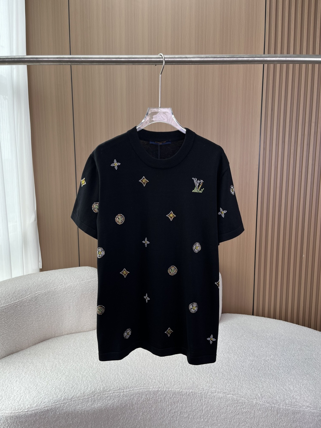NO:838469,(Original customization) Louis Vuitton 2026 hot-drilled knitted short-sleeved T-shirt Style and design This is Louis Vuitton (LV) 2026 spring and summer series letter flower hot-dried knitted short-sleeved T-shirt. It is a new design of the brand's classic Monogram elements. The main body is pure black knitted fabric, with a ribbed round neck design. The version is loose and casual, suitable for men and women.  The front is fully printed with classic LV Monogram presbyopia elements (four-leaf stars, rhombuses, circles), all presented with hot-drilled craftsmanship, with a strong sense of visual hierarchy; the chest, back and sleeves are embellished with the LV lettered hot-dried logo, and the details echo the brand's iconic design. The overall style is light, luxurious and advanced, with a casual and recognizable feel, and is suitable for daily commuting, trendy wear and other scenarios. Fabrics and technology The main fabric is cotton, knitted material is breathable and skin-friendly, making it comfortable to wear in summer without sweating, while ensuring that the style is crisp and not easily deformed.  Craftsmanship: The rhinestones are inlaid with technology to enhance the three-dimensional effect and durability, and prevent the rhinestones from falling off. The ribbed neckline is neatly crafted and has a double-layer reinforced design, making it less likely to loosen after long-term wear and with even routing. Wearing suggestions: Pair with denim shorts/casual pants + white shoes for daily casual wear to create a relaxed street style. Pair with trousers/casual trousers + loafers for light luxury commuting, suitable for light business scenes.  Pair the trendy look with the same series of LV shorts/dungarees to create a complete brand look and enhance recognition.,,louis vuitton,louis vuitton,louis vuitton,loafers,shorts,T-shirt,tees,t-shirt,19860909（原版定制） Louis Vuitton路易威登 2026烫钻针织短袖T恤  款式与设计 这是路易威登（LV）2026春夏系列的字母花卉烫钻针织短袖T恤,属于品牌经典Monogram元素的焕新设计 主体为纯黑色针织面料,采用罗纹圆领设计,版型宽松休闲,适配男女穿搭. 正面满印LV经典Monogram老花元素（四叶星、菱形、圆形）,全部以烫钻工艺呈现,视觉层次感强；胸口、后背及袖子均点缀LV字母烫钻标识,细节呼应品牌标志性设计. 整体风格轻奢高级,兼具休闲感与辨识度,适合日常通勤、潮流穿搭等多场景. 面料与工艺 面料主面料为棉,针织材质透气亲肤,夏季穿着舒适不闷汗,同时保证版型挺括不易变形. 工艺 烫钻采用镶嵌式工艺,提升立体感和耐用性,避免烫钻脱落. 罗纹领口做工工整,双层加固设计,长期穿着不易松垮,走线均匀. 穿搭建议 日常休闲搭配牛仔短裤/休闲裤+小白鞋,打造松弛感街头风. 轻奢通勤搭配西裤/休闲西裤+乐福鞋,适配轻商务场景. 潮流造型搭配同系列LV短裤/工装裤,打造全套品牌造型,提升辨识度.,,louis vuitton,louis vuitton,louis vuitton,loafers,shorts,T-shirt,tees，t-shirt,,Women's clothing